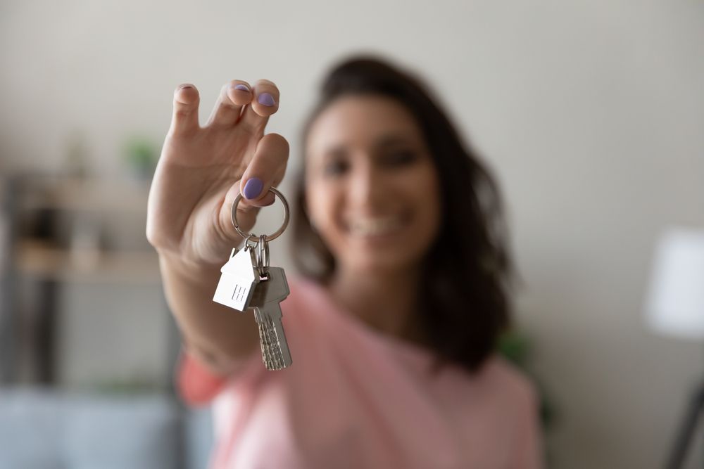 satın aldığı evin anahtarını tutan kadın görseli