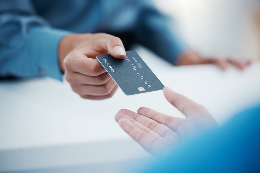 kredi kartını bankacıya uzatan kişi