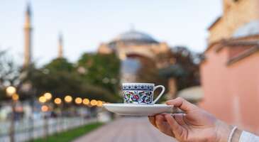 Asya ve Avrupa kıtalarını birbirine bağlayan İstanbul, y&uuml;zyıllar boyunca &uuml;&ccedil; b&uuml;y&uuml;k imparatorluğa başkentlik yapmış b&uuml;y&uuml;leyici bir şehir. İstanbul, sadece T&uuml;rkiye&rsquo;nin değil d&uuml;nyanın en etkileyici metropolleri arasında yer alıyor. Bu kadim şehir, Tarih&icirc; Yarımada&rsquo;nın mistik atmosferinden İstanbul Boğazı&rsquo;nın masalsı manzaralarına kadar her k&ouml;şesinde farklı bir hik&acirc;ye anlatıyor. İstanbul, k&ouml;kl&uuml; ge&ccedil;mişi ile modern yaşamı kusursuz bir uyumla birleştiriyor. İstanbul denince ilk akla gelen yerlere, lezzetlere, k&uuml;lt&uuml;rel mirası yansıtan hediyelik &uuml;r&uuml;nlere ve mutlaka g&ouml;rmen gereken ikonik duraklara g&ouml;z at! İstanbul&rsquo;un meşhur yemekleri İstanbul, y&uuml;zyıllar boyunca farklı k&uuml;lt&uuml;rlerin harmanlandığı devasa bir mutfak k&uuml;lt&uuml;r&uuml;ne sahip. İşte İstanbul&rsquo;un en meşhur lezzetleri: 1. Sultanahmet k&ouml;ftesi İstanbul&rsquo;un tarih&icirc; yarımadası ile &ouml;zdeşleşen Sultanahmet k&ouml;ftesi, ge&ccedil;mişten g&uuml;n&uuml;m&uuml;ze ulaşan en klasik lezzetlerden biri. İ&ccedil; harcında baharatın minimumda tutulması, etin kendi tadının &ouml;n plana &ccedil;ıkmasını sağlıyor. Yanında servis edilen &ouml;zel acı sosu ve piyazı ile Sultanahmet k&ouml;ftesi, turistlerin Sultanahmet gezilerinde tercih ettiği vazge&ccedil;ilmez lezzet. 2. Balık ekmek Hali&ccedil;&rsquo;in sularında sallanan teknelerden y&uuml;kselen ızgara balık kokusu İstanbul&rsquo;un ikonik kokularından. Taze uskumrunun soğan, marul ve bol limonla ekmek arasına girmesiyle oluşan bu lezzet, en g&uuml;zel Emin&ouml;n&uuml;&rsquo;ndeki taburelerde oturarak yenilir. Balık ekmeğin yanında buz gibi bir bardak acılı turşu suyu i&ccedil;mek ise bu geleneğin ayrılmaz bir par&ccedil;ası. 3. Kumpir Boğaz manzarasına karşı tadabileceğin Ortak&ouml;y kumpiri, devasa patateslerin tereyağı ve kaşar peyniri ile ezilip p&uuml;re haline getirilmesiyle hazırlanıyor. &Uuml;zerine eklenen onlarca &ccedil;eşit garnit&uuml;r (zeytin, mısır, sosis, Rus salatası vb.) ile kişiselleştirilen Ortak&ouml;y kumpiri, hem doyurucu hem de rengarenk bir lezzet ş&ouml;leni. 4. Kanlıca yoğurdu Beykoz&rsquo;un sahil semti Kanlıca ile &ouml;zdeşleşen bu lezzetli yoğurt, &uuml;zerine pudra şekeri d&ouml;k&uuml;lerek servis ediliyor. Koyun ve manda s&uuml;t&uuml;n&uuml;n &ouml;zel bir karışımıyla yapılan Kanlıca yoğurdu, g&uuml;n&uuml;m&uuml;zde de h&acirc;l&acirc; doğal yapısını koruyor. Kanlıca İskelesi&rsquo;nde İstanbul Boğazı&rsquo;na karşı bir k&acirc;se Kanlıca yoğurdu yemek, İstanbul&rsquo;un en eski rit&uuml;ellerinden biri. 5. Islak hamburger İstiklal Caddesi&rsquo;nin girişindeki buhar dolu camek&acirc;nların arkasında seni bekleyen ıslak hamburgerler, İstanbul&rsquo;un en pop&uuml;ler sokak lezzetlerinden. &Ouml;zel sarımsaklı domates sosuyla ıslatılan ve buharda bekletilen ekmek, i&ccedil;indeki yumuşacık k&ouml;fte ile birleşince ortaya bağımlılık yapan bir tat &ccedil;ıkarıyor. Islak hamburger, &ouml;zellikle gece eğlencelerinin sonundaki favori atıştırmalık. 6. Sarıyer b&ouml;reği 19. y&uuml;zyıla kadar uzanan k&ouml;kl&uuml; bir ge&ccedil;mişe sahip olan Sarıyer b&ouml;reği, incecik a&ccedil;ılmış &ccedil;ıtır hamuru ile &uuml;nl&uuml;. Sarıyer b&ouml;reğinin en meşhur &ccedil;eşidi ise kuş &uuml;z&uuml;m&uuml; ve dolmalık fıstıklı kıymalı olanı. Ancak peynirli ve patatesli b&ouml;rek se&ccedil;enekleri de &ccedil;ok ilgi g&ouml;r&uuml;yor. Deniz havası eşliğinde, &uuml;zerine pudra şekeri d&ouml;k&uuml;lerek (isteğe bağlı) yenmesi ise bu b&ouml;reği diğer y&ouml;resel b&ouml;reklerden ayırıyor. 7. Vefa bozası Kış aylarının geldiğini m&uuml;jdeleyen Vefa bozası, Fatih&rsquo;teki tarih&icirc; d&uuml;kk&acirc;nında 19. y&uuml;zyıldan beri sunulan geleneksel bir i&ccedil;ecek. Darı irmiği, su ve şekerle hazırlanan bu yoğun kıvamlı i&ccedil;ecek, &uuml;zerine bol tar&ccedil;ın ve leblebi eklenerek i&ccedil;iliyor. Tarih&icirc; atmosferde fermente edilmiş hafif ekşimsi Vefa bozasını denemek, İstanbul&rsquo;un nostaljik tarafını hissetmeni sağlayacak. 8. Beyoğlu &Ccedil;ikolatası İstiklal Caddesi'nde y&uuml;r&uuml;rken vitrinlerde g&ouml;r&uuml;len o b&uuml;y&uuml;k kırma &ccedil;ikolata blokları, Beyoğlu&rsquo;nun tatlı sembol&uuml;. Genellikle bol fındıklı veya fıstıklı olarak hazırlanan el yapımı &ccedil;ikolatalar, nostaljik g&uuml;m&uuml;ş ambalajları veya şık kutuları ile sadece bir tatlı değil, aynı zamanda ikonik bir İstanbul hediyesi. İstanbul&rsquo;un gezilecek meşhur yerleri İstanbul, binlerce yıllık tarihin izlerini taşıyan g&ouml;rkemli sarayları, ikonik kuleleri ve mistik &ccedil;arşılarıyla ziyaret&ccedil;ilerini b&uuml;y&uuml;leyici bir yolculuğa &ccedil;ıkarıyor. Bu eşsiz metropolde, keşfedilmeyi bekleyen her durak kendine has bir hik&acirc;ye anlatıyor. {insightBoxStart}İpucu: En iyi otel fiyatlarını tek bir yerde g&ouml;rmek, se&ccedil;eceğin otel hakkında bilgi almak ve saniyeler i&ccedil;inde rezervasyon yapmak i&ccedil;in ENUYGUN'da İstanbul otelleri araştırmasına başlayabilirsin.{insightBoxEnd} {hotel_search_form_banner} 1. Ayasofya Camii D&uuml;nya mimarlık tarihinin en &ouml;nemli yapılarından biri kabul edilen Ayasofya Camii, 1.500 yıllık ge&ccedil;mişiyle İstanbul&rsquo;un sil&uuml;etini belirleyen en g&ouml;rkemli yapılardan. Ayasofya, Bizans İmparatorluğu d&ouml;neminde kilise olarak inşa edilen ve Osmanlı d&ouml;neminde camiye &ccedil;evrilen bir mimar&icirc; şaheser. Devasa kubbesi ve b&uuml;y&uuml;leyici mozaikleri ile dikkat &ccedil;eken Ayasofya&rsquo;nın i&ccedil;inde hat sanatı levhaları ile Hristiyanlık fig&uuml;rlerinin bir arada bulunması da İstanbul&rsquo;un k&uuml;lt&uuml;rel sentezinin en somut kanıtı. Konum Linki {calismasaatleri}Giriş &uuml;cretleri T.C. vatandaşları i&ccedil;in zemin kattaki ibadet alanı, namaz vakitlerinde ve ibadet ama&ccedil;lı ziyaretler &uuml;cretsiz. Yabancı ziyaret&ccedil;iler i&ccedil;in &uuml;st kat giriş &uuml;creti: 25 Euro T.C. vatandaşları i&ccedil;in &uuml;st kat (galeri) giriş &uuml;creti: 800 TL M&uuml;zeKart sahiplerine giriş &uuml;creti: 425 TL Hızlı ge&ccedil;iş i&ccedil;in alınan bilet fiyatına ek: 300 TL Dem Museum &uuml;creti: T.C. vatandaşlarına 425 TL, 25 Euro &Ccedil;alışma ve ziyaret saatleri Haftanın her g&uuml;n&uuml; 09.00 - 19.00 saatleri arasında a&ccedil;ık (Gişe kapanışı genellikle 18.30). Namaz vakitleri: Zemin kat (ibadet alanı), vakit namazları sırasında turistik ziyarete kapatılabilir veya sınırlanabilir. Cuma g&uuml;nleri, cuma namazı nedeniyle &ouml;ğle saatlerinde turistik ziyaretlere, yani ibadet etmeyenlere kapatılıyor.{/calismasaatleri} {insightBoxStart}Yazar Notu: Turistik gezi sırasında kulaklık ve rehber kirliliğini &ouml;nlemek i&ccedil;in belli noktalarda QR kodlu bilgilendirme sistemi kullanılıyor. Kendi kulaklığını yanında bulundurman faydalı olabilir.{insightBoxEnd} 2. Topkapı Sarayı Yaklaşık 400 yıl boyunca Osmanlı Sultanlarının ikametg&acirc;h ve imparatorluğun y&ouml;netim merkezi olan Topkapı Sarayı, Tarih&icirc; Yarımada'nın en u&ccedil; noktasında bulunan Sarayburnu&rsquo;nda geniş bir alana yayılıyor. Kutsal emanetler, harem dairesi ve dillere destan Kaşık&ccedil;ı Elması&rsquo;nın sergilendiği hazine dairesi, sarayın en ilgi &ccedil;ekici b&ouml;l&uuml;mlerinden. Devasa Topkapı Sarayı&rsquo;nın avlularında y&uuml;r&uuml;rken sadece tarihi değil, aynı zamanda İstanbul Boğazı&rsquo;nın ve Hali&ccedil;&rsquo;in en g&uuml;zel panoramik manzaralarını da izleyebilirsin. Konum Linki {calismasaatleri}Giriş &uuml;cretleri Kombine Bilet (Topkapı Sarayı + Harem + Aya İrini) Yerli ziyaret&ccedil;i 450 TL Yabancı ziyaret&ccedil;i 2.750 TL İndirimli 200 TL Harem Yerli ziyaret&ccedil;i 300 TL Yabancı ziyaret&ccedil;i 1.050 TL İndirimli 150 TL Aya İrini Yerli ziyaret&ccedil;i 250 TL Yabancı ziyaret&ccedil;i 1.050 TL İndirimli 100 TL Okul &ouml;ğrenci grupları: İndirimli 75 TL M&uuml;zeKart, Topkapı Sarayı'nın ana b&ouml;l&uuml;mlerinde T&uuml;rk vatandaşları i&ccedil;in ge&ccedil;erli. Harem ve Aya İrini b&ouml;l&uuml;mleri M&uuml;zeKart kapsamında değil. Yerli ve yabancı 0-6 yaş arası saray, k&ouml;şk, kasır, m&uuml;ze ve tarih&icirc; fabrikalar &uuml;cretsiz. &Ccedil;alışma saatleri Salı g&uuml;nleri kapalı. Diğer g&uuml;nler 09.00 - 17.00 saatleri arasında a&ccedil;ık (Gişe kapanış saati 17.00).{/calismasaatleri} {{campaignsSlider}} 3. Sultanahmet Camii Mavi &ccedil;inileri nedeniyle d&uuml;nyada "Blue Mosque" (Mavi Cami) olarak bilinen Sultanahmet Camii, 17. y&uuml;zyılın en zarif eserlerinden biri. Altı minaresiyle İstanbul sil&uuml;etinde hemen dikkat edilen etkileyici cami, i&ccedil; mek&acirc;nını s&uuml;sleyen 20 binden fazla İznik &ccedil;inisinin yarattığı atmosferle huzur veriyor. Ayasofya&rsquo;nın hemen karşısında y&uuml;kselen bu mimar&icirc; şaheser, klasik Osmanlı mimarisinin zirve noktalarından biri olarak kabul ediliyor. Konum Linki {calismasaatleri}Ziyaret saatleri Sultanahmet Camii, sabah namazı ile a&ccedil;ılıp yatsı namazı ile kapanıyor. Turistlerin gezebilmesi i&ccedil;in belirlenen saat aralıkları ise ş&ouml;yle: Ziyaret saatleri: 09.00-19.00 (Yaz-kış saati uygulamasına g&ouml;re akşam kapanış saati değişebiliyor). Namaz araları: Her namaz vaktinden yaklaşık 45-60 dakika &ouml;nce turistik ziyaretlere ara veriliyor ve namaz bitiminden yaklaşık 30 dakika sonra tekrar ziyarete a&ccedil;ılıyor. Cuma g&uuml;n&uuml; kısıtlaması: Cuma namazı nedeniyle cami, cuma g&uuml;nleri &ouml;ğle vaktine kadar ziyarete kapalı. Genellikle 14.30&rsquo;dan sonra turistik ziyaretler başlıyor.{/calismasaatleri} 4. Galata Kulesi Cenevizliler tarafından 14. y&uuml;zyılda inşa edilen Galata Kulesi, şehrin en ikonik simgelerinden biri. Bir zamanlar g&ouml;zlem kulesi ve hapishane olarak kullanılan kule, g&uuml;n&uuml;m&uuml;zde ise İstanbul&rsquo;u 360 derece izleyebileceğin en pop&uuml;ler manzara noktalarından biri. Hez&acirc;rfen Ahmed &Ccedil;elebi&rsquo;nin kanat takıp u&ccedil;tuğu yer olarak da bilinen Galata Kulesi, &ccedil;evresindeki dar sokaklar ve kafelerle Beyoğlu&rsquo;nun en canlı merkezleri arasında. Konum Linki {calismasaatleri}Giriş &uuml;cretleri T.C. Vatandaşları (M&uuml;zeKart): Galata Kulesi'nde M&uuml;zeKart ge&ccedil;erli. M&uuml;zeKart ile kuleye ek bir &uuml;cret &ouml;demeden yılda iki kez (M&uuml;zeKart + ile sınırsız) giriş yapılabiliyor. Yabancı ziyaret&ccedil;iler i&ccedil;in giriş &uuml;creti yaklaşık 30 Euro. 18 yaş altı ve 65 yaş &uuml;st&uuml; T.C. vatandaşları i&ccedil;in &uuml;cretsiz. Gece m&uuml;zeciliği Saat 19.00'dan sonra M&uuml;zeKart sahipleri i&ccedil;in gece m&uuml;zeciliği e-bilet fiyatı 100 TL. &Ccedil;alışma ve ziyaret saatleri Haftanın her g&uuml;n&uuml; 08.30 - 23.00 saatleri arası a&ccedil;ık. Son giriş: 22.00{/calismasaatleri} 5. Kapalı&ccedil;arşı D&uuml;nyanın en eski ve en b&uuml;y&uuml;k alışveriş merkezlerinden biri olan Kapalı&ccedil;arşı, binlerce d&uuml;kk&acirc;nın labirent gibi uzandığı devasa bir ticaret kompleksi. Baharat kokularının el dokuması halılara, antikaların ise m&uuml;cevherlere karıştığı &ccedil;arşıda dolaşmak, İstanbul&rsquo;un yaşayan tarihine tanıklık etmek demek. Nuruosmaniye ve Beyazıt kapıları arasında kalan bu tarih&icirc; alan, sadece alışveriş i&ccedil;in değil, geleneksel zanaatları g&ouml;rmek i&ccedil;in de eşsiz bir yer. Konum Linki {calismasaatleri}Giriş &uuml;cretleri Herhangi bir giriş &uuml;creti veya bilet uygulaması yok. 22 adet kapıya sahip Kapalı&ccedil;arşı&rsquo;ya dilediğin gibi giriş yapabilirsin. &Ccedil;atı turu dahil Kapalı&ccedil;arşı turları, &uuml;creti &ouml;zel rehberler eşliğinde 3.000 TL (Bu turlara 18 yaş altı katılımcı alınmıyor). Fatih Belediyesi'nin Kapalı&ccedil;arşı ve Hanlar Turu ile &ccedil;atıya &uuml;cretsiz &ccedil;ıkmak m&uuml;mk&uuml;n. &Ccedil;alışma ve ziyaret saatleri Pazar g&uuml;nleri kapalı. Diğer g&uuml;nler 08.30 - 19.00 saatleri arası a&ccedil;ık. Din&icirc; bayramlarda (Ramazan ve Kurban Bayramı) ve 29 Ekim gibi bazı resm&icirc; tatillerde kapalı.{/calismasaatleri} 6. Kız Kulesi &Uuml;sk&uuml;dar a&ccedil;ıklarında, İstanbul Boğazı&rsquo;nın ortasındaki k&uuml;&ccedil;&uuml;k bir kayalık &uuml;zerinde y&uuml;kselen Kız Kulesi, pek &ccedil;ok efsaneye konu olmuş romantik bir yapı. Ge&ccedil;mişte g&uuml;mr&uuml;k istasyonu, fener ve karantina merkezi olarak hizmet veren Kız Kulesi, g&uuml;n&uuml;m&uuml;zde İstanbul&rsquo;un en &ccedil;arpıcı manzaralarından birini oluşturuyor. &Ouml;zellikle g&uuml;n batımında Salacak sahilinden kuleyi izlemek veya tekneyle kuleye giderek denizin ortasından şehre bakmak unutulmaz bir deneyim. Konum Linki {calismasaatleri}Giriş &uuml;cretleri Kulenin giriş sistemi, m&uuml;ze girişi ve tekne ulaşımı olarak iki b&ouml;l&uuml;me ayrılıyor: T.C. Vatandaşları (M&uuml;zeKart): Kız Kulesi'ne giriş i&ccedil;in M&uuml;zeKart ge&ccedil;erli. T.C. vatandaşları M&uuml;zeKart ile m&uuml;zeye &uuml;cretsiz giriş yapabilirler. Tekne ulaşım &uuml;creti: M&uuml;zeKart olsa dahi adaya ulaşım i&ccedil;in kullanılan tekneler i&ccedil;in ek &uuml;cret &ouml;deniyor. 2026 başı i&ccedil;in tekne taşıma &uuml;creti yaklaşık 110 TL. Yabancı ziyaret&ccedil;iler: M&uuml;zeKart'ı olmayanlar ve yabancı ziyaret&ccedil;iler i&ccedil;in giriş paketi (sesli rehberlik ve m&uuml;ze bileti dahil, ulaşım hari&ccedil;) yaklaşık 27 + 8 Euro civarında. &Ccedil;alışma ve ziyaret saatleri Haftanın her g&uuml;n&uuml; 09.00 - 18.00 saatleri arası a&ccedil;ık. Gişe kapanış saati 17.00. Tekne sefer noktaları ve saatleri Karak&ouml;y-Kız Kulesi: 09.30, 11.00, 12.30, 14.00, 15.30, 17.00. Salacak Karşılama Merkezi (Harem)-Kız Kulesi: 09.30, 10.30, 11.30, 12.30, 13.00, 13.30, 14.00, 14.30, 15.00, 15.30, 16.00, 16.30, 17.00. Kız kulesi-Salacak Karşılama Merkezi (Harem): 10.40, 11.40, 12.40, 13.10, 13.40, 14.10, 14.40, 15.10, 15.40, 16.10, 16.40, 17.10, 17.45.{/calismasaatleri} 7. Dolmabah&ccedil;e Sarayı Osmanlı İmparatorluğu&rsquo;nun son d&ouml;neminde inşa edilen Dolmabah&ccedil;e Sarayı, Avrupa mimar&icirc; tarzlarının (Barok, Rokoko ve Neoklasik) Osmanlı estetiğiyle birleştiği g&ouml;z alıcı bir sahil sarayı. Kristal merdivenleri, devasa avizeleri ve zengin i&ccedil; dekorasyonuyla &uuml;nl&uuml; olan Dolmabah&ccedil;e Sarayı, adeta bir ihtişam sembol&uuml;. Dolmabah&ccedil;e Sarayı, Cumhuriyetimizin kurucusu Mustafa Kemal Atat&uuml;rk&rsquo;&uuml;n hayata g&ouml;zlerini yumduğu yer olması nedeniyle de y&uuml;ksek bir manev&icirc; değere sahip. Konum Linki {calismasaatleri}Giriş &uuml;cretleri Selamlık + Harem + Resim M&uuml;zesi Yerli ziyaret&ccedil;i 250 TL Yabancı ziyaret&ccedil;i 2.000 TL İndirimli 150 TL Okul &ouml;ğrenci grupları 80 TL Kombine bilet 1 (Dolmabah&ccedil;e Sarayı + Anadolu ve Avrupa Yakası Saray, K&ouml;şk ve Kasırları (Topkapı Sarayı ve K&uuml;&ccedil;&uuml;ksu Kasrı Mesire Alanı hari&ccedil;) Yerli ziyaret&ccedil;i 650 TL Yabancı ziyaret&ccedil;i 3.500 TL İndirimli 300 TL Kombine bilet 2 (Dolmabah&ccedil;e Sarayı + Yıldız Sarayları+ Avrupa Yakası Saray, K&ouml;şk ve Kasırları (Topkapı Sarayı ve K&uuml;&ccedil;&uuml;ksu Kasrı Mesire Alanı hari&ccedil;) Yerli ziyaret&ccedil;i 350 TL Yabancı ziyaret&ccedil;i 2.740 TL İndirimli 200 TL Kombine bilet 3 (Dolmabah&ccedil;e Sarayı + Anadolu Yakası Saray, K&ouml;şk ve Kasırlar (K&uuml;&ccedil;&uuml;ksu Kasrı Mesire Alanı hari&ccedil;) Yerli ziyaret&ccedil;i 350 TL Yabancı ziyaret&ccedil;i 2.740 TL İndirimli 200 TL Yerli/yabancı 0-6 yaş arası b&uuml;t&uuml;n ziyaret&ccedil;iler i&ccedil;in saray, k&ouml;şk, kasır, m&uuml;ze ve tarih&icirc; fabrikalar &uuml;cretsiz. Mill&icirc; Saraylar Beykoz Cam ve Billur, M&uuml;zesi Ankara Palas M&uuml;zesi ve K&uuml;&ccedil;&uuml;ksu Kasrı Mesire alanı 12 yaşından k&uuml;&ccedil;&uuml;k yerli/yabancı ziyaret&ccedil;iler i&ccedil;in &uuml;cretsiz. İndirimli meslek grupları i&ccedil;in (&ouml;ğretmen, asker, polis) Dolmabah&ccedil;e Sarayı, Yıldız Sarayı, Beylerbeyi Sarayı'nda %50 indirim uygulanıyor. &Ccedil;alışma ve ziyaret saatleri Pazartesi g&uuml;nleri kapalı. Diğer g&uuml;nler 09.00 - 17.00 saatleri arası a&ccedil;ık.{/calismasaatleri} {insightBoxStart}Yazar Notu: Sarayın en &ccedil;ok ziyaret edilen b&ouml;l&uuml;mlerinden olan Harem ve Selamlık kısımları, g&uuml;nl&uuml;k ziyaret&ccedil;i kotası dolduğunda vaktinden &ouml;nce girişlere kapatılabiliyor. Bu nedenle sabah saatlerinde gitmeni tavsiye ederiz.{insightBoxEnd} 8. İstiklal Caddesi Taksim Meydanı'ndan T&uuml;nel'e kadar uzanan yaklaşık 1.4 kilometrelik İstiklal Caddesi, İstanbul'un en hareketli noktalarından biri. Nostaljik tramvayı, tarih&icirc; pasajları (&Ccedil;i&ccedil;ek Pasajı, Avrupa Pasajı), sanat galerileri ve bitmek bilmeyen enerjisiyle İstiklal Caddesi, İstanbul&rsquo;un en kozmopolit noktası. G&uuml;n&uuml;n her saati kalabalık olan İstiklal Caddesi, sadece bir yol değil, İstanbul'un modern ve tarih&icirc; y&uuml;z&uuml;n&uuml;n i&ccedil; i&ccedil;e ge&ccedil;tiği yaşayan &ccedil;ok &ouml;zel bir yer. Konum Linki İstanbul&rsquo;un meşhur hediyelik eşyaları ve &uuml;r&uuml;nleri İstanbul&rsquo;un binlerce yıllık k&uuml;lt&uuml;r&uuml;n&uuml; yansıtan hediyelik eşyalar, bu b&uuml;y&uuml;l&uuml; şehirden ayrılırken yanında bir hatıra g&ouml;t&uuml;rmeni sağlıyor. Geleneksel el sanatlarından saray mutfağının eşsiz lezzetlerine kadar uzanan zengin &uuml;r&uuml;n yelpazesi, sevdiklerine İstanbul ruhunu hediye etmek isteyenler i&ccedil;in birbirinden g&uuml;zel se&ccedil;enekler sunuyor. 1. T&uuml;rk Lokumu İstanbul denince akla gelen ilk lezzet olan lokum, Osmanlı saray mutfağından d&uuml;nyaya yayılan en zarif hediye. Mısır &Ccedil;arşısı veya tarih&icirc; şekerlemecilerde bulabileceğin lokumların &ccedil;ifte kavrulmuş fıstıklı, g&uuml;ll&uuml;, narlı veya &ccedil;ikolata kaplı onlarca &ccedil;eşidi var. Şık kutular i&ccedil;inde sunulan bu geleneksel tat, İstanbul&rsquo;un tatlı hatırasını evine taşımanın en klasik yolu. 2. T&uuml;rk kahvesi İstanbul'un dar sokaklarından y&uuml;kselen taze kavrulmuş kahve kokusu, &ouml;zellikle Emin&ouml;n&uuml;&rsquo;ndeki tarih&icirc; d&uuml;kk&acirc;nlardan yayılıyor. Hediyelik olarak alınan taze &ccedil;ekilmiş T&uuml;rk kahvesinin yanına el yapımı bakır bir cezve ve ince belli, motifli porselen fincanlar eklemek harika bir set oluşturabilir. Bu hediye, İstanbul&rsquo;un "kırk yıllık hatır" bırakan misafirperverliğini simgeliyor. 3. El dokuması halı ve kilimler Kapalı&ccedil;arşı&rsquo;nın labirent d&uuml;kk&acirc;nlarında sergilenen el emeği g&ouml;z nuru halılar, sadece bir eşya değil, y&uuml;zyıllardır s&uuml;regelen bir sanatın par&ccedil;ası. Anadolu&rsquo;nun farklı y&ouml;relerine ait motifleri barındıran ipek veya y&uuml;n halılar ile daha modern ama geleneksel dokulu kilimler, İstanbul seyahatinden alınabilecek en değerli ve &ouml;m&uuml;rl&uuml;k hediyeler arasında. 4. Baharat setleri Mısır &Ccedil;arşısı&rsquo;nın o b&uuml;y&uuml;leyici kokusunu yanında g&ouml;t&uuml;rmek istiyorsan, &ouml;zel hazırlanan baharat setleri g&uuml;zel bir se&ccedil;enek olabilir. Sumak, pul biber, kekik ve İstanbul&rsquo;a &ouml;zg&uuml; karışımların şık cam kavanozlarda veya otantik keselerde sunulduğu bu baharat setleri, yemeklerine İstanbul lezzeti katmak isteyen mutfak tutkunları i&ccedil;in ideal hediyeler. İstanbul&rsquo;da keyifli bir gezi i&ccedil;in rota oluşturmak istersen İstanbul&rsquo;da gezilecek yerler yazımızı inceleyebilirsin.