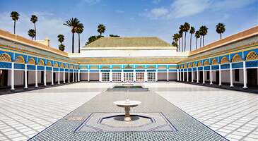 Fas&rsquo;ın en g&ouml;zde turistik noktalarından biri olan Marakeş, gelenekselin modern mimariyle birleşimi konusunda nadide bir &ouml;rnek. Her gezginin ilgisini &ccedil;ekebilecek destinasyonlara sahip olan Marakeş, UNESCO D&uuml;nya Mirası Listesi'nde yer alan Medina b&ouml;lgesi dışında birbirinden renkli bah&ccedil;eleri, otantik &ccedil;arşıları ve g&ouml;rkemli sarayları ile dikkat &ccedil;ekiyor. Bahia Sarayı&rsquo;ndan Zagora&rsquo;ya, Majorelle Bah&ccedil;eleri&rsquo;nden Jemaa el-Fnaa Meydanı&rsquo;na kadar her noktada Marakeş&rsquo;i ayrıcalıklı kılan detaylarla karşılaşabilirsin. Vizesiz olmasıyla da ilgi g&ouml;ren &uuml;lkenin incisi Marakeş&rsquo;te gezilecek yerleri keşfetmeye başla. 1. Bahia Sarayı Marakeş şehrinde g&ouml;r&uuml;lmesi gereken yerlerin başında ihtişamıyla g&ouml;renleri b&uuml;y&uuml;leyen Bahia Sarayı geliyor. Şehrin ikonik yapılarından olan tarih&icirc; saray, 19. y&uuml;zyılda inşa edilen g&ouml;rkemli yapılar arasında bulunuyor. Arap&ccedil;ada &ldquo;Bahia&rdquo; s&ouml;zc&uuml;ğ&uuml; parlaklık ya da g&uuml;zellik manasında kullanılıyor. Sarayın estetik dokusu, bu anlamı fazlasıyla karşılıyor. Sultan Abd&uuml;laziz&rsquo;in veziri Si Moussa tarafından yaptırılan bu g&ouml;rkemli sarayın &ouml;zellikle de Bou Ahmed d&ouml;neminde genişletildiği g&ouml;r&uuml;l&uuml;yor. Fas mimarisi haricinde genel olarak End&uuml;l&uuml;s ve Osmanlı tarzlarının kendine yer bulduğu saray, yaklaşık 8 hektarlık bir alanı kaplıyor. Avlu b&ouml;l&uuml;m&uuml;nde &ouml;zellikle de mermer d&ouml;şemelerinin ve oymalı ahşap tavanlarının &ouml;ne &ccedil;ıktığı s&ouml;ylenebilir. Devasa sarayda toplamda 160 oda bulunuyor. Bu odaların dışında i&ccedil; bah&ccedil;eler ve avlular da ziyaret edilebiliyor. Tavan s&uuml;slemelerinin sedir ağacından yapılması saraya bambaşka bir g&uuml;zellik kazandırıyor. İ&ccedil; bah&ccedil;elerde turun&ccedil; ağa&ccedil;ları, yaseminler ve s&uuml;s havuzları, huzur dolu bir ambiyans yaratıyor. Sarayın aktif olarak kullanıldığı d&ouml;nemlerde Fas kraliyet ailesinin resmi konuklarını ağırladığı biliniyor. Bu arada Nastassia Kinski imzalı Harem filminin de burada &ccedil;ekildiğini anımsatalım. Konum Linki {calismasaatleri}Giriş &uuml;creti Kişi başı 100 MAD A&ccedil;ık olduğu saatler Her g&uuml;n 09.00 ile 17.00 saatleri arasında ziyaret edilebilir.{/calismasaatleri} {insightBoxStart}Yazar Notu: Sarayın i&ccedil;inde rehberli bir tur almak, buradaki odaların ve ge&ccedil;mişte kimlerin burada yaşadığının hikayesini daha iyi anlamanı sağlayabilir.{insightBoxEnd} 2. Dar Si Said M&uuml;zesi Marakeş&rsquo;in en eski ve etkileyici m&uuml;zelerinden biri sayılan Dar Si Said M&uuml;zesi, şehrin k&uuml;lt&uuml;rel mirasına ışık tutuyor. M&uuml;zeye ev sahipliği yapan bina, 19. y&uuml;zyılda Sultan II. Hasan&rsquo;ın veziri Si Said bin Musa&rsquo;nın girişimleri neticesinde inşa edilmiş. M&uuml;zeyi dolaştığında &ouml;zellikle geleneksel Fas halıları ve ahşap oymacılığına dair koleksiyonlar ilgini &ccedil;ekebilir. Reng&acirc;renk zellij &ccedil;inileri, zarif ahşap işlemeleri ve sıva s&uuml;slemeleriyle dikkat &ccedil;eken m&uuml;ze, Fas&rsquo;ın el sanatları geleneğini başarılı bir şekilde tanıtıyor. M&uuml;zenin farklı kısımlarında antik d&ouml;nemlerden kalan silahlar, m&uuml;cevherler, seramikler ve el yapımı mobilyalar sergileniyor. Gelinlerin d&uuml;ğ&uuml;nlerde giydiği g&ouml;sterişli geleneksel kıyafetler ve Berberi k&uuml;lt&uuml;r&uuml;ne ait sanat eserleri, ziyaret&ccedil;ilerden tam not almayı başarıyor. G&uuml;nl&uuml;k hayatta ve t&ouml;renlerde kullanılan birbirinden değerli eserlerin sunulduğu Dar Si Said M&uuml;zesi, şehir merkezinde konumlanıyor. Konum Linki {calismasaatleri}Giriş &uuml;creti Kişi başı 30 MAD A&ccedil;ık olduğu saatler &nbsp;Her g&uuml;n 10.00 ile 18.00 saatleri arasında ziyaret edilebilir.{/calismasaatleri} 3. Majorelle Bah&ccedil;eleri Marakeş&rsquo;in en sakin k&ouml;şelerinden olan Majorelle Bah&ccedil;eleri&rsquo;nin hik&acirc;yesi bizi 1920&rsquo;li yıllara g&ouml;t&uuml;r&uuml;yor. Bu b&uuml;y&uuml;leyici ve orijinal bah&ccedil;e, tropikal bitkiler, egzotik &ccedil;i&ccedil;ekler ve rengarenk binalarla dolu. Bah&ccedil;ede b&uuml;y&uuml;k oranda canlı mavi tonlarının kullanıldığını s&ouml;yleyebiliriz. Her k&ouml;şede egzotik bir bitki t&uuml;r&uuml;ne rastlayabileceğin Majorelle Bah&ccedil;eleri, sadece bitkilerle değil, aynı zamanda ilgin&ccedil; su elementleriyle de dikkat &ccedil;ekmeyi başarıyor. Majorelle Bah&ccedil;eleri&rsquo;nde su havuzları ve şelaleler dışında k&uuml;&ccedil;&uuml;k k&ouml;pr&uuml;ler de farklı noktalara dağılmış durumda. Eşsiz bir g&ouml;r&uuml;n&uuml;m sunan bah&ccedil;e, bilhassa fotoğraf tutkunları i&ccedil;in olduk&ccedil;a elverişli. Tasarım s&uuml;reci Fransız ressam Jacques Majorelle tarafından y&uuml;r&uuml;t&uuml;len Majorelle Bah&ccedil;eleri&rsquo;nde kakt&uuml;sler, bambular palmiye ağa&ccedil;ları ve su bitkileri ağırlıkta. 1970&rsquo;lerin sonlarına doğru bakımsız kalan bah&ccedil;eler, b&uuml;y&uuml;k bir restorasyon neticesinde yeniden ziyaret&ccedil;ilerle buluşmuş. Konum Linki {insightBoxStart}Yazar Notu: Bah&ccedil;ede dolaşırken mutlaka ikonik kobalt mavisi duvarların &ouml;n&uuml;nde fotoğraf &ccedil;ekmelisin. Burası Marakeş&rsquo;in sosyal medya paylaşımları a&ccedil;ısından en uygun noktalarından.{insightBoxEnd} 4. Jemaa el-Fnaa Meydanı Jemaa el-Fnaa Meydanı, Marakeş&rsquo;in tam anlamıyla kalbinde yer alıyor. Şehrin en g&uuml;&ccedil;l&uuml; simgelerinden biri olan Jemaa el-Fnaa Meydanı, g&uuml;n&uuml;n her saatinde m&uuml;thiş bir kalabalığa sahip. G&uuml;nd&uuml;zleri genellikle meydanda tezgah a&ccedil;an satıcılar, geleneksel el sanatlarıyla ilgilenen zanaatk&acirc;rlar ve falcılar, burayı epey renklendiriyor. Akşama doğru meydan bambaşka bir atmosfere b&uuml;r&uuml;n&uuml;yor. Kafelerin, restoranların dolup taştığı bu saatlerde seyyar satıcılar ve sokak g&ouml;sterileri yapan kişiler yoğunluk kazanıyor. Meydandaki satıcılar, Marakeş&rsquo;in pek &ccedil;ok sokak lezzetini tezgahlara yansıtıyor. Bu arada meydan sadece kafe ve restoranlardan ibaret değil. Meydanın hemen &ccedil;evresinde &ccedil;ok sayıda tarih&icirc; yapı da mevcut. Bunlar arasında &ouml;zellikle Koutoubia Camii olduk&ccedil;a pop&uuml;ler. UNESCO tarafından korumaya alınan bu &uuml;nl&uuml; meydan, klasik bir şehir meydanından ziyade tarih&icirc; dokusunu kaybetmeyen b&uuml;y&uuml;k bir pazaryeri havasında. Bu y&ouml;n&uuml;yle aslında Jemaa el-Fnaa Meydanı&rsquo;nın, Marakeş&rsquo;in ruhunu en iyi yansıtan yerlerin başında olduğunu s&ouml;ylemek m&uuml;mk&uuml;n. Konum Linki 5. Murabıt Kubbesi 12. y&uuml;zyılda Berberi h&uuml;k&uuml;mdarları tarafından inşa edilen Murabıt Kubbesi, şehrin en karakteristik yapılarından biri. Uzun yıllar boyunca bir t&uuml;r tapınak olarak işlev g&ouml;ren Murabıt Kubbesi, mimari ve tarih&icirc; a&ccedil;ıdan g&ouml;r&uuml;lmeye değer. Aktif olarak kullanıldığı d&ouml;nemlerde b&ouml;lgedeki dini liderlerin buluşmasına ev sahipliği yapmış olan kubbenin etrafında son derece zarif işlemeler ve detaylar mevcut. Şehirdeki pek &ccedil;ok tarih&icirc; yapı ile i&ccedil; i&ccedil;e olan Murabıt Kulesi, &ouml;zellikle İslami ve Berberi k&uuml;lt&uuml;rlerinin harmanlandığı bir yapı olmasından dolayı epey &ouml;nemseniyor. 1117 yılında inşa edildiği aktarılan kubbe, şehrin erken d&ouml;nemlerine ışık tutuyor. Bu arada Murabıt Kubbesi&rsquo;nin Marakeş&rsquo;teki hanedanlık d&ouml;nemini yansıtan tek yapı olduğunu da anımsatalım. Zaman i&ccedil;inde &ccedil;evresi modern yapılarla dolsa da kubbe dokusunu b&uuml;y&uuml;k oranda koruyor. Konum Linki 6. Menara Bah&ccedil;eleri Marakeş&rsquo;in en ikonik yeşil alanlarından olan Menara Bah&ccedil;eleri, genellikle Majorelle Bah&ccedil;eleri ile kıyaslanıyor. Sakin ve huzur dolu bir atmosfere sahip olan bu yerin tarihi, 12&rsquo;nci y&uuml;zyıla dek uzanıyor. O d&ouml;nemlerde yazlık saraylarının etrafını &ccedil;evreleyen &ouml;zel bir alan olarak da kullanılan Menara Bah&ccedil;eleri, Atlas Dağları&rsquo;ndan oluşan harika biri manzaraya sahip. Bah&ccedil;enin hemen orta kısmında 500 yıllık ge&ccedil;mişi olan dev bir s&uuml;s havuzu yer alıyor. Yaz aylarında bu havuzun varlığı, serin bir ortam yaratıyor. Menara Bah&ccedil;eleri&rsquo;nde dikkat &ccedil;eken bir diğer yapı ise Osmanlı tarzı bir &ccedil;atıya sahip olan tarih&icirc; pavyon. Suyun yansıması sayesinde burada harika kareler yakalamak m&uuml;mk&uuml;n. Halife Abd al-Mu-min tarafından oluşturulan bah&ccedil;e, &ouml;zellikle de zeytin ağa&ccedil;larıyla &ouml;ne &ccedil;ıkıyor. Menara Bah&ccedil;eleri, yıl boyunca &uuml;cretsiz olarak ziyaret edilebiliyor. Konum Linki 7. Marakeş M&uuml;zesi Şehrin en dikkat &ccedil;eken k&uuml;lt&uuml;rel zenginliklerinden olan Marakeş M&uuml;zesi, 1997 senesinden bu yana hizmet veriyor. Yerel sanat&ccedil;ılardan ve Marakeş&rsquo;in uzun tarihinden yansımalar sunmayı ama&ccedil;layan m&uuml;ze, hem kalıcı hem de ge&ccedil;ici sergilere ev sahipliği yapıyor. Geleneksel Fas halıları, seramikler, minyat&uuml;rler ve el yazmalarını b&uuml;nyesinde barındıran Marakeş M&uuml;zesi, Fas&rsquo;ın farklı b&ouml;lgelerinden gelen halk sanatlarına ayna tutuyor. M&uuml;zenin her bir noktasında farklı bir sanat formuna tanıklık edebilirsin. &Ouml;zellikle geleneksel sanatlara ilgin varsa Marakeş M&uuml;zesi seni epey etkileyebilir. 1800&rsquo;l&uuml; yıllardan kalma Dar Menebi Sarayı'nda yer alan m&uuml;zede tarih&icirc; kitaplardan eski madeni paralara kadar pek &ccedil;ok koleksiyon seni bekliyor. Konum Linki {calismasaatleri}Giriş &uuml;creti Kişi başı 100 MAD A&ccedil;ık olduğu saatler Her g&uuml;n 09.30 ile 18.00 saatleri arasında ziyaret edilebilir.{/calismasaatleri} 8. Sahabe Mezarları Marakeş&rsquo;teki dini mirası anlamak adına Sahabe Mezarları iyi bir fırsat sayılıyor. Şehir merkezinin dışında konumlanan Sahabe Mezarları, erken d&ouml;nemde İslam'ın yayıldığı ve sahabelerin şehit olduğu yerlerden biri olarak kabul g&ouml;r&uuml;yor. Bilhassa da Emevi ve Abb&acirc;si d&ouml;nemlerinde yaşamış olan bir&ccedil;ok sahabe burada yer alıyor. Sahabe Mezarları aynı zamanda ilgin&ccedil; yapı detaylarıyla da dikkat &ccedil;ekiyor. Farklı zaman dilimlerinden kalma taş yapıları ve mezarları, buraya g&ouml;rsel a&ccedil;ıdan farklı bir boyut kazandırıyor diyebiliriz. 1917 yılında tesad&uuml;fen keşfedilen bu yer, Sahabe Hanedanlığı&rsquo;na ait 60 farklı mezara ev sahipliği yapıyor. Mezarların en &ccedil;ok bilineni ve ziyaret edileni ise Sultan Ahmad al-Mansur ve ailesine ait. Bu mezar, &ldquo;On İki Kolon Salonu&rdquo; adıyla biliniyor.&nbsp; Konum Linki {calismasaatleri}Giriş &uuml;creti &Uuml;cretsiz A&ccedil;ık olduğu saatler Sahabe Mezarları&rsquo;na giden otob&uuml;sler sabah 10.00 ve akşam 22.00 arasında faaliyet g&ouml;steriyor..{/calismasaatleri} 9. Ali Bin Yusuf Medresesi Fas&rsquo;ın en k&ouml;kl&uuml; medreselerinden biri olan Ali Bin Yusuf Medresesi&rsquo;nin 14&rsquo;&uuml;nc&uuml; y&uuml;zyılda inşa edildiği biliniyor. Meriniler d&ouml;neminden&nbsp; miras kalan bu tarih&icirc; medrese, aktif olarak kullanıldığı yıllarda olduk&ccedil;a m&uuml;him bir eğitim merkezi olarak g&ouml;r&uuml;l&uuml;yordu. Marakeş&rsquo;in tarih&icirc; merkezine yakın bir konumda olan Ali Bin Yusuf Medresesi, i&ccedil; avlusu ve &ccedil;evresini saran odalarla ziyaret&ccedil;ilerini karşılıyor. Arap İslam mimarisinin klasik &ouml;zelliklerini yansıtan medrese, duvarları ve tavanlarıyla da dikkat &ccedil;ekici olmayı başarıyor. Bir d&ouml;nem, İslam bilimlerinin ve felsefesinin &ouml;ğretildiği bir merkez olan tarih&icirc; mekanda aynı zamanda &ouml;nemli alimlerin de eğitim aldığı aktarılıyor. G&uuml;n&uuml;m&uuml;zde Ali Bin Yusuf Medresesi, aktif bir ibadet alanı olarak kullanılmıyor ancak turistler tarafından sıklıkla ziyaret edilebiliyor. Medreseye geldiğinde nadir kitaplar, el yazmaları ve İslam bilimlerine dair eserlere de rastlayabilirsin. Konum Linki 10. Yves Saint Laurent M&uuml;zesi D&uuml;nya &ccedil;apında bilinen Fransız moda tasarımcısı Yves Saint Laurent&rsquo;ın mirasını taşıyan bu &ccedil;ok &ouml;zel m&uuml;ze, 2017 senesinden bu yana ziyarete a&ccedil;ık. &Ouml;zellikle de moda severler ve tasarım d&uuml;nyasına ilgi duyan kişilerin y&ouml;neldiği m&uuml;zede &uuml;nl&uuml; ressamın yaşamına ya da eserlerine dair &ccedil;ok fazla detay bulabilirsin. Modern ve etkileyici bir tasarıma sahip olan m&uuml;zede Yves Saint Laurent&rsquo;in en &uuml;nl&uuml; koleksiyonları, kıyafetleri ve tasarımları kendine yer buluyor. &Ccedil;izimler, &ouml;zel &ccedil;alışmalar, notlar, fotoğraflar, &ouml;zel kitap ve kaynaklar, m&uuml;zenin diğer eserlerini oluşturuyor. Modanın kreatif s&uuml;recine dahil olabileceğin m&uuml;zede ufak bir k&uuml;t&uuml;phane de bulunuyor. M&uuml;zenin meşhur Majorelle Bah&ccedil;eleri&rsquo;ne y&uuml;r&uuml;me mesafesinde olması, turistik gezilerde burayı cazip bir durak haline getiriyor. Konum Linki {calismasaatleri}Giriş &uuml;creti &nbsp;Kişi başı 220 MAD A&ccedil;ık olduğu saatler Her g&uuml;n 10.00 ile 18.00 saatleri arasında ziyaret edilebilir.{/calismasaatleri} {{campaignsSlider}} 11. Ait Ben Haddou Marakeş&rsquo;in yaklaşık 30 kilometre g&uuml;neydoğusunda konumlanan Ait Ben Haddou, tarih&icirc; bir kale k&ouml;y&uuml; olarak tanımlanabilir. Turistlerin sene boyunca b&uuml;y&uuml;k ilgi g&ouml;sterdiği bu otantik destinasyon, UNESCO D&uuml;nya Mirası Listesi'nde yer alıyor. Hem geleneksel Fas mimarisini hem de b&uuml;y&uuml;leyici &ccedil;&ouml;l manzarasını keşfetmek adına iyi bir fırsat sunan Ait Ben Haddou, toprak rengindeki surları ile fark yaratıyor. Ayıca geleneksel mud&eacute;jar tarzı yapıları yakından g&ouml;rmek i&ccedil;in de k&ouml;ye y&ouml;nelebilirsin. Bu arada Ait Ben Haddou&rsquo;nun uzun zamandan bu yana sinema d&uuml;nyasının g&ouml;zde mekanlarından biri olduğunu da s&ouml;ylemeliyiz. Pek &ccedil;ok pop&uuml;ler yapım i&ccedil;in doğal bir plato olan Ait Ben Haddou, &ouml;zellikle de Game of Thrones dizisi &ouml;zelinde &ccedil;ekilen sahneleriyle &uuml;nl&uuml;. Aynı şekilde Gladyat&ouml;r ve Lawrence of Arabia filmlerini de belli sahneleri burada &ccedil;ekildi. G&uuml;n&uuml;m&uuml;zde k&ouml;y i&ccedil;inde sadece 4 aile yaşıyor. Ait Ben Haddou'yu gezmek adına genellikle rehberli turlar tercih ediliyor. Konum Linki {insightBoxStart}Yazar Notu: Ait Ben Haddou'yu ziyaret etmek i&ccedil;in en uygun zaman bahar ve sonbahar ayları. Zira yazın sıcaklıklar olduk&ccedil;a y&uuml;ksek olabiliyor. Bu gerek&ccedil;eyle sabah erken saatlerde veya akşam&uuml;st&uuml; gezmeyi tercih edebilirsin.{insightBoxEnd} 12. El Badi Sarayı Marakeş&rsquo;te 16. y&uuml;zyıldan g&uuml;n&uuml;m&uuml;ze taşınan yapılardan biri de El Badi Sarayı. Sultan Ahmed al-Mansour tarafından 1578 senesinde yaptırılan saray, hala şehrin en &ouml;zel yapıları arasında g&ouml;steriliyor. Arap&ccedil;ada &ldquo;badi&rdquo; s&ouml;zc&uuml;ğ&uuml; eşsiz g&uuml;zellik anlamında kullanılıyor. El Badi Sarayı aslında ilk yapıldığı d&ouml;nemin en b&uuml;y&uuml;k yapılarından biri olsa da zaman i&ccedil;inde belli &ouml;l&ccedil;&uuml;de tahribata uğramış. D&ouml;nemin zenginliğini başarılı bir şekilde yansıtan sarayda l&uuml;ks taşlar ve mermerler dikkat &ccedil;ekici. Zamanla bir&ccedil;ok değerli eşya ve s&uuml;slemenin farklı fetihler sonucunda kaybolduğu s&ouml;yleniyor. Bu arada saray ve &ccedil;evresinde yapılan arkeolojik kazılarda da pek &ccedil;ok bulguya rastlanmış. Ge&ccedil;mişin izlerini hala saklamayı başaran El Badi Sarayı&rsquo;nın ilk yapıldığı d&ouml;nemlerde 360 odası bulunduğu belirtiliyor. &Ouml;nemini Saadi Hanedanı'nın &ccedil;&ouml;k&uuml;ş&uuml;yle beraber kaybetmeye başlayan tarih&icirc; saray, her ne kadar eski ihtişamından uzak olsa da sık sık ziyaret ediliyor. El Badi Sarayı&rsquo;nı &uuml;cretsiz bir şekilde ziyaret edebilirsin. Konum Linki 13. Koutoubia Camii Şehrin merkezinde olan Koutoubia Camii, şehrin genel sil&uuml;etinde olduk&ccedil;a dikkat &ccedil;ekici bir yere sahip. 1100&rsquo;l&uuml; yıllarda Almohad Sultanı Yusuf el-Mansur tarafından yaptırılan tarih&icirc; cami, zarif minaresiyle hayranlık uyandırıyor. Minare, 77 metre y&uuml;ksekliği ile şehrin pek &ccedil;ok noktasından g&ouml;r&uuml;lebiliyor. Koutoubia Camii, "kitap&ccedil;ıların camisi&rdquo; olarak biliniyor. B&ouml;yle anılmasının nedeni ise camiye yakın olan yerlerde kitap ve el yazmaları satan d&uuml;kk&acirc;nların yoğun olması. Cami, pop&uuml;ler bir meydan olan Jemaa el-Fnaa Meydanı&rsquo;na y&uuml;r&uuml;me mesafesinde. Almohad Hanedanı d&ouml;nemine ait bir eser olan Koutoubia Camii&rsquo;nin &ccedil;evresinde geniş yeşil alanlar ve portakal alanları mevcut. Konum Linki 14. Atlas Dağları Fas'ın g&uuml;neyinde olan Atlas Dağları, &uuml;lkenin en y&uuml;ksek dağ sıralarını oluşturuyor. Şehrin ikliminde ve doğal &ccedil;eşitliliğinde kritik bir role sahip olan Atlas Dağları, Atlas Okyanusu'ndan Akdeniz'e kadar uzanıyor. Atlas Dağları aynı zamanda Batı Afrika'yı Orta Afrika'dan ayıran bir sınır işlevine sahip. Her ne kadar şehir merkezinin uzağında olsa da Marakeş&rsquo;e kadar gelmişken bu heybetli dağları ziyaret edebilirsin. Doğa tutkunları ve dağcıları i&ccedil;in Atlas Dağları her daim pop&uuml;ler bir durak olarak g&ouml;r&uuml;l&uuml;yor. Toubkal Dağı, Atlas Dağları&rsquo;nın en y&uuml;ksek noktasını meydana getiriyor. Burası 4167 metrelik y&uuml;ksekliğiyle &uuml;lkenin en y&uuml;ksek dağı olarak ge&ccedil;iyor. Dağ sıraları, trekking turları haricinde kayak, dağcılık, fotoğraf&ccedil;ılık ya da kamp&ccedil;ılık gibi aktiviteler i&ccedil;in elverişli bir ortam sunuyor. Bu arada yukarıda s&ouml;z ettiğimiz Ait Ben Haddou da Atlas Dağları&rsquo;na epey yakın bir turistik destinasyon. Konum Linki {insightBoxStart}Yazar Notu: Dağ k&ouml;ylerinde yerel Berberi halkıyla tanışıp geleneksel nane &ccedil;ayı i&ccedil;me fırsatı bulabilirsin.{insightBoxEnd} 15. Palmerye &Uuml;lkenin g&uuml;neydoğusundan bulunan Palmerye, şehir merkezinin dışında bulunuyor. UNESCO D&uuml;nya Mirası Listesi'nde kendine yer bulan bu yer, olduk&ccedil;a sıcak ve kuru iklimiyle tanınıyor. &Ccedil;evresindeki yeşil alanlar ve palmiye ağa&ccedil;larıyla &ccedil;&ouml;l atmosferinin tam aksi bir g&ouml;r&uuml;nt&uuml; sunan Palmerye, aynı zamanda tarih&icirc; k&ouml;yleri ve geleneksel yaşam bi&ccedil;imiyle de &ouml;n plana &ccedil;ıkıyor. Palmerye, &ldquo;vaha&rdquo; anlamında kullanılıyor. Şehir merkezinden bir nebze uzaklaşmak ve &ccedil;&ouml;l peyzajına tanıklık etmek adına Palmerye&rsquo;yi g&ouml;rebilirsin. Burası turistik bir yer olduğu i&ccedil;in &ccedil;ok fazla konaklama se&ccedil;eneği ile karşılaşabilirsin. Eski &ccedil;&ouml;l yollarında uzun y&uuml;r&uuml;y&uuml;şler yapmak, develerle gezintiler yapmak, &ccedil;&ouml;l manzaralarından oluşan fotoğraflar &ccedil;ekmek, &ldquo;ksar&rdquo; adı verilen kaleleri ziyaret etmek ya da ATV s&uuml;r&uuml;şlerini deneyimlemek, Palmerye&rsquo;deki pop&uuml;ler aktiviteler arasında yer alıyor. Konum Linki {insightBoxStart}İpu​cu: ENUYGUN&rsquo;dan kolayca u&ccedil;ak bileti alabilir, dilediğin yeri uygun fiyatlarla keşfedebilirsin. Şimdi seyahatinin ilk adımı olan Marakeş u&ccedil;ak bileti almak i&ccedil;in tıkla.{insightBoxEnd} {flight_search_form_banner} 16. Agdal Bah&ccedil;eleri Marakeş, g&ouml;z alıcı şehir bah&ccedil;eleriyle biliniyor. Yukarıda s&ouml;z ettiğimiz Majorelle Bah&ccedil;eleri ve Menara Bah&ccedil;eleri haricinde Agdal Bah&ccedil;eleri&rsquo;ne de dikkat &ccedil;ekmek gerekiyor. 12. y&uuml;zyılda Berberi h&uuml;k&uuml;mdarı Ali ibn Yusuf tarafından kurulan Agdal Bah&ccedil;eleri, genel itibarıyla End&uuml;l&uuml;s ve Mısır tarzlarının birleşimi olarak karşımıza &ccedil;ıkıyor. Şehrin g&uuml;neydoğusundaki tabiat g&uuml;zelliği, dev su yolları ve palmiye ağa&ccedil;ları ile ziyaret&ccedil;ilerini karşılıyor. Agdal Bah&ccedil;eleri&rsquo;nin i&ccedil; b&ouml;l&uuml;mlerindeki &ouml;zel y&uuml;r&uuml;me yolları sayesinde Fas bah&ccedil;eciliğinin geleneksel &ouml;rneklerinin keyfini &ccedil;ıkarabilirsin. Zeytin ağa&ccedil;ları, nar ağa&ccedil;ları ve &uuml;z&uuml;m bağları, Agdal Bah&ccedil;eleri&rsquo;nde &ouml;nemli bir alanı kaplıyor. Bah&ccedil;enin &ccedil;ok yakınında Agdal Sarayı isimli tarih&icirc; yapı da ziyaret edilebiliyor. Agdal Bah&ccedil;eleri, toplamda 400 hektarlık bir alana yayılıyor. Bu arada bah&ccedil;e alanında b&uuml;y&uuml;k bir su rezervuarı da mevcut. Su rezervuarı, hem sulama sisteminde hem de balık yetiştiriciliğinde kullanılıyor. Konum Linki 17. Zagora Atlas Dağları'nın eteklerinde yer alan Zagora, tarih&icirc; ve turistik bir kasaba olarak biliniyor. &Ccedil;&ouml;l manzaraları ve geleneksel Berberi k&uuml;lt&uuml;r&uuml;n&uuml; bir arada sunmasından dolayı b&uuml;y&uuml;k ilgi g&ouml;ren Zagora&rsquo;nın tarihi y&uuml;zlerce yıl &ouml;ncesine dayanıyor. Zagora, konum olarak Sahra &Ccedil;&ouml;l&uuml;&rsquo;ne epey yakın. Macera ruhlu gezginler, &ccedil;&ouml;l safarisi yapmak adına burayı sık&ccedil;a tercih edebiliyor. &Ouml;zellikle de &ccedil;&ouml;l&uuml;n gizemli derinliklerine gitmeye karar verenler i&ccedil;in Zagora&rsquo;daki rehberli turları değerlendirebiliyor. Ge&ccedil;miş yıllarda Zagora, t&uuml;ccarların ge&ccedil;erken dinlenebilecekleri bir yer olarak g&ouml;r&uuml;l&uuml;yormuş. Bu arada &ldquo;Zagora&rsquo;daki 52 g&uuml;n&rdquo; ya da orijinal haliyle &ldquo;Tombouctou 52 jours&rdquo; yazılı tabelanın başlangı&ccedil; noktası. Zagora&rsquo;daki bu durak, 52 g&uuml;n s&uuml;ren uzun ve macera dolu bir y&uuml;r&uuml;y&uuml;ş yolunu ifade ediyor. Dilersen, Atlas Dağları&rsquo;nın hemen ardında deveyle seyahat ederek kum tepelerine ulaşabilirsin. Ayrıca Zagora i&ccedil;inde &ccedil;ok sayıda &uuml;cretli kamp alanları da mevcut. Konum Linki 18. Marakeş Tabakhanesi Marakeş&rsquo;e kadar gelmişken buranın meşhur tabakhanelerini ziyaret etmeden d&ouml;nmemelisin. Marakeş Tabakhanesi, &uuml;lkenin en eski tabakhanesi olarak biliniyor. Geleneksel deri işleme tesisinin tarihi 11&rsquo;inci y&uuml;zyıla dek uzanıyor. Tabakhanedeki yoğun işg&uuml;c&uuml; ve &ccedil;eşitli doğal maddelerle yapılan işlemler baş d&ouml;nd&uuml;r&uuml;c&uuml; cinsten. Burada deriler &ccedil;oğunlukla inek, koyun ve ke&ccedil;i gibi hayvanlardan elde ediliyor. Sonraki aşamalarda ise &ccedil;eşitli renklerde boyanarak geleneksel deri eşyalarına d&ouml;n&uuml;şt&uuml;r&uuml;l&uuml;yor. Tabakhanede, derilerin g&uuml;neşte kurutulması ve boyanması i&ccedil;in b&uuml;y&uuml;k ve sığ havuzlar da mevcut. Bu işlemlerin hala geleneksel olarak s&uuml;rd&uuml;r&uuml;lmesi olduk&ccedil;a ilgi &ccedil;ekici. Dolayısıyla turistler i&ccedil;in burası otantik bir destinasyon olarak değerlendiriliyor. Marakeş Tabakhanesi&rsquo;nde g&uuml;n i&ccedil;inde &ccedil;ok sayıda &ccedil;anta, ayakkabı, c&uuml;zdan ve kemer &uuml;retiliyor. Burada işlenmiş deri &uuml;r&uuml;nlerinin satıldığı ufak bir d&uuml;kkan da yer alıyor. Marakeş Tabakhanesi&rsquo;nden sevdiklerin i&ccedil;in bazı hediyelik eşyalar satın alabilirsin. Konum Linki 19. Souk Semmarine Şehrin Medina b&ouml;lgesinin en meşhur &ccedil;arşılarından olan Souk Semmarine, Marakeş&rsquo;in renkli ve canlı ticaret hayatını yansıtıyor. &Ccedil;arşı, ismini Arap&ccedil;adaki &ldquo;semmar&rdquo; s&ouml;zc&uuml;ğ&uuml;nden alıyor. S&ouml;zc&uuml;k, Arap&ccedil;ada kumaş ticareti yapan esnaflar i&ccedil;in kullanılıyor. Geleneksel el sanatları ve tekstil &uuml;r&uuml;nleri haricinde Fas&rsquo;la &ouml;zdeşleşen hediyelik eşyaları b&uuml;nyesinde barındıran Souk Semmarine&rsquo;nin her k&ouml;şesi rengarenk. İpek ve pamuklu &uuml;r&uuml;nler, halılar, ince iş&ccedil;ilikle &uuml;retilen kumaşlar, &ccedil;arşıdaki tezg&acirc;hların b&uuml;y&uuml;k bir &ccedil;oğunluğunu oluşturuyor. Bilhassa Berberi ve Fas geleneksel halılarını yakından g&ouml;rmek ya da satın almak adına Souk Semmarine, iyi bir fırsat sunuyor. Tarih&icirc; &ccedil;arşının olduğu yer, şehrin en işlek caddelerinden birine epey yakın. Bu nedenle de yıl boyunca capcanlı ve kalabalık bir ortamla karşılaşabilirsin. Ayrıca Souk Semmarine&rsquo;nin &ccedil;ıkışı Baharat Meydanı ile birleşiyor. &Ccedil;arşıda yer alan sokakların &ccedil;oğu trafiğe kapalı olduğu i&ccedil;in g&uuml;venli bir şekilde alışverişin tadını &ccedil;ıkarabilirsin. Konum Linki {insightBoxStart}Yazar Notu: Sevdiklerin i&ccedil;in ilgin&ccedil; geleneksel hediyeler arıyorsan, şehre &ouml;zg&uuml; kil pişirme kapları olarak bilinen taginleri değerlendirebilirsin.{insightBoxEnd} 20. Marakeş Tren İstasyonu Şehrin ulaşım altyapısının &ouml;nemli bir par&ccedil;ası olarak g&ouml;r&uuml;len Marakeş Tren İstasyonu, şehrin batı b&ouml;l&uuml;m&uuml;nde yer alıyor. Tarih&icirc; kimliğine rağmen modern mimarisiyle de g&ouml;z dolduran istasyon, &ldquo;Train a Grande Vitesse&rdquo; adıyla bilinen hızlı tren seferlerinin başlangı&ccedil; noktası. Marakeş &uuml;zerinden Fas&rsquo;ın pek &ccedil;ok pop&uuml;ler şehrine buradaki hızlı trenlerle kolayca ulaşabilirsin. Turistler &ouml;zellikle Kazablanka, Fes ve Rabat gibi sevilen şehirlere gitmek adına istasyonu kullanıyor. İstasyonda yolculuk &ouml;ncesi veya sonrası dinlenebileceğin &ccedil;eşitli kafe ve restoranlar mevcut. 1923 senesinde Fransız himayesi d&ouml;nemi eseri olarak inşa edilmiş olan tarih&icirc; tren istasyonu, Kraliyet Tiyatrosu&rsquo;na ve &ccedil;eşitli y&ouml;resel pazarlara y&uuml;r&uuml;me mesafesinde. 2008 yılında buraya yeni bir istasyon binasının daha inşa edilmesi, b&uuml;y&uuml;yen ihtiya&ccedil;ların karşılanmasını sağlıyor. Konum Linki &Uuml;lkenin tamamını keşfetmek istersen Fas&rsquo;ta gezilecek yerler linkine g&ouml;z atmanı &ouml;neririz.&nbsp;