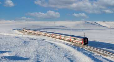 Doğu Ekspresi 2 yıldır gencinden yaşlısına t&uuml;m seyahat severler arasında &ccedil;ok pop&uuml;ler. Senin de mutlaka &ldquo;Ya Doğu Ekspresine mutlaka binmeliyiz ya inanılmaz&rdquo; diyen arkadaşların vardır. Hatta trene binip ışıklarla, mumlarla s&uuml;sledikleri vagonların fotoğraflarını sosyal medyada paylaşan arkadaşların sayesinde sen de gitmiş kadar olmuşsundur. Valla a&ccedil;ık&ccedil;ası ben trene binmeden arkadaşlarım ve sosyal medyanın g&uuml;c&uuml; sağ olsun binmiş kadar oldum. Ankara&rsquo;dan başlayıp Kars&rsquo;ta son bulan bu 24 saatlik yolculuk i&ccedil;in istersen sadece sosyal medyada g&ouml;steriş işi de istersen bir gezginin mutlaka yapması gereken bir seyahat deneyimi de orasını sen bilirsin ama pop&uuml;ler olduğu i&ccedil;in Doğu Ekspresine bilet bulmak &ccedil;ok zor. Ankara&rsquo;dan Kars&rsquo;a ya da Kars&rsquo;tan Ankara&rsquo;ya yolculuk i&ccedil;in bilet bulamazsan ne yapabilirsin gel beraber bakalım. Erzurum&rsquo;a u&ccedil;, Kars&rsquo;a trenle git Yaşadığın şehirden Erzurum&rsquo;a uygun fiyatlı u&ccedil;ak bileti bulursan ka&ccedil;ırma, hemen al. Doğu Ekspresi&rsquo;ne Erzurum&rsquo;dan bilet bulmak daha kolay olabilir &ccedil;&uuml;nk&uuml; trenin ge&ccedil;tiği Kırıkkale, Kayseri, Sivas ve Erzincan&rsquo;dan Erzurum&rsquo;a gitmek isteyen yolcular trenden inince Kars i&ccedil;in yer a&ccedil;ılmış oluyor. Hem ş&ouml;yle d&uuml;ş&uuml;n, Ankara&rsquo;dan trene binip Kars&rsquo;a gitseydin Erzurum&rsquo;u gezemeyecektin. Şimdi bu planla Erzurum&rsquo;da da istediğin kadar vakit ge&ccedil;irebilirsin. Bana sorarsan ş&ouml;yle 2 g&uuml;n&uuml;n&uuml; Erzurum i&ccedil;in ayırman en g&uuml;zeli olur. Eğer kayak yapmayı seviyorsan ilk g&uuml;n Paland&ouml;ken&rsquo;in meşhur pistleri seni bekliyor. Hatta kayak uğruna Erzurum&rsquo;a 3 g&uuml;n bile ayırmak isteyebilirsin. Bence kayak yapmayı sevmiyorsan bile Paland&ouml;ken&rsquo;e gitmelisin. Bir yanda şehir diğer yanda karla &ouml;rt&uuml;l&uuml; dağların manzarasını g&uuml;zel bir kahve ya da &ccedil;ay eşliğinde izlemek &ccedil;ok keyifli oluyor. Kayağın yorgunluğunu atmanın en g&uuml;zel yoluysa Cağ Kebabı yemek. Doğu Ekspresi&rsquo;ne gidenlerden duyduğum kadarıyla tren Erzurum&rsquo;a yaklaşırken sipariş verip mola esnasında alıp yiyorlarmış. Bir&ccedil;ok arkadaşım siparişlerinin soğuk geldiğini ve hi&ccedil; memnun kalmadıklarını s&ouml;ylemişti. Evet belki Ankara&rsquo;dan Kars&rsquo;a yolculuk yapamadın ama Erzurum&rsquo;da sıcak sıcak &ouml;n&uuml;ne gelen Cağ&rsquo;ı keyifle yiyebileceksin. Sonrasında da bir kadayıf dolması&hellip; Vallahi Erzurum&rsquo;a u&ccedil;ak bileti alasım geldi. Erzurum&rsquo;da ge&ccedil;ireceğin 2. g&uuml;n&uuml; ya da tercihine g&ouml;re 3. g&uuml;n&uuml; şehirle b&uuml;t&uuml;nleşmiş &Ccedil;ifte Minareli Medrese, Yakutiye Medresesi, &Uuml;&ccedil; K&uuml;mbetler ve Erzurum Evleri&rsquo;ni g&ouml;rmeye ayırabilirsin. Taşhan&rsquo;a gidip Oltu taşından yapılan hediyelik eşyalardan almayı unutma. Sonra atla Doğu Ekspresi&rsquo;ne Kars yolculuğuna başla. {flight_search_form_banner} Kars&rsquo;a u&ccedil;, Erzurum&rsquo;a trenle git &Ouml;nce Kars&rsquo;a u&ccedil;akla gitmek de Doğu Ekspresi severler arasında pop&uuml;ler. Ankara&rsquo;dan Kars y&ouml;n&uuml;ne bilet bulamayanlar, Kars&rsquo;tan Ankara y&ouml;n&uuml;ne doğru yapıyorlar Doğu Ekspresi yolculuğunu. O y&uuml;zden Kars&rsquo;tan bilet bulmak da biraz zor olabiliyor. Sen bulduysan şanslısın ama bulamazsan da &uuml;z&uuml;lme. &Ouml;nce Kars&rsquo;a uygun fiyatlı u&ccedil;ak biletini buradan al, sonra Kars&rsquo;tan Erzurum&rsquo;a Doğu Ekspresi yolculuğu yaparsın. Kars&rsquo;a aldığın u&ccedil;ak biletiyle Erzurum&rsquo;a alacağın tren biletinin tarihleri arasında 2 g&uuml;n olmalı ki Kars&rsquo;ın tadını tam anlamıyla &ccedil;ıkarabilesin. Paland&ouml;ken gibi Sarıkamış&rsquo;ın kayak merkezi de olduk&ccedil;a meşhur. Hatta Alpler&rsquo;de bulunan &ldquo;kristal kar&rdquo; &ccedil;eşidi T&uuml;rkiye&rsquo;de sadece Sarıkamış&rsquo;ta var. Sarıkamış&rsquo;ta hi&ccedil; kaymadıysan ve kayak keyfini biraz daha uzatmak istersen Kars&rsquo;a 3 g&uuml;n ayırmayı tercih edebilirsin. Eğer kayak konusunda amat&ouml;rsen, Sarıkamış&rsquo;ta amat&ouml;rler i&ccedil;in de pistler bulunuyor. Kars&rsquo;a gidip de Kars&rsquo;ın meşhur kaz dolmasından yemeden d&ouml;n&uuml;lmez. Kaz eti, Kars&rsquo;ta kış sofralarının olmazsa olmazı. Kazlar kar yağdıktan sonra daha lezzetli olduğu i&ccedil;in kış mevsimi, yemek i&ccedil;in en doğru zaman. Kars kaşarı vardı bir de diye d&uuml;ş&uuml;n&uuml;yorsun değil mi? Evet Kars kaşar konusunda da meşhur. Marketlerde Kars kaşarı diye satılanlardan sonra yerinde yiyince eve g&ouml;t&uuml;rmek i&ccedil;in fazla fazla almak isteyebilirsin şimdiden s&ouml;yl&uuml;yorum. Kars&rsquo;taki 1 g&uuml;n&uuml;n&uuml; de gezmeye ayıracaksın tabii. Kars Kalesi ve Ani Harabeleri&rsquo;ne gideceksin ama en g&uuml;zel manzaralar i&ccedil;in &Ccedil;ıldır G&ouml;l&uuml;&rsquo;ne mutlaka gitmelisin. Doğu Ekspresi yolculuğu yapan arkadaşlarım en g&uuml;zel fotoğraflarını kışın donan g&ouml;lde &ccedil;ekmişler zaten. En ilgin&ccedil; g&ouml;r&uuml;nt&uuml;yse, Aynalı Sazan adı verilen balığı tutmak i&ccedil;in buzu kıran balık&ccedil;ılarınki. Balık&ccedil;ıları izleyip fotoğrafladıktan sonra balığın tadına bakmalısın. Tamamen bir buz tabakası haline gelen g&ouml;lde atlı kızak turları da yapılıyor. Kızaklara binersin ya da binmezsin o senin kararın ama trende Erzurum&rsquo;a giderken, &ccedil;ektiğin g&uuml;zel fotoğraflarla sosyal medya hesaplarını s&uuml;sleyebilirsin. &nbsp; Doğu Ekspresi&rsquo;ne Ankara&rsquo;dan bilet bulamazsan alternatifin bol diye yola &ccedil;ıktığım bu yazı, u&ccedil;ak bileti almamla sonu&ccedil;landı. Erzurum&rsquo;a ya da Kars&rsquo;a daha &ouml;nce gittiysen bile b&ouml;yle anlatınca senin de i&ccedil;inden gitmek gelmiştir. O zaman ne yapıyoruz tıklıyoruz, biletlerimizi alıyoruz ve kendi Doğu Ekspresi rotalarımızı &ccedil;iziyoruz değil mi?