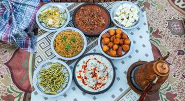 Doğu Anadolu&rsquo;nun sarp dağları ve u&ccedil;suz bucaksız yaylaları ile &ccedil;evrili Hakk&acirc;ri, binlerce yıllık el emeğinin ve doğallığın harmanlandığı eşsiz bir mutfak k&uuml;lt&uuml;r&uuml;ne sahip. B&ouml;lgenin sert iklimi ve temel ge&ccedil;im kaynağı olan hayvancılık, Hakk&acirc;ri gastronomi kimliğini şekillendiriyor. Y&uuml;ksek rakımlı yaylalarda beslenen hayvanların eti, endemik &ccedil;i&ccedil;eklerden s&uuml;z&uuml;len bal ve dağlardan toplanan şifalı otlar, Hakk&acirc;ri sofralarının başrol oyuncuları. Misafirperverliğin bir yaşam bi&ccedil;imi olduğu bu coğrafyada yemekler, sabırla hazırlanan y&ouml;resel lezzetlerden, k&ouml;z ateşinde lezzetlenen etlere kadar her lokmada kadim bir geleneği yaşatıyor. Hakk&acirc;ri&rsquo;de Mezopotamya ve Anadolu etkileşimlerini bir arada g&ouml;rebileceğin pek &ouml;zel lezzetleri keşfedebilirsin. 1. Doğaba Hakk&acirc;ri mutfağının zirve noktası kabul edilen doğaba, şehrin en prestijli lezzetlerinden. Doğaba, sabır ve ustalık gerektiren hazırlık s&uuml;reciyle tam bir &ldquo;imza yemek&rdquo; niteliğinde. Kemikli kuzu eti, d&ouml;vme buğday ve nohutun uyumlu birlikteliği, s&uuml;zme yoğurtla hazırlanan yoğun kıvamlı bir terbiye ile birleşerek damaklarda derin bir iz bırakıyor. Doğaba, genellikle &ouml;zel davetlerin, d&uuml;ğ&uuml;nlerin ve en se&ccedil;kin misafir sofralarının başrol oyuncusu. Bu lezzet, servis edilmeden &ouml;nce &uuml;zerine gezdirilen dağ kekiği kokulu kızdırılmış k&ouml;y tereyağı ile o karakteristik iştah a&ccedil;ıcı g&ouml;r&uuml;n&uuml;m&uuml;ne kavuşuyor. &Ccedil;ok doyurucu ve besleyici olan doğaba, Hakk&acirc;ri&rsquo;nin sert iklimini ve hayvancılık k&uuml;lt&uuml;r&uuml;n&uuml; yansıtan otantik y&ouml;resel tatlardan biri. 2. Kepaye Hakk&acirc;ri mutfağının en zahmetli ve maharet isteyen yemeklerinden biri de kepaye. Bu lezzet, sakatat k&uuml;lt&uuml;r&uuml;n&uuml;n b&ouml;lgedeki en se&ccedil;kin temsilcilerinden. Titizlikle temizlenen işkembe ve bağırsakların i&ccedil;ine kıyma, pirin&ccedil;, ince kıyılmış soğan ve y&ouml;resel baharatlardan oluşan zengin bir har&ccedil; doldurulup dikilmesi ile bu y&ouml;resel lezzet hazırlanıyor. Tescilli Hakk&acirc;ri lezzetlerinden biri olan kepaye, bir nevi Hakk&acirc;ri usul&uuml; dolma sanatı. Kısık ateşte, kendi suyunda uzun s&uuml;re pişirilerek lokum kıvamına getirilen kepaye, &ouml;zellikle kalabalık aile sofralarının ve bayram ikramlarının en sevilen yemeği. Servis tabağında tam bir lezzet ş&ouml;leni sunan bu yemek, doyuruculuğu ve el emeği hazırlanışı ile Hakk&acirc;ri&rsquo;nin geleneksel mutfak mirasının somut bir g&ouml;stergesi. 3. G&uuml;lol Hakk&acirc;ri&rsquo;nin en sade ama en samimi lezzetlerinden biri olan g&uuml;lol, az malzemeyle nasıl bir lezzet ş&ouml;leni yaratılabileceğinin en g&uuml;zel &ouml;rneği. Bu y&ouml;resel yemek, pirin&ccedil; veya d&ouml;vme buğdayın yoğurtlu bir su i&ccedil;erisinde lapa kıvamına gelene kadar ağır ağır pişirilmesiyle hazırlanıyor. G&uuml;lol, sadeliği ile mideyi yormayan bir yapıya sahip. G&uuml;lol yemeğinin ger&ccedil;ek karakteri ise servis aşamasında ortaya &ccedil;ıkıyor. Yemeğin ortasında a&ccedil;ılan &ccedil;ukura b&ouml;lgenin y&uuml;ksek rakımlı yaylalarından gelen ve mis gibi kokan kızdırılmış k&ouml;y tereyağı bolca d&ouml;k&uuml;l&uuml;yor. Hem kahvaltılarda hem de ana &ouml;ğ&uuml;nlerde tercih edilebilen besleyici g&uuml;lol yemeği, Hakk&acirc;ri&rsquo;nin geleneksel mutfak k&uuml;lt&uuml;r&uuml;n&uuml;n pratik bir yansıması. 4. Y&uuml;ksekova kebabı Y&uuml;ksekova kebabı, Hakk&acirc;ri&rsquo;nin Y&uuml;ksekova il&ccedil;esiyle &ouml;zdeşleşen ve şehrin et konusundaki uzmanlığını g&ouml;steren &ouml;zel bir lezzet. Bu kebabı asıl &ouml;zel kılan şey ise y&uuml;ksek rakımlı yaylalarda doğal beslenen hayvanların taze eti ile etin lezzetini per&ccedil;inleyen bol miktardaki kuyruk yağının zırh yardımıyla harmanlanması. Kıyma ve k&uuml;&ccedil;&uuml;k par&ccedil;alı kuşbaşı etin bir arada kullanıldığı bu &ouml;zel karışım, i&ccedil;ine eklenen taze biber, domates ve y&ouml;resel baharatlarla zenginleştirilerek şişlere diziliyor. Ateş &uuml;zerinde ağır ağır pişerken sebzelerin suyuyla &ouml;zleşen etler, lokum gibi yumuşacık bir kıvam kazanıyor. Y&uuml;ksekova kebabı, genellikle k&ouml;zlenmiş sebzeler ve sıcak tırnak pidesi eşliğinde servis ediliyor. 5. Yayık ayranı (Kekikli ve naneli) Hakk&acirc;ri&rsquo;nin y&uuml;ksek rakımlı yaylalarında beslenen hayvanların taze s&uuml;t&uuml;nden elde edilen yoğurtla hazırlanan yayık ayranı, end&uuml;striyel i&ccedil;eceklerden tamamen farklı yoğun kıvamı ile tam bir ferahlık kaynağı. Geleneksel y&ouml;ntemlerle ahşap yayıklarda d&ouml;v&uuml;lerek hazırlanan bu ayranın &uuml;zerine biriken kalın kar beyazı k&ouml;p&uuml;k tabakası, s&uuml;t&uuml;n yağlı ve doğal yapısının en somut g&ouml;stergesi. Hakk&acirc;ri usul&uuml; yayık ayranını asıl &ouml;zel kılan dokunuş ise b&ouml;lgenin sarp dağlarından emekle toplanan taze yaban nanesi veya dağ kekiğinin ayranın i&ccedil;ine bolca eklenmesi. &Ouml;zellikle ağır et yemeklerinin yanında mideyi rahatlatan yayık ayranı, sindirimi kolaylaştıran ve damakta buz gibi bir ferahlık bırakan bir i&ccedil;ecek. {insightBoxStart}İpucu:&nbsp;En iyi otel fiyatlarını tek bir yerde g&ouml;rmek, se&ccedil;eceğin otel hakkında bilgi almak ve saniyeler i&ccedil;inde rezervasyon yapmak i&ccedil;in ENUYGUN'da&nbsp;Hakkari otelleri&nbsp;araştırmasına başlayabilirsin.{insightBoxEnd} {hotel_search_form_banner} 6. Sengeser Hakk&acirc;ri&rsquo;nin en kadim lezzetlerinden olan sengeser, b&ouml;lgenin coğrafi şartlarına g&ouml;re şekillenmiş yaratıcı bir y&ouml;resel lezzet. Bu yemeği farklı kılan en temel unsur ise taze et ve yeşil mercimeğin uyumuna, b&ouml;lgeye has "kurut" adı verilen kurutulmuş yoğurdun eşlik etmesi. Kurut, yemeğe hafif ekşimsi ve karakteristik bir aroma kazandırıyor. Bol soğan ve tereyağında kavrulan kuşbaşı etlerin, kurutun kıvamlı dokusu ile birleşmesi sonucu ortaya &ccedil;ıkan yoğun lezzet, y&uuml;ksek besin değeri ve damakta bıraktığı kalıcı tatla Hakk&acirc;ri sofralarının vazge&ccedil;ilmezi. &Ouml;zellikle kış aylarında i&ccedil; ısıtan bir ana yemek olan sengeser, y&ouml;re halkının geleneksel saklama y&ouml;ntemlerini sofraya nasıl bir ustalıkla taşıdığının en g&uuml;zel kanıtı. 7. Kiriş Hakk&acirc;ri&rsquo;nin zengin i&ccedil;erikli tencere yemeklerinden olan kiriş, &ccedil;ok sayıda malzemenin tek bir kazanda yarattığı lezzet dengesi ile &ouml;ne &ccedil;ıkıyor. Kemikli kuzu eti, nohut ve d&ouml;vme buğdayın temelini oluşturduğu yemeğe Hakk&acirc;ri mutfağının karakteristik dokunuşu olan ceviz i&ccedil;i, kuru &uuml;z&uuml;m veya sumak gibi malzemeler ekleniyor. B&ouml;ylece yemek, kıvam ve hafif mayhoş bir aroma kazanıyor. Malzemelerin birbirine ge&ccedil;mesi i&ccedil;in uzun s&uuml;re kısık ateşte pişirilen kiriş, &uuml;zerine d&ouml;k&uuml;len kızgın tereyağı ve kuru reyhanın yaydığı eşsiz koku ile servis ediliyor. Hakk&acirc;ri&rsquo;nin misafirperverlik k&uuml;lt&uuml;r&uuml;n&uuml; simgeleyen bu &ouml;zel yemek, &ouml;zellikle soğuk kış g&uuml;nlerinde sağladığı y&uuml;ksek enerji ve &ccedil;ok katmanlı tat profili ile Hakk&acirc;ri gastronomi deneyiminin &ouml;zel bir par&ccedil;ası.&nbsp; 8. L&ouml;l Hakk&acirc;ri&rsquo;nin hamur işi konusundaki ustalığını g&ouml;rebileceğin l&ouml;l, hazırlanışı ve sunumuyla alışılmış b&ouml;reklerden ayrılıyor. İncecik a&ccedil;ılan yufkaların arasına Hakk&acirc;ri&rsquo;nin meşhur &ccedil;&ouml;keleği, taze peyniri veya isteğe bağlı olarak kavurma eklenerek hazırlanan bu b&ouml;rek, sac &uuml;zerinde veya fırında pişiriliyor. L&ouml;l b&ouml;reğini &ouml;zel kılan asıl dokunuş ise pişme aşamasında veya hemen sonrasında &uuml;zerine bolca s&uuml;r&uuml;len Hakk&acirc;ri yayla tereyağı. Dışı &ccedil;ıtır, i&ccedil;i ise yumuşacık ve zengin dolgulu olan bu geleneksel hamur işi, &ouml;zellikle kalabalık sabah kahvaltılarının ve beş &ccedil;ayı davetlerinin vazge&ccedil;ilmezi. Hakk&acirc;ri&rsquo;nin misafirperverlik k&uuml;lt&uuml;r&uuml;n&uuml; sofralara taşıyan l&ouml;l, el emeğinin ve yerel malzemelerin buluştuğu en samimi y&ouml;resel tatlardan biri.&nbsp; 9. Lalaped Hakk&acirc;ri&rsquo;nin en sevilen şerbetli tatlısı olan lalaped, hazırlık aşamasındaki ustalık ve eşsiz lezzet dengesi ile &uuml;nl&uuml;. S&uuml;t, yumurta ve unun &ouml;zel bir kıvamda yoğrulması ile elde edilen &ouml;zel hamur, k&uuml;&ccedil;&uuml;k par&ccedil;alar halinde kızgın yağda altın sarısı renk alana kadar pişiriliyor. Bu &ccedil;ıtır hamurların, sıcaklıklarını kaybetmeden soğuk şerbetle buluşturulması ise tatlının dışının kıtır, i&ccedil;inin ise yumuşak kalmasını sağlıyor. Sunum aşamasında &uuml;zerine bolca serpiştirilen Hakk&acirc;ri&rsquo;nin meşhur yağlı cevizleri de lalaped tatlısının yoğun lezzetini tamamlayan en &ouml;nemli dokunuş. Genellikle bayramlarda, d&uuml;ğ&uuml;nlerde ve &ouml;zel misafir ağırlamalarında sunulan bu tatlı, Hakk&acirc;ri&rsquo;nin geleneksel tatlıcılık k&uuml;lt&uuml;r&uuml;n&uuml; zarif bir şekilde temsil ediyor. 10. Aside (Hakk&acirc;ri usul&uuml; un helvası) Anadolu&rsquo;nun kadim tatlı k&uuml;lt&uuml;r&uuml;n&uuml;n Hakk&acirc;ri&rsquo;ye &ouml;zg&uuml; yorumu olan aside, bilinen un helvalarından farklı olarak, derin aroması ve dokusu ile tam bir kış tatlısı. Bu eşsiz lezzeti &ouml;zel kılan sır ise unun b&ouml;lgenin y&uuml;ksek rakımlı yaylalarından gelen hakiki tereyağında, rengi koyulaşana kadar b&uuml;y&uuml;k bir sabırla kavrulması. Klasik şeker şerbeti yerine genellikle y&ouml;renin kaliteli &uuml;z&uuml;mlerinden hazırlanan yoğun pekmezin kullanılması da aside helvasına damakta uzun s&uuml;re kalan mayhoş ile tatlı arasında bir denge kazandırıyor. İ&ccedil;ine bolca eklenen iri kıyılmış Hakk&acirc;ri cevizleri ile zenginleştirilen bu helva, besleyici değeriyle &ouml;zellikle soğuk g&uuml;nlerde enerji deposu olarak t&uuml;ketiliyor. {{campaignsSlider}} 11. Hakk&acirc;ri balı ve ceviz tabağı Hakk&acirc;ri mutfağının en doğal, en saf ve en prestijli final dokunuşu ise ş&uuml;phesiz Hakk&acirc;ri balı ve ceviz tabağı. Bu lezzetler, b&ouml;lgenin zengin florasını ve y&uuml;ksek rakımlı yaylalarının bereketini sofraya taşıyor. Hakk&acirc;ri balı, d&uuml;nyanın en kaliteli balları arasında g&ouml;steriliyor ve coğrafi işaretli bir &uuml;r&uuml;n. Hakk&acirc;ri balı, ince kabuklu ve y&uuml;ksek yağ oranına sahip yerel cevizlerle birleştiğinde ise tam bir enerji deposuna d&ouml;n&uuml;ş&uuml;yor. Bu doğal tabak, genellikle ağır ve bol etli y&ouml;resel yemeklerin ardından ikram ediliyor. Hi&ccedil;bir yapay işlemden ge&ccedil;meden, doğadan geldiği en yalın haliyle servis edilen bu ikili, Hakk&acirc;ri&rsquo;nin gastronomi kimliğinin ayrılmaz par&ccedil;aları. 12. S&uuml;tl&uuml; &ccedil;ay S&uuml;tl&uuml; &ccedil;ay, Hakk&acirc;ri&rsquo;nin serin yayla sabahlarında i&ccedil; ısıtıyor ve b&ouml;lge halkı tarafından "beyaz &ccedil;ay" olarak anılıyor. S&uuml;tl&uuml; &ccedil;ay, kentin kahvaltı k&uuml;lt&uuml;r&uuml;n&uuml;n de en karakteristik &ouml;ğelerinden biri. Alışılmış siyah &ccedil;ayın demlendikten sonra taze ve yağlı s&uuml;tle buluşturulması ile hazırlanan bu i&ccedil;ecek, sert &ccedil;ay aromasını s&uuml;t&uuml;n yumuşak dokusu ile dengeliyor. Hayvancılığın yaygın olduğu Hakk&acirc;ri&rsquo;de doğallığı ile &ouml;ne &ccedil;ıkan s&uuml;tlerin kullanılması, &ccedil;aya besleyici bir değer ekliyor. Hakk&acirc;ri sofralarında misafire duyulan saygının ve samimiyetin bir simgesi olan s&uuml;tl&uuml; &ccedil;ay, sadece bir i&ccedil;ecek değil, g&uuml;ne zinde başlamayı sağlayan bir rit&uuml;el. 13. Uşkun şerbeti (Işkın şerbeti)&nbsp; Uşkun şerbeti, Hakk&acirc;ri&rsquo;nin y&uuml;ksek rakımlı dağlarında yetişen ve karların erimesiyle ortaya &ccedil;ıkan, halk arasında "yayla muzu" olarak anılan uşkun bitkisinden hazırlanan şifalı bir i&ccedil;ecek. Baharın m&uuml;jdecisi olan bu yabani bitkinin g&ouml;vde kısımlarının ayıklanıp kaynatılması ve isteğe bağlı olarak &ccedil;ok az şeker veya yerel balla tatlandırılması ile bu lezzetli şerbet elde ediliyor. Uşkun şerbeti, karakteristik ekşimsi tadı ile damaklarda &ouml;zel bir iz bırakıyor. C vitamini deposu olan ve sindirimi kolaylaştıran bu i&ccedil;ecek, &ouml;zellikle ağır y&ouml;resel yemeklerden sonra servis ediliyor. Hakk&acirc;ri&rsquo;nin el değmemiş doğasını ve bitki &ccedil;eşitliliğini bir kadehte toplayan şerbet, mevsimlik olması nedeniyle tadına bakılması gereken en nadide y&ouml;resel ikramlar arasında. Birbirinden lezzetli yemekleri yerinde denediysen şimdi farklı yerler keşfetme zamanı. Hakkari&rsquo;de gezilecek yerler yazımızı inceleyerek rotanı oluşturabilirsin.