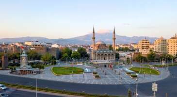 Kayseri denilince aklına sadece mantı ve pastırma geliyorsa, şaşırmaya hazır ol. Sel&ccedil;uklu'nun zarif mimarisi, Erciyes'in g&ouml;rkemli yapısı ve Anadolu'nun misafirperverliği seni unutulmaz bir yolculuğa &ccedil;ıkaracak.&nbsp; Hem merkezinde hem de il&ccedil;elerinde Eretna Beyliği, Sel&ccedil;uklu ve Osmanlı d&ouml;nemlerinde inşa edilmiş devasa kervansaraylar, etkileyici camiler, k&uuml;mbetler ve medreseler sıralanan Kayseri tarih, inan&ccedil; ve k&uuml;lt&uuml;r turlarının değişmez adresleri arasında. Ayrıca şehir, zengin mutfağı ve d&uuml;nyaca &uuml;nl&uuml; y&ouml;resel yemekleriyle gastronomi meraklılarını da kendine &ccedil;ekiyor. Liste uzun ve hepsine nasıl yetişeceğim diye d&uuml;ş&uuml;n&uuml;yorsan merak etme, şehri ve gezilecek yerlerini tanıdıktan sonra g&ouml;rmek istediğin yerleri &ccedil;ıkararak eşsiz bir rota hazırlayabileceksin. Keşfe &ccedil;ıkmaya sabırsızlandığını biliyoruz ancak şehri anlatmaya ge&ccedil;meden &ouml;nce Kayseri&rsquo;ye gidecek olanların bize en &ccedil;ok sorduğu soruları yanıtlayalım. Kayseri&rsquo;de ne yenir? Birbirinden g&uuml;zel yemeklerin bulunduğu Kayseri&rsquo;de tepsi ve Kayseri mantısı, yağlama, Kayseri pastırması, arabaşı &ccedil;orbası, sucuklu k&ouml;fte, Develi cıvıklı pidesi ve &ccedil;emenli ekmeğin mutlaka tadına bakmalısın.&nbsp;Tarih&icirc; Kapalı &Ccedil;arşı'nın taş duvarları arasında dolaşırken burnuna gelen yoğun &ccedil;emen kokusu ve bir kaşığa 40 tane sığdırılan mantının dumanı, Kayseri soğuğunda i&ccedil;ini ısıtacak. Kayseri&rsquo;den hediye olarak ne alınır? Seyahatin sırasında sevdiklerine ve kendine b&uuml;nyan ve yahyalı halısı, bez bebek, sedef &uuml;r&uuml;nleri, mantı ve pastırma gibi y&ouml;resel &uuml;r&uuml;nlerden alabilirsin. Kayseri&rsquo;de havalimanı var mı? &nbsp; Kayseri&rsquo;de Erkilet Havalimanı bulunuyor. Kayseri Erkilet Havalimanı&rsquo;ndan şehir merkezine kısa s&uuml;rede ulaşım sağlayabilirsin. 1. Kayseri Kalesi Şehrin kalbinde yer alan, g&ouml;rkemli surlarıyla turistlerin en &ccedil;ok ziyaret ettiği simgesel yapı olan Kayseri Kalesi, seyahatin sırasında ilk g&ouml;rmen gereken yerlerden. M.S. 3. y&uuml;zyılda Roma d&ouml;neminde inşa edilen, Bizans d&ouml;neminde ve Anadolu Sel&ccedil;uklu d&ouml;neminde geliştirilen Kayseri Kalesi, T&uuml;rkiye'nin g&uuml;n&uuml;m&uuml;ze kadar sağlam kalmış en etkileyici kalelerden biri olarak ilgi g&ouml;r&uuml;yor. İ&ccedil; kale ve dış kale olarak iki farklı b&ouml;l&uuml;mden oluşan devasa yapının etkileyici bur&ccedil;ları, kuleleri ve yaşam odaları arasında keyifli bir gezi yapabilir, kalenin i&ccedil;indeki tarihi Fatih Sultan Mehmet Camii&rsquo;ni ziyaret edebilirsin. Konum Linki 2. Engir G&ouml;l&uuml; (Koramaz Vadisi) 1. derece doğal sit alanı olarak korunan g&ouml;l, sulak alanları ve sazlıklarında yaşayan 140'a yakın farklı kuş t&uuml;r&uuml;nden dolayı sadece T&uuml;rkiye'nin değil, d&uuml;nyanın her yerinden doğa fotoğraf&ccedil;ılarını kendine &ccedil;ekiyor. 40 hektarlık bir alana yayılan g&ouml;l&uuml;, İlkbahar ve yaz aylarında kuşların g&ouml;&ccedil; d&ouml;nemlerinde g&ouml;ky&uuml;z&uuml;n&uuml; saran binlerce kuşla b&uuml;y&uuml;leyici manzaralara ev sahipliği yapıyor. Konum Linki 3. Kayseri Arkeoloji M&uuml;zesi Binlerce yıllık uzun bir tarihe sahip olan, tarih &ouml;ncesi &ccedil;ağlardan Osmanlı d&ouml;nemine kadar pek &ccedil;ok medeniyetten izler taşıyan ve Kayseri'nin hazinelerine ev sahipliği yapan Kayseri Arkeoloji M&uuml;zesi seyahatin sırasında mutlaka uğraman gereken yerlerden. Kayseri ve &ccedil;evresindeki antik kentlerde yapılan kazılarda elde edilen paha bi&ccedil;ilmez eserler arasında Tun&ccedil; &Ccedil;ağı mermerleri, Asur Koloniler &Ccedil;ağı&rsquo;na ait &ccedil;arpıcı sikkeler, etkileyici yazılı tabletler, el sanatı &uuml;r&uuml;nleri, vazolar ve m&uuml;h&uuml;rler yer alıyor. Frig, Helenistik, Roma ve Bizans d&ouml;nemlerine ait eserlerin de sergilendiği m&uuml;zenin 8.700 m2 b&uuml;y&uuml;kl&uuml;ğ&uuml;ndeki bah&ccedil;esinde ise devasa taş heykeller, mezar stelleri ve lahitlerin de fotoğraflarını &ccedil;ekebilirsin. B&ouml;lgenin en b&uuml;y&uuml;k m&uuml;zelerinden biri olan ve 1969 yılından beri hizmet veren Kayseri Arkeoloji M&uuml;zesi, Melikgazi il&ccedil;esi Kazancılar Caddesi &uuml;zerinde yer alıyor. Konum Linki {calismasaatleri}Giriş &uuml;creti M&uuml;zeKart ge&ccedil;erli Yabancılar i&ccedil;in bilet fiyatı 4&euro; A&ccedil;ık olduğu saatler 08.30 - 17.30{/calismasaatleri} 4. Sel&ccedil;uklu Uygarlığı M&uuml;zesi Anadolu Sel&ccedil;uklu Devletine bir d&ouml;nem başkentlik yapan Kayseri'de Sel&ccedil;uklu uygarlığından pek &ccedil;ok tarihi esere ev sahipliği yapan Sel&ccedil;uklu Uygarlığı M&uuml;zesi, seyahatin sırasında mutlaka uğraman gereken yerlerden. 2014 yılından bug&uuml;ne hizmet veren m&uuml;ze, Gevher Nesibe Dar&uuml;şşifası ile Gıyasiye Medresesi'nin birleşimi olan ve &Ccedil;ifte Medrese olarak bilinen tarihi yapının taş odalarında Anadolu mimarlık tarihinin g&uuml;n&uuml;m&uuml;ze kalan en &ouml;nemli eserlerini yakından inceleyebilirsin. Konum Linki {calismasaatleri}Giriş &uuml;creti Tam 40 TL &Ouml;ğrenci 20 TL A&ccedil;ık olduğu saatler Pazartesi g&uuml;nleri kapalı Diğer g&uuml;nler 09.00 - 17.00 Haziran, temmuz, ağustos ve eyl&uuml;l aylarında 09.00 - 19.00{/calismasaatleri} {insightBoxStart}Yazar Notu:&nbsp;Park yeri problemi yaşanıyor, aracını uzağa park edip y&uuml;r&uuml;meni tavsiye ediyoruz.{insightBoxEnd} 5. Ağırnas Yeraltı Şehri Milyonlarca yıl &ouml;nceki volkanik patlamalarla oluşmuş yumuşak t&uuml;f kayalar i&ccedil;ine yaklaşık 3000 yıl &ouml;nce oyularak inşa edilen Ağırnas Yeraltı Şehrinin t&uuml;nelleri, Ağırnas il&ccedil;esinde Mimar Sinan&rsquo;ın doğduğu evin bodrumuna kadar ulaşıyor. 2005 yılında ziyarete a&ccedil;ılan ve 100 metreden uzun t&uuml;nelleriyle unutulmaz bir gezi deneyimi sunan Ağırnas Yeraltı Şehrinin Sel&ccedil;uklu ve Osmanlılar d&ouml;nemlerine kadar kullanıldığı tahmin ediliyor. Rehberli turların yanı sıra kendi başına da keşfe &ccedil;ıkabileceğin tarihi yapı merkeze 26 kilometre uzaklıkta yer alıyor. Ağırnas Yeraltı Şehri'nin dar t&uuml;nellerinde y&uuml;r&uuml;rken, Mimar Sinan'ın &ccedil;ocukluğunda bu gizemli koridorlardan ilham alıp almadığını merak etmiyor musun? Konum Linki {calismasaatleri}A&ccedil;ık olduğu saatler Haftanın her g&uuml;n&uuml; 09.00-17.30{/calismasaatleri} {insightBoxStart}Yazar Notu: Kapalı alan korkun varsa t&uuml;nele girmemelisin.{insightBoxEnd} 6. Anadolu Harikalar Diyarı Sevdiklerinle eğlenceli zaman ge&ccedil;irebileceğin pek &ccedil;ok farklı b&ouml;l&uuml;m&uuml; bulunan Anadolu Harikalar Diyarı, Kayseri gezinde mutlaka uğramanı &ouml;nerdiğimiz yerler arasında. Onlarca vahşi hayvana ev sahipliği yapan Kayseri Hayvanat Bah&ccedil;esi'nin yanı sıra korku t&uuml;nelleriyle ilgi &ccedil;eken lunapark, &ccedil;ocuk oyun alanları, buz pateni pisti ve binicilik tesisleri de bulabileceğin temalı park, 800.000 m2 geniş bir alana yayılıyor. Konum Linki {calismasaatleri}A&ccedil;ık olduğu saatler Haftanın her g&uuml;n&uuml; 10.00-22.00{/calismasaatleri} 7. Mazakaland Eğlence Merkezi Kayseri'nin en b&uuml;y&uuml;k ve Anadolu'nun ilk temalı parkı olan alan Mazakaland Eğlence Merkezi, 70.000 metrekareden b&uuml;y&uuml;k bir alana yayılıyor. Yetişkinlere ve &ccedil;ocuklara &ouml;zel pek &ccedil;ok farklı b&ouml;l&uuml;m&uuml; bulunan eğlence merkezinin yapay g&ouml;l&uuml;nde gondollarla gezilere &ccedil;ıkabilir, go-kart, hızlı tren, &ccedil;arpışan arabalar, d&ouml;nme dolap ve paintball gibi pek &ccedil;ok farklı eğlencenin tadını &ccedil;ıkarabilirsin. Afrika, Uzak Doğu ve Antik Roma gibi ilgin&ccedil; b&ouml;l&uuml;mleri de olan Mazakaland Eğlence Merkezine en az 1 g&uuml;n&uuml;n&uuml; ayırmalısın. Konum Linki {calismasaatleri}Giriş &uuml;creti 12 yaş ve &uuml;zeri 100 TL A&ccedil;ık olduğu saatler Kış aylarında kapalı Yaz aylarında cumartesi ve pazar g&uuml;nleri 12.00-19.00{/calismasaatleri} 8. Kayseri Atat&uuml;rk Evi M&uuml;zesi 19. y&uuml;zyılda inşa edilen, klasik bir Kayseri konağı olan İmamizade Raşit Ağa Konağı&rsquo;nda 1983 yılında ziyarete a&ccedil;ılan m&uuml;ze, &ccedil;arpıcı koleksiyonlarıyla ziyaret etmen gereken yerler arasında. 19. y&uuml;zyıl d&ouml;nem mobilyalarıyla s&uuml;sl&uuml; m&uuml;zenin koleksiyonlarında Mustafa Kemal Atat&uuml;rk'&uuml;n Kayseri ziyareti sırasında &ccedil;ekilen fotoğrafları ve Atat&uuml;rk'&uuml;n balmumu heykelinin yanı sıra kişisel eşyaları ve tarihi belgeler de sergileniyor. Atat&uuml;rk Evi M&uuml;zesi hem zengin koleksiyonları hem de şehrin en g&uuml;zel konaklarından birini inceleme şansı veriyor. Konum Linki {calismasaatleri}A&ccedil;ık olduğu saatler Diğer g&uuml;nler 08.30-17.30{/calismasaatleri} 9. Kayseri Saat Kulesi Kayseri'nin en bilinen simgesel yapılarından biri de 1906 yılında II. Abd&uuml;lhamid d&ouml;neminde inşa ettirilen Kayseri Saat Kulesi. Şehrin hareketli noktalarından Cumhuriyet Meydanı&rsquo;nda hemen dikkatini &ccedil;ekecek olan etkileyici saat kulesi, aynı zamanda Mustafa Kemal Atat&uuml;rk'&uuml;n Kayseri ziyaretinde halka konuşma yaptığı yer olmasıyla da tarihi bir &ouml;neme sahip. Kurtuluş Savaşı d&ouml;neminde Anadolu ve Rumeli M&uuml;d&acirc;faa-i Hukuk Cemiyeti şubesi olarak hizmet vermiş olan k&uuml;&ccedil;&uuml;k bir ofis b&ouml;l&uuml;m&uuml; de bulunan Kayseri Saat Kulesi, hemen yanındaki g&ouml;rkemli Atat&uuml;rk heykeli ile harika bir manzara oluşturuyor. Konum Linki 10.&nbsp;Kıranardı&nbsp;Kent Ormanı (Kayseri Kent Ormanı) Kayseri Kent Ormanı olarak da bilinen ve Melikgazi il&ccedil;esinde Yayla Yolu Caddesi &uuml;zerinde uğrayabileceğin Kıranardı Kent Ormanı, şehrin kalabalığı ve g&uuml;r&uuml;lt&uuml;s&uuml;nden uzaklaşmak i&ccedil;in gidebileceğin yeşil alanlardan. Erciyes Dağı ve Kayseri'nin kuş bakışı manzaralarını sunan seyir terasları, y&uuml;r&uuml;y&uuml;ş yolları, sevimli &ouml;rdeklerin y&uuml;zd&uuml;ğ&uuml;n&uuml; g&ouml;letleri, bitki &ccedil;eşitliliği ve şehre hakim tepelerde sıralanan &ccedil;ardaklarıyla keyifli bir doğa gezisi sunan Kıranardı Kent Ormanı&rsquo;na &ouml;zellikle akşam gezilerinde uğrayarak ışıl ışıl Kayseri manzarasının harika fotoğraflarını &ccedil;ekebilirsin. Konum Linki {{campaignsSlider}} 11. Kayseri Cumhuriyet Meydanı Kayseri&rsquo;nin kalbi olarak kabul edilen ve g&uuml;zelliklerini keşfetmeye başlamak i&ccedil;in en ideal nokta olan Cumhuriyet Meydanı, hem tarih&icirc; hazineleri hem de y&ouml;resel lezzetlerin yer aldığı restoranları, kafeleri ve hediyelik eşya d&uuml;kkanları ile şehrin en hareketli yerlerinden. Meydan, yıl boyunca pek &ccedil;ok kutlama veya etkinliğe de ev sahipliği yapıyor. Konum Linki 12. Kayseri Milli M&uuml;cadele M&uuml;zesi 1893 yılında tarihi bir lisenin restore edilmesi ile 2016 yılında hizmete başlayan Kayseri Milli M&uuml;cadele M&uuml;zesi, Kurtuluş Savaşı d&ouml;nemine ait pek &ccedil;ok esere ev sahipliği yapıyor. Her yıl binlerce kişi tarafından ziyaret edilen m&uuml;zenin iyi d&uuml;zenlenmiş koleksiyonlarıyla Kurtuluş Savaşı atmosferini hissedebilirsin. Etkileyici fotoğraflar ve savaş sırasında Anadolu halkının m&uuml;cadelesini yansıtan balmumu heykeller g&ouml;r&uuml;lmeye ise değer g&uuml;zellikte. 1921 yılında T&uuml;rkiye B&uuml;y&uuml;k Millet Meclisi'nin Kayseri'ye taşınma kararı aldığında kullanılan taş mektebi de yakından g&ouml;rme şansı bulabileceğin m&uuml;zede madalyalar, tarihi belgeler ve fotoğrafları arasında unutulmaz bir g&uuml;n ge&ccedil;irebilirsin. Konum Linki 13. G&uuml;pg&uuml;poğlu Konağı Etnografya M&uuml;zesi Taş Oda Konağı olarak da bilinen ve 1419 yılında inşa edilen Kayseri&rsquo;nin en g&uuml;zel konaklarından birinde hizmet veren G&uuml;pg&uuml;poğlu Konağı Etnografya M&uuml;zesi, şehrin y&uuml;zlerce yıllık gelenekleri, g&ouml;renekleri, k&uuml;lt&uuml;r&uuml;, zengin mutfağı, y&ouml;resel giysileri ve yaşam tarzını anlamak i&ccedil;in ilk uğraman gereken yerler arasında. Haremlik ve selamlık olarak iki b&ouml;l&uuml;me ayrılmış tarihi konağın &ccedil;arpıcı koleksiyonlarında Osmanlı d&ouml;nemi g&uuml;nl&uuml;k yaşam tarzını yansıtan balmumu heykellerden antika eşyalara, el dokuması Kayseri halı ve kilimlerine kadar pek &ccedil;ok objeyi g&ouml;rebilirsin. 1400'l&uuml; yıllardan g&uuml;n&uuml;m&uuml;ze uzanan Sel&ccedil;uklu ve Osmanlı d&ouml;nemine ait pek &ccedil;ok tarih&icirc; eserin de sergilendiği G&uuml;pg&uuml;poğlu Konağı Etnografya M&uuml;zesi, Cumhuriyet Mahallesi'nde Atat&uuml;rk Evi M&uuml;zesi'nin hemen karşısında yer alıyor. Konum Linki {calismasaatleri}Giriş &uuml;creti M&uuml;zeKart ge&ccedil;erli A&ccedil;ık olduğu saatler Pazartesi g&uuml;nleri kapalı Diğer g&uuml;nler 08.30-17.30{/calismasaatleri} 14. Kayseri Hayvanat Bah&ccedil;esi Şehri gezerken keyifli zaman ge&ccedil;irebileceğin en pop&uuml;ler yerlerden biri de 2013 yılında hizmete a&ccedil;ılan Kayseri Hayvanat Bah&ccedil;esi. 160&rsquo;tan fazla t&uuml;rde binlerce hayvana ev sahipliği yapan hayvanat bah&ccedil;esi, aynı zamanda sahipsiz hayvanlar i&ccedil;in barınma ve doğal yaşam merkezi olarak da hizmet veriyor. Aslan ve kaplanlardan sevimli tavus kuşlarından z&uuml;rafalara kadar pek &ccedil;ok vahşi hayvanı yakından g&ouml;rme şansı bulabileceğin Kayseri Hayvanat Bah&ccedil;esi, buz pisti, spor sahaları, &ccedil;ocuk oyun alanları, kır bah&ccedil;eleri ve dinlenme tesisleriyle de yılın her d&ouml;neminde ilgi g&ouml;r&uuml;yor. Konum Linki {calismasaatleri}Giriş &uuml;creti M&uuml;zeKart ge&ccedil;erli A&ccedil;ık olduğu saatler Haftanın her g&uuml;n&uuml; 10.00-16.30{/calismasaatleri} 15. B&uuml;r&uuml;ng&uuml;z Camii Kayseri'de gezebileceğin en etkileyici camilerden biri olan 1977 yılında Kayseri Cumhuriyet Meydanı&rsquo;nda hizmete a&ccedil;ılan B&uuml;r&uuml;ng&uuml;z Camii aynı zamanda şehrin en b&uuml;y&uuml;k camisi olarak karşımıza &ccedil;ıkıyor. Klasik Osmanlı mimarisinin yansıtan cami, tasarımı, y&uuml;zlerce yıllık mesicidi ve 4 b&uuml;y&uuml;k kubbesiyle g&ouml;r&uuml;lmeye değer g&uuml;zelliklerden. Merkezi bir konumda bulunan ve Kayseri&rsquo;nin tarihi yapıları arasında y&uuml;kselen B&uuml;r&uuml;ng&uuml;z Camii, aynı zamanda cam iş&ccedil;iliği ve kubbelerindeki klasik Osmanlı s&uuml;slemeleriyle de dikkat &ccedil;ekiyor. Konum Linki 16. Eski Kayseri Evleri B&ouml;lgeye &ouml;zg&uuml; mimarileri ile b&uuml;y&uuml;leyici manzaralar sunan, dar ve &ccedil;ıkmaz sokaklarda sıralanan tarihi Kayseri evleri, şehri gezerken seni bambaşka diyarlara g&ouml;t&uuml;recek. 2 ile 3 katlı, bah&ccedil;eli ve avlulu olarak tasarlanan, iklim şartlarına uygun olarak hem soğuk hem sıcağa dayanacak şekilde inşa edilmiş tarihi konaklar ve k&ouml;şkler, Kayseri'de d&uuml;zenlenen fotoğraf safarilerinin de değişmez adresleri arasında. En g&uuml;zel &ouml;rneklerini Melikgazi il&ccedil;esindeki G&uuml;ndoğdu Sokak &uuml;zerinde g&ouml;rebileceğin Kayseri evleri, hem Sel&ccedil;uklu hem de Osmanlı d&ouml;nemi mimari &ouml;zelliklerini yansıttığı i&ccedil;in mimari severler tarafından da sık&ccedil;a ziyaret ediliyor. Bazıları m&uuml;ze, kafe veya butik otel olarak hizmet veren konakların avlu, oturma odası, kiler ve sofa gibi i&ccedil; b&ouml;l&uuml;mlerini de gezebilirsin. Konum Linki 17. Erciyes Kayak Merkezi Sadece T&uuml;rkiye'den değil, d&uuml;nyanın her yerinden kış tatilleri i&ccedil;in binlerce insanın ziyaret ettiği Erciyes Kayak Merkezi, Erciyes Dağı eteklerinde 2.150 ile 3.400 metre y&uuml;ksekte yer alıyor. Toplam uzunlukları 100 kilometreyi bulan kayak pistleri ile hizmet veren kayak merkezinde 154 tane suni kar makinesinin yanı sıra 18 tane son teknoloji olanaklarla donatılmış, 26.000 kişi taşıma kapasiteli&nbsp;telesiyej ve teleski hatları de bulunuyor. Her zorluk derecesine g&ouml;re d&uuml;nya standartlarında kayak pistleri sunan Erciyes Kayak Merkezi'nde &ccedil;ocuklar i&ccedil;in g&uuml;venlikli &ouml;zel pistler ve &ccedil;ocuk oyun alanları da bulunuyor. Her yaş grubu i&ccedil;in kayak ve snowboard eğitimlerinin verildiği kayak merkezi, kış sezonu, yılbaşı ve bayramlarda ise tamamen doluyor. &Uuml;lkemizin en iyi kayak merkezlerinden birine ev sahipliği yapmasının yanı sıra en g&uuml;zel&nbsp;kış tatilini yaşayabileceğin Kayseri&rsquo;ye yola &ccedil;ıkmadan &ouml;nce&nbsp;Erciyes kayak merkezi rehberi&nbsp;yazısına tıklayarak g&uuml;zel bir tatil programı yapabilirsin. Konum Linki 18. K&uuml;ltepe &Ouml;ren Yeri Kayseri&rsquo;ye sadece 20 kilometre uzaklıkta, Erciyes Dağı eteklerinde inşa edilen K&uuml;ltepe Antik Kenti'nden g&uuml;n&uuml;m&uuml;ze kalan tarihi yapıları, rehberli turlarla veya kendi başına keşfe &ccedil;ıkabilirsin. Anadolu&rsquo;nun en eski krallığı olarak bilinen Kaniş Krallığı&rsquo;nın merkezi olan antik kent, uzun yıllar boyunca Anadolu ve Mezopotamya arasında &ouml;nemli bir ticaret merkezi olarak varlığını s&uuml;rd&uuml;rm&uuml;ş. B&ouml;lgede yapılan kazılarda Kapadokya Tabletleri olarak bilinen ilk &ccedil;ivi yazısı &ouml;rneklerinin de bulunduğu K&uuml;ltepe &Ouml;ren Yeri, tarih ve arkeoloji meraklılarının kesinlikle uğraması gereken yerler arasında. Konum Linki {calismasaatleri}A&ccedil;ık olduğu saatler Kış d&ouml;nemi haftanın her g&uuml;n&uuml; 08.30-17.30 Yaz d&ouml;nemi haftanın her g&uuml;n&uuml; 08.30 - 19.00{/calismasaatleri} 19. Erciyes Dağı Kayseri'ye yaklaşık 25 kilometre uzaklıkta bulunan ve g&ouml;rkemli manzarasını şehrin her yerinden g&ouml;rebileceğin Erciyes Dağı, 3.917 metre y&uuml;ksekliğiyle İ&ccedil; Anadolu'nun en b&uuml;y&uuml;k, T&uuml;rkiye'nin ise 5. b&uuml;y&uuml;k dağı konumunda. Doğa sporları yapmak i&ccedil;in T&uuml;rkiye'de en &ccedil;ok tercih edilen yerlerden olan Erciyes Dağı'nda yılın her d&ouml;nemi rehberlerle doğa y&uuml;r&uuml;y&uuml;şlerine &ccedil;ıkabilir, dağ eteklerinde kamp, kaya tırmanma, dağcılık ve dağ bisikleti gezileri gibi pek &ccedil;ok aktivite yapabilirsin. Volkanik patlamalarıyla Kapadokya'daki etkileyici kaya oluşumları ve peribacalarının oluşmasına neden olan dağlardan biri olan Erciyes Dağı, aynı zamanda her yıl binlerce insanı kendine &ccedil;eken Erciyes Kayak Merkezi&rsquo;ne de ev sahipliği yapıyor. Konum Linki 20. Sultan Sazlığı Milli Parkı Kayseri'ye yaklaşık 85 kilometre uzaklıktaki Yeşilhisar il&ccedil;esi sınırlarında yer alan ve sadece T&uuml;rkiye'nin değil, d&uuml;nyanın da en &ouml;nemli kuş yaşam alanlarından biri olarak g&ouml;sterilen Sultan Sazlığı Milli Parkı, 500'e yakın bitki &ccedil;eşidi ve vahşi yaşam zenginliğiyle doğa severlerin mutlaka keşfetmesi gereken yerlerden biri. Sevimli flamingoları ve turnalarıyla &uuml;nl&uuml; milli park, g&ouml;l kenarındaki sazlıklarda ev sahipliği yaptığı 300 t&uuml;rden fazla su kuşu ve g&ouml;&ccedil;men kuşlarından dolayı kuş cenneti olarak da koruma altında. 25.000 hektarlık geniş bir alana yayılan Sultan Sazlığı Milli Parkı&rsquo;nı yılın her d&ouml;nemi doğa y&uuml;r&uuml;y&uuml;şleri ve fotoğraf safarileri ile keşfe &ccedil;ıkabilir, g&ouml;l &ccedil;evresini saran y&uuml;r&uuml;y&uuml;ş parkurları ve mesire alanlarında tertemiz havada yorgunluk atabilirsin. Konum Linki {calismasaatleri}Giriş &uuml;creti Yetişkin 40 TL &Ouml;ğrenci 20 TL A&ccedil;ık olduğu saatler Haftanın her g&uuml;n&uuml; 08.00-18.00{/calismasaatleri} 21. Alaca K&uuml;mbeti Kayseri&rsquo;yi gezerken hemen dikkatini &ccedil;ekecek tarihi yapılardan biri de Melikgazi il&ccedil;esinde Cumhuriyet Meydanı&rsquo;na kısa bir y&uuml;r&uuml;y&uuml;ş mesafesinde yer alan Alaca K&uuml;mbeti. M.S. 1184 yılında inşa edilen ve Kayseri'deki en eski yapılardan biri olan Alaca K&uuml;mbeti, kesme taşlarla inşa edilmiş ve sivri kubbesi ile dikkat &ccedil;ekiyor. Dış b&ouml;l&uuml;mleri geometrik şekiller ve bitki desenleriyle s&uuml;slenmiş anıtsal yapıyı ziyaret ederek Sel&ccedil;uklu ve Beylik d&ouml;nemi mimari &ouml;zelliklerini yakından inceleyebilirsin. Konum Linki 22. Gesi Bağları Melikgazi il&ccedil;esi sınırlarında yer alan ve g&uuml;vercinlerin kayalara oyulmuş yuvaları ile &uuml;nl&uuml; Gesi bağlarını gezerken Kapadokya'da g&ouml;rmeye alıştığımız manzaralarla karşılaşacaksın. Yemyeşil doğal g&uuml;zellikleri, b&uuml;y&uuml;leyici kuş yuvaları ve temiz havasıyla doğa gezilerinin de değişmez adreslerinden biri haline gelen Gesi Bağları'nda hem harika fotoğraflar &ccedil;ekebilir hem de geleneksel Kayseri lezzetlerini tadarak g&uuml;zel bir g&uuml;n ge&ccedil;irebilirsin. Konum Linki 23. Ali Dağı Kayseri merkezine sadece 17 kilometre uzaklıkta yer alan ve hem yama&ccedil; paraş&uuml;t&uuml; hem de doğa sporları yapmak i&ccedil;in şehirde en &ccedil;ok tercih edilen yer olan Ali Dağı, doğa gezileri ve fotoğraf&ccedil;ılık turlarının da en sevilen adreslerinden biri. Yama&ccedil; paraş&uuml;t&uuml;ne uygun yama&ccedil;larından 5.000 metreye kadar uzmanlarla yama&ccedil; paraş&uuml;t&uuml; yapabileceğin ve Kayseri&rsquo;nin kuş bakışı manzaralarını izleyebileceğin Ali Dağı, son yıllarda sadece Kayseri&rsquo;nin değil T&uuml;rkiye&rsquo;nin de en pop&uuml;ler yama&ccedil; paraş&uuml;t&uuml; merkezlerinden biri haline geldi. Kuzey r&uuml;zgarları alan 2 tane yama&ccedil; paraş&uuml;t&uuml; pistinin yanı sıra iyi d&uuml;zenlenmiş y&uuml;r&uuml;y&uuml;ş yolları, dağ bisiklet parkurları, kamp alanları, kaya tırmanma ve dağcılık imkanlarıyla yılın her mevsimi ziyaret edilen Ali Dağı, şehrin panoramik manzaralarının fotoğraflarını &ccedil;ekmek i&ccedil;in de ilk uğraman gereken yerlerden. Konum Linki 24. Aladağlar Milli Parkı 55.000 hektarlık geniş bir alana yayılan, Kayseri'nin yanı sıra Niğde ve Adana sınırlarına kadar uzanan Aladağlar Milli Parkı, sadece T&uuml;rkiye'den değil t&uuml;m d&uuml;nyadan doğa severleri kendine &ccedil;ekiyor. Yılın her mevsimi rehberli doğa y&uuml;r&uuml;y&uuml;şleri, fotoğraf&ccedil;ılık safarileri ve bisiklet turlarının d&uuml;zenlendiği milli park, endemik bitki t&uuml;rleri, onlarca &ccedil;eşit kuş t&uuml;r&uuml; ve vahşi yaşam g&uuml;zellikleri ile T&uuml;rkiye'nin &ouml;nemli tabiat cennetlerinden. El değmemiş g&uuml;zelliklerinin korunması amacıyla 1995 yılından koruma altına alınan Aladağlar Milli Parkı'nda uzmanlarla birlikte yama&ccedil; paraş&uuml;t&uuml; yaparak kilometrelerce uzanan yemyeşil manzaraları izleyebilirsin. Kızıl&ccedil;am, k&ouml;knar, sedir, ardı&ccedil; ağa&ccedil;ları arasında uzanan y&uuml;r&uuml;y&uuml;ş parkurlarında irili ufaklı şelaleler, devasa buzul kayalıkları ve buz gibi dereler arasında yılın yorgunluğunu atabileceğin park, &ouml;zellikle sonbaharda sunduğu benzersiz manzarasıyla doğa fotoğraf&ccedil;ılarının ilk adresleri arasında. Konum Linki {calismasaatleri}A&ccedil;ık olduğu saatler Haftanın her g&uuml;n&uuml; 08.00-22.00{/calismasaatleri} 25. Emir Ali K&uuml;mbeti Kayseri&rsquo;ye bir d&ouml;nem egemenlik kurmuş Eretna Beyliği h&uuml;k&uuml;mdarı Emir Erdoğmuş i&ccedil;in yaptırılan etkileyici Emir Ali K&uuml;mbeti, Seyyid Burhaneddin T&uuml;rbesi&rsquo;nin hemen yanında yer alıyor. 1351 yılında inşa edilen k&uuml;mbet, 1955 yılında restore edilerek ziyarete a&ccedil;ıldı. Halk arasında Pişrev Ali T&uuml;rbesi olarak bilinen ve t&uuml;rbenin altındaki mumyalık b&ouml;l&uuml;m&uuml;yle de dikkat &ccedil;eken Emir Ali K&uuml;mbeti, kesme taşlarla inşa edilmiş ve tonozlar ile &ouml;rt&uuml;lm&uuml;ş &ccedil;arpıcı bir yapı. Kemerli kapısı, sivri kemerleri ve d&ouml;nem &ouml;zelliklerini yansıtan taş s&uuml;slemeleriyle de ilgi &ccedil;eken k&uuml;mbet, Kayseri inan&ccedil; ve k&uuml;lt&uuml;r turlarının bir par&ccedil;ası konumunda. Konum Linki 26. Tekir Yaylası Erciyes Dağı eteklerinde uzanan Tekir Yaylası, yazın en sıcak g&uuml;nlerinde bile serin kalan tertemiz havası ile son yıllardaki en g&ouml;zde ka&ccedil;ış noktalarından. Hem kendi başına hem de rehberli doğa gezileri ve yayla turlarıyla keşfedebileceğin, deniz seviyesinden 2.500 metre y&uuml;kseklikte yer alan Tekir Yaylası, donanımlı kamp alanları ile aynı zamanda Kayseri'de kamp yapmak isteyenlerin ilk tercihlerinden. İlkbahar ve sonbahar aylarında rengarek &ccedil;i&ccedil;ekleri, ahşap yayla evleri ve etkileyici Erciyes Dağı manzaraları eşliğinde temiz havada yılın b&uuml;t&uuml;n yorgunluğunu atabilirsin. Konum Linki 27. Kayseri Kapalı &Ccedil;arşı &Ouml;nemli ticaret yolları &uuml;zerinde yer aldığı i&ccedil;in y&uuml;zlerce yıl boyunca b&uuml;y&uuml;k bir ticaret merkezi olan ve g&uuml;n&uuml;m&uuml;zde de Anadolu&rsquo;nun en b&uuml;y&uuml;k ticaret şehirlerinden biri olan Kayseri'de yerli ve yabancı turistlerin alışveriş yapmak i&ccedil;in ilk uğradığı yer tarihi Kayseri Kapalı &Ccedil;arşı. 1497 yılında inşa edildiği g&uuml;nden beri Kayseri'nin en hareketli yerlerinden biri olan ve 15 farklı b&ouml;l&uuml;mden oluşan &ccedil;arşı, İstanbul Kapalı &Ccedil;arşı&rsquo;dan sonra T&uuml;rkiye'nin en b&uuml;y&uuml;k kapalı &ccedil;arşısı olması ile &uuml;nl&uuml;. 1.800 tane d&uuml;kkanın hizmet verdiği Kayseri Kapalı &Ccedil;arşı'da şehrin lezzetli sucuk, pastırma ve mantılarının yanı sıra b&ouml;lgeye &ouml;zg&uuml; el sanatı &uuml;r&uuml;nleri, g&uuml;m&uuml;ş ve bakır işleri, y&ouml;resel giysiler, antikalar ve Kayseri temalı hediyelik eşyalar gibi binlerce &uuml;r&uuml;n&uuml; bir arada bulabilirsin. Hem klasik Osmanlı mimarisini yansıtan etkileyici taş tasarımı hem de zengin alışveriş se&ccedil;enekleriyle Kayseri Kapalı &Ccedil;arşı uğraman gereken yerler arasında. Konum Linki {calismasaatleri}A&ccedil;ık olduğu saatler Haftanın her g&uuml;n&uuml; 08.00-19.00{/calismasaatleri} 28. Derebağ Şelalesi Kayseri merkezine yaklaşık 90 kilometre uzaklıktaki Yahyalı il&ccedil;esi sınırlarında yer alan Derebağ Şelalesi, Kayseri seyahatinde g&ouml;rmeni &ouml;nerdiğimiz doğa harikalarından biri. 15 metre y&uuml;kseklikteki kayalar arasından akan bembeyaz suları, buz gibi şelale g&ouml;letleri, endemik bitki t&uuml;rleri ve vahşi yaşam zenginliğinin yanı sıra Derebağ Şelalesi, iyi d&uuml;zenlenmiş mesire alanlarıyla da hem Kayseri halkı hem de de turistler tarafından sık&ccedil;a ziyaret ediliyor. Konum Linki 29. Kurşunlu Camii (Mimar Sinan Camii) Mimar Sinan&rsquo;ın eseri olan Kurşunlu Camii (Mimar Sinan Camii) 1585 yılından g&uuml;n&uuml;m&uuml;ze gelen yapılardan. Cami, klasik Osmanlı mimarisinin yanı sıra &ccedil;arpıcı kalem nakışlarıyla &uuml;nl&uuml; i&ccedil; s&uuml;slemeleri, sivri kemerleri, kubbeli şadırvanı ve camiye ismini veren kurşun kaplı kubbesiyle şehrin simgesel yapılarından biri. Kesme taşlarla &ccedil;ift revaklı olarak tasarlanan Kurşunlu Camii, Kayseri&rsquo;nin en g&uuml;zel camilerinden biri olarak hem yerli hem de yabancı turistler tarafından sık&ccedil;a ziyaret ediliyor. Konum Linki 30. Kayseri Bedesteni Kayseri'nin merkezi il&ccedil;elerinden Melikgazi&rsquo;de uğraman gereken &ouml;nemli bir yapı da g&uuml;n&uuml;m&uuml;ze kadar sağlam kalmış mimarisiyle ilgi g&ouml;ren Kayseri Bedesteni. 9 kubbeli ve d&ouml;rt k&ouml;şe planlı olarak 1497 ile 1498 yılları arasında inşa edilen ve y&uuml;zlerce yıl boyunca kumaş satıcılarına ev sahipliği yapan bedesten, g&uuml;n&uuml;m&uuml;zde de &ouml;nemli bir ticaret merkezi. İ&ccedil;erdeki d&uuml;kkanlarda y&ouml;resel giysilerden Kayseri&rsquo;nin &uuml;nl&uuml; el yapımı halı ve kilimlerine, antika eşyalardan bakır &uuml;r&uuml;nlerine kadar onlarca &ccedil;eşit &uuml;r&uuml;n bulabileceğin ve keyifli alışverişler yapabileceğin Kayseri Bedesteni, k&uuml;&ccedil;&uuml;k taş d&uuml;kkanları ve g&uuml;zel mimarisiyle yabancı turistlerin de &ccedil;ok ilgisini &ccedil;ekiyor. Konum Linki 31. H&uuml;rmet&ccedil;i K&ouml;y&uuml; ve Sazlığı Kayseri'ye sadece 17 kilometre uzaklıkta yer alan ve &ccedil;ok sevilen bir doğa gezisi alanı H&uuml;rmet&ccedil;i K&ouml;y&uuml;. Karlarla kaplı Erciyes Dağı'nın manzarasının s&uuml;slediği ovalarda &ouml;zg&uuml;rce koşan yılkı atlarıyla &uuml;nl&uuml; k&ouml;y, d&uuml;nyanın her yerinden atların fotoğraflarını &ccedil;ekmek isteyenleri kendine &ccedil;ekiyor. Doğa y&uuml;r&uuml;y&uuml;şleri, fotoğraf&ccedil;ılık turları veya kamp yapmak i&ccedil;in mutlaka uğramanı &ouml;nerdiğimiz H&uuml;rmet&ccedil;i K&ouml;y&uuml;'nde kahvaltıları ve y&ouml;resel lezzetleri tadarak da g&uuml;zel zamanlar ge&ccedil;irebilirsin. Konum Linki 32. Soğanlı Vadisi Hem tarih&icirc; &ouml;nemi hem de b&uuml;y&uuml;leyici manzaralarıyla g&uuml;n&uuml;birlik gezilerin değişmez adreslerinden biri haline gelen Soğanlı Vadisi, tarih ve k&uuml;lt&uuml;r meraklılarının yanı sıra fotoğraf&ccedil;ılık tutkunlarının da mutlaka uğraması gereken yerlerden. İlk Hristiyanlık d&ouml;neminde b&ouml;lgeye gelen rahip ve keşişler tarafından inşa edilmiş Kapadokya&rsquo;ya &ouml;zg&uuml; kaya kiliseleri, yerleşim yeri olarak kullanılan mağaralar, etkileyici kiliseler ve manastırlarıyla &uuml;nl&uuml; vadide Aziz Barbara Kilisesi, Karabaş Kilisesi, Kubbeli Kilisesi, Yılanlı Kilisesi gibi birbirinden ilgin&ccedil; tarihi yapıları gezme şansı bulacaksın. Konum Linki {calismasaatleri}A&ccedil;ık olduğu saatler Haftanın her g&uuml;n&uuml; 08.00-19.00{/calismasaatleri} 33. Kapuzbaşı Şelaleleri T&uuml;rkiye'nin en etkileyici şelalerinden biri olan Kapuzbaşı Şelaleleri, T&uuml;rkiye&rsquo;nin g&ouml;r&uuml;lmesi gereken doğa harikalarından biri. G&ouml;rkemli manzarasıyla t&uuml;m d&uuml;nyadan insanların ilgisini &ccedil;eken ve 7 tane şelalenin birleşmesinden oluşan Kapuzbaşı Şelaleleri, 60 metreyi bulan y&uuml;kseklikten d&ouml;k&uuml;len sularıyla b&uuml;y&uuml;leyici bir manzara sunuyor. &Ccedil;evresi iyi d&uuml;zenlenmiş y&uuml;r&uuml;y&uuml;ş yollarıyla keşfe &ccedil;ıkabileceğin ve tertemiz havasında mesire alanlarında piknik yapabileceğin şelaleler, aynı zamanda buz gibi sularla dolu kaya g&ouml;letleriyle sıcak g&uuml;nlerde &ccedil;ok sevilen bir ka&ccedil;ış noktası. Yılın her mevsimi fotoğraf&ccedil;ılık turları ve doğa y&uuml;r&uuml;y&uuml;şleri i&ccedil;in değişmez adreslerden olan Kapuzbaşı Şelaleleri, Yahyalı il&ccedil;esine bağlı K&uuml;&ccedil;&uuml;k&ccedil;ayır K&ouml;y&uuml; sınırında yer alıyor ve Kayseri merkezine yaklaşık 145 kilometre uzaklıkta. Konum Linki {insightBoxStart}Yazar Notu: Şelaleye giden yol &ccedil;ok virajlı olduğu i&ccedil;in dikkatli olmalısın.{insightBoxEnd} 34. Gereme Harabeleri İlk Hristiyanlık d&ouml;neminin &ouml;nemli dini merkezlerinden biri olan ve Kayseri'nin Develi il&ccedil;esine yaklaşık 12 kilometre uzaklıkta, Erciyes Dağı'nın eteklerinde uzanan Gereme Harabeleri, Anadolu'da d&uuml;zenlenen tarih ve k&uuml;lt&uuml;r gezilerinin vazge&ccedil;ilmezleri arasında. Hz. İsa'nın havarilerinden Aziz Paul'un M.S. 532 yılında Hristiyanlığı yaymak i&ccedil;in inananlarla b&ouml;lgeye gelmesi ve burada mabetler inşa etmesi ile yerleşimin başladığı Gereme, Kapadokya&rsquo;da g&ouml;rmeye alıştığımız taş kilise ve mabetleriyle g&ouml;r&uuml;lmeye değer g&uuml;zellikte. Aziz Paul Kilisesi ve Roma d&ouml;neminde inşa edilen su kemerlerinin kalıntılarını da g&ouml;rebileceğin gezinde Hititler, Asurlar, Frigyalılar ve Romalılar tarafından inşa edilmiş tarih&icirc; yapıların g&uuml;n&uuml;m&uuml;ze kalan b&ouml;l&uuml;mlerini inceleyebilirsin. Konum Linki 35. Avgunlu Medresesi ve T&uuml;rbesi 13. y&uuml;zyılın ilk d&ouml;neminde inşa edildiği tahmin edilen ve Kayseri merkezinde Mimar Sinan Parkı i&ccedil;inde gezebileceğin Avgunlu Medresesi, hem etkileyici taş mimarisi hem de i&ccedil;inde hizmet veren onlarca kitap&ccedil;ı, sahaf ve antikacıyla keyifle gezebileceğin yerler arasında. Tek katlı, iki eyvanı ve revaklı avlusu tarzıyla klasik bir Sel&ccedil;uklu d&ouml;nemi eseri olan medrese, avlusundaki g&uuml;zel havuzdan dolayı halk arasında Havuzlu Medrese olarak da biliniyor. İlk d&ouml;nem Sel&ccedil;uklu mimarisini yansıttığı i&ccedil;in mimari meraklılarının da sık&ccedil;a ziyaret ettiği taş medresede hem tarih gezisi yapabilir hem de sahaflardan &ccedil;ok az yerde bulabileceğin kitapları alabilirsin. Konum Linki {calismasaatleri}A&ccedil;ık olduğu saatler Hafta i&ccedil;i 08.00-17.00{/calismasaatleri} 36. Hunat Hatun K&uuml;lliyesi B&ouml;lgede pek &ccedil;ok etkileyici yapı inşa ettiren Anadolu Sel&ccedil;uklu Sultanı I. Alaeddin Keykubad&rsquo;ın eşi Mahperi Hatun (Hunat Hatun) adına 1238 yılında yaptırılan Hunat Hatun K&uuml;lliyesi, Kayseri'nin en &ouml;nemli tarihi hazinelerinden. Klasik Sel&ccedil;uklu mimarisini yansıtan ve Anadolu'daki en g&uuml;zel k&uuml;lliye &ouml;rneklerinden biri olarak g&ouml;sterilen Hunat Hatun K&uuml;lliyesi, &uuml;st&uuml; a&ccedil;ık kare planlı bir avlu &ccedil;evresine sıralanmış medrese odalarından oluşuyor. Uzun yıllar dini eğitimlerin verildiği yapı, 1969 yılında arkeoloji m&uuml;zesi ve daha sonra da etnografya m&uuml;zesi olarak hizmet vermeye devam etmiş. G&uuml;n&uuml;m&uuml;zde restore edilen ve y&ouml;reye &ouml;zg&uuml; el sanatı &uuml;r&uuml;nlerinin satıldığı bir &ccedil;arşı olarak kullanılan k&uuml;lliye, hem kesme taşlarla inşa edilmiş &ccedil;arpıcı mimarisi hem de zengin alışveriş olanaklarından dolayı sık&ccedil;a ziyaret ediliyor. Konum Linki {insightBoxStart}Yazar Notu: Hunat Hatun K&uuml;lliyesi&rsquo;ni gezdikten sonra &ccedil;ok yakın yerde alan tarih&icirc; Hunat Hatun Camii&rsquo;ni de ziyaret etmelisin.{insightBoxEnd} 37. Yay G&ouml;l&uuml; Kayseri'nin Develi il&ccedil;esi sınırında yer alan Yay G&ouml;l&uuml;, zengin balık &ccedil;eşitliliğiyle balık avlama turlarına katılmak, y&uuml;r&uuml;y&uuml;şlere &ccedil;ıkmak veya doğa fotoğrafları &ccedil;ekmek isteyenler tarafından sıklıkla ziyaret ediliyor. Sultan Sazlığı&rsquo;nın bir b&ouml;l&uuml;m&uuml;n&uuml; de kapsayan g&ouml;l, volkanik patlamalarla oluşmuş etkileyici g&ouml;llerimizden biri. 1972 yılında su kuşları koruma alanı ilan edilen ve y&uuml;zlerce g&ouml;&ccedil;men kuşuyla Kayseri&rsquo;de d&uuml;zenlenen kuş g&ouml;zlem turlarının en &ouml;nemli noktalarından biri haline gelen Yay G&ouml;l&uuml;&rsquo;n&uuml; gezerken dikkuyruk, gece balık&ccedil;ılı, alaca balık&ccedil;ıl, karabatak ve tepeli pelikan gibi pek &ccedil;ok nadir kuş t&uuml;r&uuml;n&uuml; yakından g&ouml;rme şansı bulabilirsin. Konum Linki 38. Zamantı Irmağı Kayseri merkezine 68 kilometre uzaklıktaki Pınarbaşı il&ccedil;esi sınırlarında yer alan ve Seyhan Nehri'ni besleyen en b&uuml;y&uuml;k kollardan olan Zamantı Irmağı, hem doğa i&ccedil;inde zaman ge&ccedil;irmek hem de doğa sporları yapmak i&ccedil;in en &ccedil;ok tercih edilen yerler arasında. Bitki &ccedil;eşitliliği ve vahşi yaşam zenginliği ile dikkat &ccedil;eken Zamantı Irmağı, aynı zamanda bahar ve yaz aylarında d&uuml;zenlenen rafting etkinlikleriyle de son yıllarda olduk&ccedil;a hareketli. 51 kilometre uzunluğuna sahip ırmağın 15 kilometrelik zorlu rafting parkuru bulunuyor. Etkileyici kanyonlar ve ormanlar arasında ilerleyen parkurda uzmanlarla rafting yapmanın yanı sıra kano ve sandallarla da gezilere &ccedil;ıkarak harika fotoğraflar &ccedil;ekebilirsin. Onlarca &ccedil;eşit balığıyla b&ouml;lgenin en pop&uuml;ler balık avlama noktalarından biri olan Zamantı Irmağı&rsquo;nda balık avlama turlarına katılarak veya olta balık&ccedil;ılığı yaparak doğanın i&ccedil;inde dinlenebilirsin. Konum Linki 39. Yaman Dede Camii (Panaya Kilisesi) 1886 yılında Sultan II. Abd&uuml;lhamid d&ouml;neminde Panaya Kilisesi olarak inşa edilen yapı, 1925 yılında Yaman Dede Camii ismini almış. Rum kilisesi olarak inşa edilen ve klasik Rum d&ouml;nemi mimari &ouml;zelliklerini yansıtan yapı, kilise g&ouml;r&uuml;n&uuml;m&uuml;yle hem yerli hem de yabancı turistlerin ilgisini &ccedil;ekiyor. G&uuml;n&uuml;m&uuml;zde i&ccedil; b&ouml;l&uuml;mleri harabe halinde olan Yaman Dede Camii, &ccedil;arpıcı dış mimarisiyle sık&ccedil;a ziyaret ediliyor. İnan&ccedil; ve tarih turlarının yanı sıra kendi başına da ziyaret edebileceğin tarih&icirc; Yaman Dede Camii&rsquo;nde Rum, Ortodoks ve klasik Osmanlı mimarisinin birleşimini yakından g&ouml;rebilirsin. Konum Linki 40. Zeynel Abidin T&uuml;rbesi Hz. Muhammed'in torunlarından olan ve 1414 yılında Kayseri'de vefat eden Zeynel Abidin i&ccedil;in 1886 yılında inşa ettirilen Zeynel Abidin T&uuml;rbesi, her yıl binlerce kişiyi ağırlıyor. Klasik Osmanlı mimarisi ile kare planlı ve kubbeli olarak inşa edilen t&uuml;rbenin i&ccedil;inde İmam Sultan olarak da bilinen Zeynel Abidin&rsquo;in etkileyici el oymaları ile s&uuml;sl&uuml; sandukası yer alıyor. Kapısındaki Sultan II. Abd&uuml;lhamid tuğrasıyla da dikkat &ccedil;eken t&uuml;rbe, dini bayramlar ve kutsal g&uuml;nlerde dua etmek isteyen binlerce kişiyi ağırlıyor. Melikgazi il&ccedil;esinde Sivas Bulvarı &uuml;zerinde yer alan ve Cumhuriyet Meydanı, Kayseri Kapalı &Ccedil;arşı, Kayseri Kalesi gibi turistik noktalara olduk&ccedil;a yakın olan Zeynel Abidin T&uuml;rbesi&rsquo;ne kısa bir y&uuml;r&uuml;y&uuml;şle ulaşabilirsin. Konum Linki 41. Kayseri Ulu Camii Cami Kebir veya Sultan Camii olarak da bilinen ve Danişmentliler d&ouml;neminde 1143 yılında inşa edildiği d&uuml;ş&uuml;n&uuml;len Kayseri Ulu Camii, şehrin hem en eski hem de en etkileyici camilerinden biri olarak karşımıza &ccedil;ıkıyor. Camii, Bizans ve Roma mimarisinden de izler taşıyan s&uuml;tunlarıyla dikkat &ccedil;ekiyor. Antik bir kiliseden d&ouml;n&uuml;şt&uuml;r&uuml;ld&uuml;ğ&uuml; tahmin edilen Kayseri Ulu Camii, Sel&ccedil;uklu ile Osmanlı d&ouml;nemlerinde de bazı değişikliklere uğramış ve genişletilmiş. Huzurlu atmosferi, etkileyici i&ccedil; mekanları, kesme ve moloz taşlarla inşa edilmiş dış mimarisiyle etkileyici bir yapı olan Kayseri Ulu Camii'yi ziyaret ederek Roma, Bizans, Beylik, Sel&ccedil;uklu ve Osmanlı mimarilerinin bir birleşimine şahit olabilirsin. Konum Linki 42. Mimar Sinan Evi Osmanlı İmparatorluğu d&ouml;neminin en &ouml;nemli mimarlarından biri olan ve pek &ccedil;ok şaheser inşa eden Mimar Sinan'ın Kayseri'ye 27 kilometre uzaklıktaki Ağırnas&rsquo;ta doğduğu ev, g&uuml;n&uuml;m&uuml;zde m&uuml;ze olarak hizmet veriyor. Geleneksel taş ve ahşap mimarili bir Kayseri konağı olan evin i&ccedil;indeki t&uuml;neller Ağırnas Yeraltı Şehri&rsquo;ne kadar uzanıyor. 2006 yılında restore edilerek ziyarete a&ccedil;ılan ve her yıl binlerce kişi tarafından ziyaret eden Mimar Sinan Evi&rsquo;nin d&ouml;nem mobilyaları ve eşyalarıyla s&uuml;sl&uuml; odalarında Mimar Sinan&rsquo;ın yetiştiği ortamı yakından g&ouml;rebilir, b&uuml;y&uuml;k ustanın inşa ettiği eserlerden &ouml;rnekleri inceleyebilir ve tarih&icirc; atmosferde yer altı odalarını keşfe &ccedil;ıkabilirsin. Konum Linki 43. D&ouml;ner K&uuml;mbet (Şah Cihan Hatun K&uuml;mbeti) 1276 yılında Anadolu Sel&ccedil;uklu Sultanı I. Al&acirc;eddin Keykubad&rsquo;ın kızı Şah Cihan Hatun i&ccedil;in yaptırdığı D&ouml;ner K&uuml;mbet, Melikgazi il&ccedil;esinde yer alıyor. &Uuml;zerindeki &ccedil;ift başlı kartal, kanatlı pars, kanatlı aslan ve Sel&ccedil;uklu simgelerinden hayat ağacı taş oymalarıyla ziyaret&ccedil;ilerini b&uuml;y&uuml;leyen D&ouml;ner K&uuml;mbet&rsquo;in 12 b&ouml;l&uuml;m&uuml; de bitkisel ve geometrik motiflerle s&uuml;sl&uuml;. 1980 yılında koruma altına alınan ve tarih meraklıları kadar mimari severlerin de keyifle ziyaret edebileceği D&ouml;ner K&uuml;mbet&rsquo;e Anadolu Sel&ccedil;uklu d&ouml;neminden g&uuml;n&uuml;m&uuml;ze kadar sağlam gelmeyi başarmış etkileyici taş iş&ccedil;iliklerini g&ouml;rmek i&ccedil;in uğramanı &ouml;neriyoruz. Konum Linki 44. Hacer Vadisi ve Ormanı Yedig&ouml;ller ve Kapuzbaşı Şelaleleri arasında uzanan Hacer Vadisi, zengin bitki ve vahşi yaşam &ccedil;eşitliliği ile t&uuml;m doğaseverlerin g&ouml;rmesi gereken tabiat harikalarımızdan. 2.750 hektarlık geniş bir alana yayılan vadi, T&uuml;rkiye'nin en iyi post ormanı se&ccedil;ilen Hacer Ormanı&rsquo;na da ev sahipliği yapıyor. Vadi, k&ouml;knar, meşe, ardı&ccedil;, sedir, kara&ccedil;am ağa&ccedil;ları ile &ccedil;evrili y&uuml;r&uuml;y&uuml;ş yolları, g&ouml;rkemli kanyon duvarları, dağ yama&ccedil;larında gizlemiş binlerce yıllık mağaraları, irili ufaklı onlarca şelale ve deresiyle doğa severler i&ccedil;in adeta bir cennet. Dağ bisikleti, dağcılık, kamp&ccedil;ılık gibi etkinlikler i&ccedil;in bir merkez haline gelen ve sadece T&uuml;rkiye'den değil t&uuml;m d&uuml;nyadan doğa fotoğraf&ccedil;ılarının ilgisini &ccedil;eken Hacer Vadisi&rsquo;nde Aladağlar yama&ccedil;larında mola vererek b&ouml;lgenin panoramik fotoğraflarını da &ccedil;ekebilirsin. Konum Linki 45. &Ccedil;&ouml;l G&ouml;l&uuml; Kayseri&rsquo;nin İncesu il&ccedil;esi sınırlarında yer alan 27 kilometre uzunluğundaki &Ccedil;&ouml;l G&ouml;l&uuml;, yılın kurak d&ouml;nemlerinde b&uuml;y&uuml;k &ouml;l&ccedil;&uuml;de &ccedil;ekiliyor. Benzersiz &ccedil;&ouml;l manzarasıyla &ccedil;ok ilgin&ccedil; bir manzaraya sahip. Deniz seviyesinden 1.045 metre y&uuml;kseklikte yer alan ve Ankara ile Kayseri arasında uzanan g&ouml;l, komşu şehirlerden d&uuml;zenlenen turlarla da sık&ccedil;a ziyaret ediliyor. Karlı dağların eteklerinde uzanan &ccedil;&ouml;l manzaralarıyla benzersiz fotoğraflar &ccedil;ekebileceğin &Ccedil;&ouml;l G&ouml;l&uuml;, yılın her mevsimi fotoğraf safarileri ve ATV turlarının da değişmez adreslerinden. Konum Linki 46. Seyyid Burhanettin Hazretleri T&uuml;rbesi Mevlana Celaleddin-i Rumi'nin hocası olan Seyyid Burhaneddin&rsquo;in t&uuml;rbesi, Kayseri&rsquo;nin en &ccedil;ok ziyaret edilen t&uuml;rbelerden biri. Hayatının son d&ouml;nemlerini Kayseri'de ge&ccedil;iren ve burada vefat eden Selahattin Seyit Burhanettin&rsquo;in mezarı, 1894 yılında t&uuml;rbe haline getirilerek ziyarete a&ccedil;ıldı. &Ccedil;evirisi rengarenk &ccedil;i&ccedil;ekler ve asırlık &ccedil;ınarlarla &ccedil;evrili t&uuml;rbe, tarih&icirc; &ouml;neminin yanı sıra b&ouml;lgede &ccedil;ok sevilen bir kişi olan Seyyid Burhaneddin i&ccedil;in dua etmek isteyen binlerce kişi tarafından da ziyaret ediliyor. Konum Linki 47. &Ccedil;ifte K&uuml;mbet Anadolu Sel&ccedil;uklu d&ouml;neminden Kayseri&rsquo;de kalan etkileyici tarih&icirc; hazinelerden bir diğeri de &Ccedil;ifte K&uuml;mbet. I. Alaeddin Keykubad&rsquo;ın eşi ve Eyyubi H&uuml;k&uuml;mdarı Melik Adil&rsquo;in kızı Adile Sultan i&ccedil;in 1247 ile 1248 yıllarında inşa ettirilen k&uuml;mbet, klasik Sel&ccedil;uklu mimari &ouml;zellikleriyle dikkat &ccedil;ekiyor. Sekizgen planlı ve kubbeli olarak tasarlanan &Ccedil;ifte K&uuml;mbet, kemerli kapısı, el yapımı taş s&uuml;slemeleri ve g&uuml;n&uuml;m&uuml;ze kadar sağlam kalmış &ccedil;arpıcı mimarisiyle g&ouml;r&uuml;lmeye değer g&uuml;zellikte. Konum Linki 48. Hacı Kılı&ccedil; Camii ve Medresesi Kayseri'nin merkez il&ccedil;elerinden Kocasinan&rsquo;da gezebileceğin başka bir etkileyici Anadolu Sel&ccedil;uklu d&ouml;nemi yapısı da Hacı Kılı&ccedil; Camii ve Medresesi. Anadolu Sel&ccedil;uklu Devleti'nin inşa ettiği son medreselerinden olduğu i&ccedil;in &ouml;zel &ouml;neme sahip olan ve y&uuml;zlerce yıldır sağlam kalan mimarisiyle dikkat &ccedil;eken medrese, dikd&ouml;rtgen planlı ve kalın taş duvarlarla inşa edilmiş. Y&uuml;zlerce yıl boyunca dini eğitimler verilen medresenin kemerli kapıları, etkileyici taş oymaları, Anadolu Sel&ccedil;uklu d&ouml;nemini yansıtan motiflerle s&uuml;slenmiş i&ccedil; b&ouml;l&uuml;mlerini gezebilir ve son d&ouml;nem Sel&ccedil;uklu mimarisini yakından g&ouml;rebilirsin. Konum Linki 49. Tarih&icirc; Kayseri Mahallesi Kayseri'nin binlerce yıllık tarihi dokusunu korumak amacıyla tasarlanan ve Kayseri B&uuml;y&uuml;kşehir Belediyesi tarafından restore edilen y&uuml;zlerce yıllık taş konaklarıyla &ccedil;ok sevilen bir gezi alanı haline gelen Kayseri Tarih&icirc; Mahallesi, şehri gezerken uğraman gereken yerler arasında. Taş ve ahşap mimar&icirc; olarak iki veya &uuml;&ccedil; katlı tasarlanmış onlarca konağın sıralandığı sokaklar, yol &uuml;st&uuml; kafeleri, ressamları, m&uuml;zisyenleri, hediyelik eşya d&uuml;kkanları, y&ouml;resel lezzetler tadabileceğin restoranları ve butik otelleriyle &ouml;zellikle yaz aylarında yerli ve yabancı turistlerle doluyor. Konum Linki 50. Yeşilk&ouml;y Şelalesi Kayseri&rsquo;ye 117 kilometre uzaklıktaki Yahyalı il&ccedil;esi sınırlarında yer alan Yeşilk&ouml;y Şelalesi, hem harika fotoğraflar &ccedil;ekmek hem de bakir doğal g&uuml;zellikler i&ccedil;inde dinlendirici bir g&uuml;n ge&ccedil;irmek i&ccedil;in uğrayabileceğin tabiat harikalarından. Zamantı Irmağı&rsquo;ndan beslenen en b&uuml;y&uuml;ğ&uuml; 20, en k&uuml;&ccedil;&uuml;ğ&uuml; ise 10 metre y&uuml;kseklikteki şelalelerden oluşan Yeşilk&ouml;y Şelaleleri, kar sularının erimesiyle yaz aylarında bile buz gibi kalan kaya g&ouml;letleri, seyir terasları ve şelalelerin &ccedil;evresini saran y&uuml;r&uuml;y&uuml;ş yollarıyla keyifli bir hafta sonu gezisi sunuyor. G&uuml;n&uuml;n belirli saatlerinde geri &ccedil;ekilen sularından dolayı bilim d&uuml;nyasının da ilgisini &ccedil;eken ve &uuml;zerinde araştırmalar yapılan Yeşilk&ouml;y Şelaleleri, yılın yorgunluğunu atmak i&ccedil;in Kayseri'de gidebileceğin en &ouml;zel yerler arasında. Konum Linki {insightBoxStart}Yazar Notu: Aracını park ettikten sonra merdivenlerle aşağı inmen gerekiyor. Yaşlılar ve &ccedil;ocuklar i&ccedil;in yorucu olabilir.{insightBoxEnd} 51. Ali Dağı Yeraltı Şehri Kayseri'de g&ouml;rmen gereken diğer bir tarih&icirc; hazine de 2010 yılında i&ccedil; b&ouml;l&uuml;mleri d&uuml;zenlenerek ve ışıklandırılarak turizme kazandırılan Ali Dağı Yeraltı Şehri. G&uuml;n&uuml;m&uuml;zden 1300 yıl &ouml;nce, volkanik patlamalarla oluşmuş yumuşak kayalar oyularak inşa edilen ve 180 metre uzunluğundaki t&uuml;nelleri, taş salonları ve mabetleriyle ilgin&ccedil; bir gezi deneyimi sunan Ali Dağı Yeraltı Şehri, Kapadokya&rsquo;da g&ouml;rmeye alıştığımız etkileyici g&uuml;vercin yuvalarıyla da ilgi &ccedil;ekiyor. Devasa s&uuml;rg&uuml;l&uuml; taş kapılarını da mutlaka incelemeni &ouml;nerdiğimiz, doğa y&uuml;r&uuml;y&uuml;şlerinin yanı sıra arkeoloji turlarının sevilen adreslerinden biri olan Ali Dağı Yeraltı Şehri&rsquo;ni rehberlerle veya kendi başına gezebilirsin. Konum Linki 52. G&uuml;l&uuml;k Camii ve Medresesi Şehrin en eski yapılarından biri olarak 12. y&uuml;zyılın ilk yarısında inşa edildiği d&uuml;ş&uuml;n&uuml;len G&uuml;l&uuml;k Camii ve Medresesi, Beylik d&ouml;nemi ile Sel&ccedil;uklu d&ouml;nemi mimari &ouml;zelliklerini yansıtan etkileyici bir yapı. Kesme taşlarla inşa edilmiş kalın duvarları, kabartma taş oymalarıyla s&uuml;sl&uuml; giriş kapısı ve sade i&ccedil; dekorasyonları ile dikkat &ccedil;eken cami ve medresede uzun yıllar din&icirc; eğitim verilmiş. İ&ccedil; b&ouml;l&uuml;mlerindeki Sel&ccedil;uklu d&ouml;nemi &ccedil;ini s&uuml;slemeleri, geometrik şekiller ve bitkisel desenleri de mutlaka incelemeni &ouml;nerdiğimiz G&uuml;l&uuml;k Camii ve Medresesi, g&uuml;n&uuml;m&uuml;ze kadar sağlam kalmayı başarmış mimarisiyle Kayseri&rsquo;nin g&ouml;r&uuml;lmeye değer tarihi yapılarından. Konum Linki 53. Kayseri Bilim Merkezi 2016 yılında hizmete a&ccedil;ılan Kayseri Bilim Merkezi, hem bilim ve teknoloji meraklılarının hem de &ccedil;ocuklu ailelerin şehri gezerken mutlaka uğraması gereken yerler arasında. 4.000 m2 a&ccedil;ık, 3.000 m2 kapalı sergi alanları, planetaryum (gezegen evi), laboratuvarlar ve at&ouml;lyelerin yanı sıra bilim temalı kalıcı sergileriyle de ilgi g&ouml;ren merkezde interaktif bilim şovları izleyebilir veya astronomi eğitimleri de alabilirsin. T&uuml;rkiye&rsquo;nin en b&uuml;y&uuml;k tematik parklarından biri olan Anadolu Harikalar Diyarı i&ccedil;inde ziyaret edebileceğin Kayseri Bilim Merkezi, yıl boyu d&uuml;zenlenen etkinlikleri ve workshoplarıyla her zaman hareketli. &Ccedil;ocuklar i&ccedil;in 3 boyutlu sinema salonları ile devasa teleskopları da bulunan ve T&uuml;bitak tarafından da desteklenen Kayseri Bilim Merkezi sevdiklerinle g&uuml;zel zamanlar ge&ccedil;irebileceğin yerlerden. Konum Linki {calismasaatleri}A&ccedil;ık olduğu saatler Pazartesi g&uuml;nleri kapalı Diğer g&uuml;nler 09.00-17.00{/calismasaatleri} 54. Sır&ccedil;alı K&uuml;mbet Onlarca tarihi hazineye ev sahipliği yapan Melikgazi'de Hunat&nbsp;Mahallesi'nde bulunan Sır&ccedil;alı K&uuml;mbet, 14. y&uuml;zyıl başlarında Eretna Beyliği kurucusu Alaaddin Eretna&rsquo;nın babası i&ccedil;in inşa ettirdiği anıtsal bir yapı. Kesme taşlar kullanılarak tasarlanan, Sel&ccedil;uklulara &ouml;zg&uuml; taş s&uuml;slemeleri ve yuvarlak kubbesiyle dikkat &ccedil;eken k&uuml;mbet, ismini sır&ccedil;a s&uuml;slemelerinden alıyor. &Ouml;zellikle kış aylarında kar yağdığında en g&uuml;zel manzaralarından birini g&ouml;rebileceğin ve harika fotoğraflar &ccedil;ekebileceğin Sır&ccedil;alı K&uuml;mbet, tarih meraklılarının g&ouml;rmesi gereken hazinelerden. Konum Linki 55. Ahi Evran Esnaf ve Sanatkarlar M&uuml;zesi 13. y&uuml;zyıl başlarında Kayseri'ye gelen ve Anadolu'nun en &ouml;nemli ticaret birliklerinden biri olan Ahilik Teşkilatını kuran Ahi Evran&rsquo;dan ismini alan Ahi Evran Esnaf ve Sanatkarlar M&uuml;zesi, k&uuml;lt&uuml;r meraklılarının mutlaka uğraması gereken yerlerden. Y&uuml;zlerce yıllık el sanatı &uuml;r&uuml;nleri, y&ouml;resel giysiler, el yapımı deri &uuml;r&uuml;nleri ve meslek&icirc; aletlerin sergilendiği m&uuml;zenin 4 farklı galerisinde 500'den fazla eseri yakından g&ouml;rme şansı bulacaksın. Konum Linki 56. Palas Tuz G&ouml;l&uuml; Tuzla G&ouml;l&uuml; olarak da bilinen ve Sarıoğlan il&ccedil;esi sınırlarında yer alan Palas Tuz G&ouml;l&uuml;, 25&nbsp;km2 geniş bir alana yayılıyor. T&uuml;rkiye'nin tuz ihtiyacının bir b&ouml;l&uuml;m&uuml;n&uuml; karşılayan g&ouml;l, Palas Ovası'nın en d&uuml;ş&uuml;k noktası ve &ccedil;evresini saran karlı dağların benzersiz manzarasıyla &uuml;nl&uuml;. Bembeyaz kıyılarında keyifli y&uuml;r&uuml;y&uuml;şler yapabileceğin Palas Tuz G&ouml;l&uuml;, aynı zamanda M.&Ouml;. 2000 yıllarına kadar uzanan ve Hititlerden Osmanlılara kadar pek &ccedil;ok medeniyetten izler taşıyan yerleşim alanlarıyla da Kayseri tarih ve k&uuml;lt&uuml;r gezilerinin sevilen adresleri arasında. 1993 yılında 1. derece doğal sit alanı ilan edilerek koruma altına alınan Palas Tuz G&ouml;l&uuml;, şifalı &ccedil;amurları i&ccedil;in de sık&ccedil;a ziyaret ediliyor. Onlarca kuş t&uuml;r&uuml;n&uuml; yakından g&ouml;rme şansı bulabileceğin seyir terasları ve g&ouml;l &ccedil;evresi boyunca uzanan y&uuml;r&uuml;y&uuml;ş yollarıyla dinlendirici bir doğa gezisi sunan Palas Tuz G&ouml;l&uuml; Kayseri seyahatinde uğraman gereken yerlerden. Konum Linki 57. Melikgazi Kalesi ve T&uuml;rbesi Zamantı Kalesi olarak da bilinen ve Kayseri'nin Pınarbaşı il&ccedil;esi sınırlarında yer alan Melikgazi Kalesi, siyah taşlarla &ccedil;evrilmiş surları ile b&ouml;lgeye hakim y&uuml;ksek bir tepe &uuml;zerinde yer alıyor. Zamantı Irmağı ile Elbistan arasında uzanan ticaret yollarını g&ouml;zetlemek ve savunmak amacıyla inşa edildiği d&uuml;ş&uuml;n&uuml;len kaleye k&uuml;&ccedil;&uuml;k bir tırmanışla ulaşarak hem kalenin i&ccedil; b&ouml;l&uuml;mlerini gezebilir hem de etkileyici manzarayı izleyebilirsin. Kalenin hemen yanındaki Melikgazi T&uuml;rbesi i&ccedil;in de ziyaret edilen tarihi yapı, Sel&ccedil;uklular ve Osmanlılar d&ouml;nemlerinde de geliştirilerek kullanılmış. Devasa bur&ccedil;larından b&uuml;y&uuml;leyici g&uuml;n batımı manzaraları izleyebileceğin Melikgazi Kalesi, doğa y&uuml;r&uuml;y&uuml;şlerinin de &ouml;nemli bir par&ccedil;ası. Konum Linki 58. Tekg&ouml;z kaplıcaları Kayseri'nin Kocasinan il&ccedil;esine bağlı Yemliha K&ouml;y&uuml;&rsquo;nde yer alan Tekg&ouml;z Kaplıcaları, y&uuml;zlerce yıldır olduğu gibi g&uuml;n&uuml;m&uuml;zde de insanlara şifa dağıtıyor. 800 yıldan uzun zamandır hizmet veren kaplıcaların mineral bakımından zengin suları, eklem ve kas sorunlarının yanı sıra kadın hastalıkları gibi onlarca rahatsızlığın tedavisi amacıyla da kullanılıyor. Termal oteller ve sağlık tesislerinin bulunduğu kaplıca alanında termal havuzlar veya y&uuml;zlerce yıllık taş mimarili hamamlarda hem şifa bulabilir hem de yılın yorgunluğunu atabilirsin. Konum Linki BONUS: G&ouml;reme A&ccedil;ık Hava M&uuml;zesi Kayseri'ye sadece 72 kilometre uzaklıkta yer alan G&ouml;reme A&ccedil;ık Hava M&uuml;zesi, g&uuml;n&uuml;birlik gezilerin en sevilen adreslerinden biri. Şehrin simgelerinden olan volkanik Erciyes Dağı, Hasan Dağı ve G&uuml;ll&uuml;dağ'ın patlamasıyla oluşan b&uuml;y&uuml;leyici peribacalarının yanında benzersiz kaya oluşumlarına da ev sahipliği yapan a&ccedil;ık hava m&uuml;zesinde ilk Hristiyanlık d&ouml;nemlerinde inşa edilen y&uuml;zlerce yıllık etkileyici kiliseler, şapeller ve kayalara oyulmuş manastırlar arasında unutulmaz bir gezi yapabilirsin. &nbsp; 1985 yılında UNESCO D&uuml;nya Mirası Listesi&rsquo;ne dahil edilen ve T&uuml;rkiye&rsquo;nin en &ccedil;ok ziyaret edilen yerlerinden biri olan G&ouml;reme A&ccedil;ık Hava M&uuml;zesi muhteşem manzaraları ile her sene binlerce yerli ve yabancı turiste ev sahipliği yapıyor. Konum Linki {calismasaatleri}Giriş &uuml;creti M&uuml;zeKart ile &uuml;cretsiz A&ccedil;ık olduğu saatler Haftanın her g&uuml;n&uuml;&nbsp;08.00-17.00 Gişe kapanış saati&nbsp;16.15{/calismasaatleri} Sana bir sonraki rota &ouml;nerimiz ise g&uuml;zelliği ile b&uuml;y&uuml;leyen, her sene milyonlarca insanı ağırlayan G&ouml;reme. G&ouml;reme&rsquo;yi keşfe &ccedil;ıkmadan &ouml;nce&nbsp;G&ouml;reme&rsquo;de gezilecek yerler&nbsp;yazısına tıklayarak gezmen gereken yerleri &ouml;ğrenebilirsin.