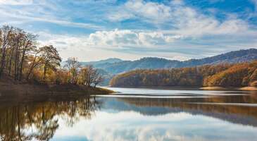 Bak&uuml;&rsquo;n&uuml;n modern sil&uuml;eti veya tarih&icirc; İ&ccedil;erişehir sokaklarının ardından &uuml;lkenin eşsiz doğal g&uuml;zelliklerini de keşfetmek ister misin? Hazar Denizi&rsquo;nden dağların karlı zirvelerine, ormanların yeşilinden buzul g&ouml;llerinin mavisine kadar Azerbaycan&rsquo;da d&ouml;rt mevsim keşfedebileceğin harika rotaları senin i&ccedil;in hazırladık. &Ouml;zellikle doğaseverler ve trekking tutkunlarının ilgisini &ccedil;ekecek olan yerlere birlikte g&ouml;z atalım.&nbsp; 1. Garanohur G&ouml;l&uuml; - Şahdağ Milli Parkı İsmayıllı b&ouml;lgesinin dağlık kesimlerinde yer alan Garanohur G&ouml;l&uuml;, Şahdağ Milli Parkı sınırları i&ccedil;inde yer alır. Saklı bir hazine olan g&ouml;le ulaşmak i&ccedil;in ormanların ve dik patikaların arasından ge&ccedil;men gerekir. Orta seviyedeki y&uuml;r&uuml;y&uuml;ş parkurlarının ardından g&ouml;le ulaşabilirsin. G&ouml;l&uuml;n berrak suları ve &ccedil;evresindeki ağa&ccedil;ların yansıması ortaya muhteşem bir manzara &ccedil;ıkarır. Doğanın i&ccedil;inde kafa dinlemek i&ccedil;in ideal bir nokta. Sonbahar aylarında muhteşem manzaralara sahip olan g&ouml;l&uuml;n etrafında piknik yapabilir, doğanın i&ccedil;inde ailecek keyifli vakit ge&ccedil;irebilirsin.&nbsp; Konum Linki {insightBoxStart}Yazar Notu: Bu rota, işaretli patikaların dışında kalabildiği i&ccedil;in ilk kez gideceksen yanına yerel bir rehber almanı ya da GPS rotalarını &ouml;nceden indirerek internet &ccedil;ekmeyen yerlerde de &ccedil;evrimdışı kullanmanı tavsiye ederiz.{insightBoxEnd} 2. Khanbulan G&ouml;l&uuml; - Hirkan Milli Parkı Lenkeran şehrinde yer alan Khanbulan G&ouml;l&uuml;, Hirkan ormanlarının &ccedil;evrelediği b&uuml;y&uuml;leyici bir g&ouml;l. Sonbahar aylarında kırmızı, turuncu ve sarı renkli yapraklar b&uuml;y&uuml;leyici bir manzara sunarken ağa&ccedil;ların suya yansıyan g&ouml;r&uuml;nt&uuml;s&uuml; ise adeta bir tabloyu andırır. G&ouml;l kenarında y&uuml;r&uuml;y&uuml;ş yapabilir, &ccedil;evredeki mekanlarda meşhur demli &ccedil;aydan i&ccedil;ebilirsin.&nbsp; Konum Linki 3. Narenciye Vadisi - Lenkeran Azerbaycan&rsquo;ın subtropikal iklime sahip g&uuml;ney b&ouml;lgesi Lenkeran, narenciye bah&ccedil;eleriyle &uuml;nl&uuml;. Narenciye Vadisi ise b&ouml;lgenin vitamin deposu olarak anılır. Kış aylarına girerken hasat zamanı geldiğinde b&ouml;lgede limon, mandalina, greyfurt ve portakal ağa&ccedil;ları hem g&ouml;r&uuml;nt&uuml; olarak hem de lezzet olarak ziyaret&ccedil;ilerin ilgisini &ccedil;eker. Burada limon&nbsp; ve kaymak meyvesi (fejioya) gibi narenciyelerden toplayarak farklı bir deneyim yaşayabilirsin. Yerel halkın misafirperverliği eşliğinde narenciye bah&ccedil;elerini gezebilir, taze toplanmış meyvelerin tadına bakabilir ve aynı zamanda b&ouml;lgenin tarım k&uuml;lt&uuml;r&uuml;n&uuml; deneyimleyebilirsin.&nbsp; Narenciye Vadisi'nde re&ccedil;el ve konserve satın alabilir, Lenkeran B&ouml;lgesi&rsquo;nin meşhur lezzetlerini pişirebileceğin etkinliklere katılabilirsin.&nbsp; Konum Linki 4. Nilado &Ccedil;ay Plantasyonu - Lenkeran Azerbaycan&rsquo;ın &ccedil;ay k&uuml;lt&uuml;r&uuml;n&uuml;n merkezi olarak bilinen Nilado &Ccedil;ay Plantasyonu, Lenkeran&rsquo;da yer alıyor. Sabah saatlerinde sisli havası ile muhteşem manzaralar sunan plantasyonda, u&ccedil;suz bucaksız yeşil &ccedil;ay yaprakları arasında y&uuml;r&uuml;yebilir, &ccedil;ay toplama s&uuml;recini g&ouml;zlemleyebilir ve &ccedil;ayın nasıl işlendiğini burada g&ouml;rebilirsin.&nbsp; B&ouml;lgenin nemli ve ılıman iklimi sayesinde burada yetişen &ccedil;aylarda yumuşak bir aroma tadı gelir. Nilado &Ccedil;ay Plantasyonu&rsquo;na gittiğinde bir fincan taze demlenmiş &ccedil;ay ile geleneksel re&ccedil;elleri denemeden d&ouml;nmemelisin. 5. Hirkan Milli Parkı Talış Dağları'nın g&uuml;ney yama&ccedil;larında bulunan Hirkan Milli Parkı, UNESCO D&uuml;nya Mirası Listesi&rsquo;nde yer alan Hyrcanian Ormanları&rsquo;nın bir par&ccedil;ası. D&uuml;nyada ender bulunan Demir Ağacı gibi 150'den fazla endemik bitki t&uuml;r&uuml;ne ve nesli t&uuml;kenmekte olan Kafkas Leoparı'na ev sahipliği yapıyor. Hyrcanian Ormanları&rsquo;nın tarihi, Kuzey Ilıman b&ouml;lgesinin &ccedil;oğunu kapladıkları 25 ila 50 milyon yıl &ouml;ncesine dayanır. Burada yer alan en yaşlı ağa&ccedil;ların genellikle 300-400 yaşında, bazı ağa&ccedil;ların ise 500 yaşında olduğu tahmin ediliyor. Hirkan Milli Parkı&rsquo;nda doğa y&uuml;r&uuml;y&uuml;şleri yapabilir, biyolojik &ccedil;eşitlilik a&ccedil;ısından Azerbaycan&rsquo;ın en zengin b&ouml;lgesinde kuş g&ouml;zlemciliği yapabilirsin. Milli parkta geniş yapraklı ılıman ormanlara &ouml;zg&uuml; 180 kuş t&uuml;r&uuml; ve 58 memeli t&uuml;r&uuml;n&uuml; g&ouml;rebilirsin.&nbsp; Konum Linki 6. Şirvan Milli Parkı Hazar Denizi kıyısında uzanan yarı &ccedil;&ouml;l ve step ikliminin h&acirc;kim olduğu Şirvan Milli Parkı, Kura-Araz ovaları boyunca uzanır. Flamingolar başta olmak &uuml;zere 270'den fazla kuş t&uuml;r&uuml;n&uuml; burada g&ouml;zlemleyebilirsin. Sarı otlar ve mavi g&ouml;ller nedeniyle Şirvan Milli Parkı, doğa tutkunlarına farklı deneyimler yaşatıyor. Park aynı zamanda ceylan s&uuml;r&uuml;leriyle de dikkat &ccedil;ekiyor. Şirvan Milli Parkı&rsquo;nda birbirinden g&uuml;zel doğa fotoğrafları &ccedil;ekebilirsin. Konum Linki 7. Şahdağ Turizm Kompleksi Şahdağ Dağ Tatil Kompleksi (Şahdağ Turizm Kompleksi), Kusar (Qusar) b&ouml;lgesinde yer alıyor. Burası, Azerbaycan&rsquo;ın ilk ve en b&uuml;y&uuml;k kış turizmi merkezi. Modern kayak pistleri, l&uuml;ks oteller ve d&uuml;nya standartlarında yapılmış g&uuml;venilir teleferik sistemleri ile hem profesyonel hem de deneyimsiz kayak&ccedil;ılara hitap ediyor. Kış tatili i&ccedil;in m&uuml;kemmel bir adres olan Şahdağ Turizm Kompleksi&rsquo;ne yaz aylarında giderek yama&ccedil; paraş&uuml;t&uuml; ve dağ bisikleti gibi aktivitelere de katılabilirsin.&nbsp; Konum Linki {insightBoxStart}Yazar Notu: &Ouml;zellikle s&ouml;mestir ve yılbaşı d&ouml;nemlerinde ziyaret&ccedil;i sayısı artar. Bu nedenle konaklama ve ekipman kiralama i&ccedil;in en az 3-4 hafta &ouml;ncesinden rezervasyon yaptırmanı &ouml;neririz.{insightBoxEnd} 8. Tufandağ Dağ Tatil Kompleksi Kafkas Dağları&rsquo;nın eteklerinde yer alan Tufandağ Dağ Tatil Kompleksi, Gabala kentinde yer alır. Huzur dolu atmosferinde dinlenebilir ya da eğlenceli aktivitelerle keyifli vakit ge&ccedil;irebilirsin. Teleferikle dağın zirvesine &ccedil;ıkarak muhteşem manzaralar g&ouml;rebilirsin. Farklı zorluklarda ve yaklaşık 12 kilometre uzunluğundaki pistlerde kayak yapabilir, kar motorlarında heyecan dolu anlar yaşayabilirsin. Dilersen dağın zirvesinde yer alan kafelerde sıcak &ccedil;ikolata i&ccedil;erek manzaranın tadını &ccedil;ıkarabilirsin.&nbsp; B&ouml;lgenin en heyecan verici aktivitesi ise zirvede yer alan Uyuyan G&uuml;zel adlı dağ salıncağı diyebiliriz. 7 ve 20 metre y&uuml;kseklikte iki salıncakta unutulmaz anlar yaşayabilirsin.&nbsp; Konum Linki 9. Lenkeran kaplıcaları Termal tatil seviyorsan Lenkeran&rsquo;ın Haftoni ormanlarında yer alan termal kaynaklar tam sana g&ouml;re. "İstisu" (Sıcak Su) olarak bilinen bu kaplıcalar, sağlık turizmi ile b&ouml;lgeye &ccedil;ok sayıda ziyaret&ccedil;i &ccedil;ekiyor. Doğal jeotermal kaynaklarda bedenini dinlendirebilir ve stresten arınabilirsin. Doğa ile i&ccedil; i&ccedil;e ve yeşil ormanlarla kaplı tesislerde konforlu bir konaklama deneyimi yaşayabilirsin.&nbsp; Konum Linki 10. Kış pazarları - Bak&uuml;&nbsp; 2013 yılından bu yana Nargis Vakfı tarafından d&uuml;zenlenen Soğuk Eller, Sıcak Kalpler pazarı, Bak&uuml;&rsquo;n&uuml;n kalbi &Ccedil;eşmeler Meydanı&rsquo;nda kuruluyor. Meydan ışıklı s&uuml;slemelerle donatılırken el yapımı hediyelik eşyalar, y&ouml;resel tatlılar ve sıcak i&ccedil;ecekler pazarın ruhuna uygun ahşap kul&uuml;belerde satılıyor.&nbsp; Bak&uuml;&rsquo;n&uuml;n modern atmosferi ile geleneksel pazar k&uuml;lt&uuml;r&uuml;n&uuml;n harmanlandığı bu etkinlik yeni yıl ruhunu yaşamak isteyenlere de hitap ediyor.&nbsp; Konum Linki 11. Ağbulaq Rekreasyon Merkezi Nah&ccedil;ıvan &Ouml;zerk Cumhuriyeti&rsquo;ne yaklaşık 50 kilometre mesafedeki Şahbuz il&ccedil;esinde yer alan Ağbulaq Rekreasyon Merkezi, yorgunluğunu atmak ve kış tatili yapmak isteyenlere hitap ediyor. Temiz dağ havası ve huzurlu atmosferi ile &ouml;ne &ccedil;ıkıyor. Toplamda 1.500 metre uzunluğundaki pistleri ile hem profesyonel hem de yeni başlayan kayak&ccedil;ıların ilgisini &ccedil;ekiyor. B&ouml;lgede kayak pistinin yanı sıra teleferik, kayak eğitim alanı, eğlence ve &ccedil;ocuk parkları bulunuyor. Rekreasyon merkezinde konaklayabileceğin bir otel, muhteşem manzara eşliğinde yemek yiyebileceğin restoran ve sıcak bir şeyler i&ccedil;erek i&ccedil;ini ısıtabileceğin kafe-bar alanı hizmet veriyor. Konum Linki 12. Khinalig (Xınalıq) - Galakhudat rotası Kış mevsiminde y&uuml;r&uuml;y&uuml;ş&ccedil;&uuml;lerin en sevdiği y&uuml;r&uuml;y&uuml;ş rotalarından biri olan Galakhudat parkuru, Khinalig (Xınalıq) b&ouml;lgesinden başlar. Trekking tutkunlarının ilgisini &ccedil;eken yaklaşık 8,2 kilometre uzunluğundaki parkur 2.300 metre maksimum rakımı ile dikkat &ccedil;eker.&nbsp; Parkurun bazı kısımlarda bulutların &uuml;zerinde y&uuml;r&uuml;yormuş gibi hissedeceksin. Ayrıca y&uuml;r&uuml;y&uuml;ş sırasında Kafkas Dağları&rsquo;nın muhteşem manzarasını g&ouml;rebilir, birbirinden g&uuml;zel fotoğraflar &ccedil;ekebilirsin.&nbsp; Ek olarak parkur boyunca Kızılgaya Dağı'nın karla kaplı zirvelerini ve Gudyalchay Vadisi'nin u&ccedil;suz bucaksız kanyonlarını g&ouml;rebilirsin. Ayrıca UNESCO D&uuml;nya Mirası Listesi'nde yer alan Kınalık K&uuml;lt&uuml;rel Peyzajı ve K&ouml;&ccedil; Yolu&rsquo;nu da deneyimleyebilirsin.&nbsp; {insightBoxStart}Yazar Notu: Khinalig (Xınalıq) k&ouml;y&uuml;ne giden yol olduk&ccedil;a virajlı ve sarp olduğundan kış aylarında tek başına kendi aracınla gitmemen tavsiye edilir. Bunun yerine b&ouml;lgeyi bilen şof&ouml;rlerin kullandığı 4x4 ara&ccedil;ları veya rehberli turları tercih edebilirsin.{insightBoxEnd} 13. Laza - K&uuml;z&uuml;n rotası Doğa y&uuml;r&uuml;y&uuml;ş&uuml; seviyorsan ancak &ccedil;ok uzun parkurlardan korkuyorsan Laza-K&uuml;z&uuml;n rotasını deneyebilirsin. Yaklaşık 6,5 kilometre uzunluğundaki y&uuml;r&uuml;y&uuml;ş parkurunu ortalama 3 saatte tamamlayabilirsin. Y&uuml;r&uuml;y&uuml;ş boyunca seni etkileyici doğa manzaraları karşılıyor. &Ouml;zellikle kış aylarında Laza k&ouml;y&uuml;ndeki şelalelerin donmasıyla ortaya &ccedil;ıkan buz duvarlar b&uuml;y&uuml;leyici bir g&ouml;r&uuml;nt&uuml; oluşturuyor.&nbsp; İlk tırmanıştan sonra Gizilgaya ve Şahdağ Dağları'nın karlı zirvelerini ve Gusarchay Vadisi&rsquo;nin manzarasını g&ouml;receksin. Bu noktadan sonra ise parkur genellikle aşağı doğru indiğinden kolay bir şekilde bitirebilirsin. 14. Yergi Kek - K&uuml;z&uuml;n rotası Şahdağ Milli Parkı sınırları i&ccedil;inde yer alan K&uuml;z&uuml;n rotası, deneyimli y&uuml;r&uuml;y&uuml;ş&ccedil;&uuml;lere hitap ediyor. Yergi Kek ge&ccedil;idinden başlayan parkur K&uuml;z&uuml;n k&ouml;y&uuml;ne doğru devam ediyor. Manzarası ile etkileyen y&uuml;ksek noktaları ve el değmemiş doğası ile zorlayıcı bir rota olsa da sonunda değdiğini anlayacaksın. Şehrin g&uuml;r&uuml;lt&uuml;s&uuml;nden uzakta ve sessizlikte huzur dolu vakitler ge&ccedil;irebilirsin. 15. Sim K&ouml;y&uuml; Lenkeran&rsquo;a yakın mesafede yer alan Sim K&ouml;y&uuml;&rsquo;nde Talış Dağları&rsquo;nın muhteşem manzaralarını g&ouml;rebilirsin. Sonbaharda sarı, turuncu ve kırmızı yaprakların oluşturduğu eşsiz g&ouml;r&uuml;nt&uuml;y&uuml; fotoğraflayabilirsin. K&ouml;yde d&uuml;zenlenen y&uuml;r&uuml;y&uuml;ş turlarına katılarak binlerce yıllık ağa&ccedil;, kaya ve tarih&icirc; kalıntıları g&ouml;rme fırsatı elde edebilirsin. Hirkan Milli Parkı i&ccedil;inde yer alan k&ouml;y&uuml;n ormanları ve şelalesi şehir stresinden uzakta huzurlu bir atmosfer sunuyor. K&ouml;yde dolaşırken Beyaz K&ouml;pr&uuml;&rsquo;de mola verip nehir manzarası eşliğinde Astara &ccedil;ayını ve yerel lezzetleri deneyebilirsin. Konum Linki 16. Gurgur Şelalesi Guba B&ouml;lgesi'nde bulunan Gurgur Şelalesi, Griz Şelalesi olarak da biliniyor. Griz k&ouml;y&uuml;ne 2,8 kilometre mesafede bulunuyor. Kış aylarında soğuk havanın etkisiyle donarak etkileyici bir manzaraya sahip oluyor. D&ouml;rt mevsim b&uuml;y&uuml;leyici bir ortam sunan Gurgur Şelalesi&rsquo;nde masalsı fotoğraflar &ccedil;ekebilirsin.&nbsp; {insightBoxStart}Yazar Notu: K&ouml;yden şelaleye doğrudan giden bir y&uuml;r&uuml;y&uuml;ş rotası bulunmuyor. Zorlu ve tehlikeli bir yola sahip olduğundan yalnızca arazi ara&ccedil;larının kullanımına izin veriliyor. Rahat ve g&uuml;venilir bir şekilde şelaleyi keşfetmek i&ccedil;in yerel rehberden yardım almanı tavsiye ederiz.{insightBoxEnd} Konum Linki 17. Beşparmak Dağı Bak&uuml;-Kuba yolu &uuml;zerinde bulunan ve bir elin parmaklarını andıran ilgin&ccedil; kaya oluşumları ile dikkat &ccedil;eken Beşparmak Dağı, Azerbaycan&rsquo;ın pop&uuml;ler gezi rotaları arasında yer alır. Beşparmak Dağı, &ccedil;ok sayıda efsaneye konu olduğundan yerel halk ve turistler tarafından kutsal bir yer olarak da ziyaret edilir. Tepeye &ccedil;ıktığında Hazar Denizi&rsquo;nin muhteşem manzarasını izleyebilirsin. Burada doğa y&uuml;r&uuml;y&uuml;şleri yapabilir, yama&ccedil; paraş&uuml;t&uuml; gibi heyecan dolu aktivitelere de katılabilirsin.&nbsp; Konum Linki 18. Şeki Yaylası ve Xanland&nbsp; Tarih&icirc; İpek Yolu şehirlerinden olan Şeki, doğa aktiviteleri ile dikkat &ccedil;eker. Yemyeşil yaylalarında y&uuml;r&uuml;y&uuml;ş yapabilir, ruhunu dinlendirebilirsin. Adrenalin tutkunlarına hitap eden uzun zipline hatlarıyla Xanland&rsquo;da eğlenceli vakitler ge&ccedil;irebilirsin.&nbsp; Konum Linki 19. G&uuml;rg&uuml;r (Qriz) Şelalesi Kuba (Quba) b&ouml;lgesinin en sarp kayalıklarında, Qriz k&ouml;y&uuml; yakınlarında bulunan G&uuml;rg&uuml;r Şelalesi, ulaşımı zor olsa da manzarası ile yorulmana değiyor. Kışın tamamen donarak devasa buz sarkıtlarına d&ouml;n&uuml;şen şelale ziyaret&ccedil;ilerin ilgisini &ccedil;eker. B&ouml;lgeye kendi aracınla giderek konforlu ve pratik bir şekilde ulaşım sağlayabilirsin. {insightBoxStart}İpucu: ENUYGUN.com&rsquo;dan kolayca u&ccedil;ak bileti alabilir, dilediğin yeri uygun fiyatlarla keşfedebilirsin. Şimdi seyahatinin ilk adımı olan Azerbaycan u&ccedil;ak bileti almak i&ccedil;in tıkla.{insightBoxEnd} {flight_search_form_banner} 20. G&ouml;yg&ouml;l G&ouml;l&uuml; ve Milli Parkı Azerbaycan&rsquo;ın en ikonik doğal g&uuml;zellikleri arasında yer alan, b&uuml;y&uuml;k bir depremin ardından Kepez Dağı'nın yamacının &ccedil;&ouml;kmesiyle meydana gelen G&ouml;yg&ouml;l G&ouml;l&uuml;, yeşil ve maviyi bir arada g&ouml;rebileceğin bir doğa harikası. G&ouml;yg&ouml;l Milli Parkı sınırlarında yer alan ve sık ormanların ortasında bulunan g&ouml;l, muhteşem manzaralar sunuyor. G&ouml;l&uuml;n &ccedil;evresinde y&uuml;r&uuml;y&uuml;ş yapabilir, g&ouml;l kenarında oturarak doğa sesleri arasında huzur bulabilirsin.&nbsp; Konum Linki {insightBoxStart}Yazar Notu: G&ouml;yg&ouml;l Milli Parkı, &ccedil;ok katı kurallar ile korunuyor. G&ouml;lde y&uuml;zmek ve suya girmek kesinlikle yasak. Manzarayı ise sadece belirlenen alanlarda izleyebilirsin.{insightBoxEnd} BONUS: Bak&uuml; kış festivalleri Kış aylarında Bak&uuml;, ışıklarla s&uuml;slenmiş bir festival şehrine d&ouml;n&uuml;şerek ziyaret&ccedil;ilerini b&uuml;y&uuml;ler. Bulvar boyunca uzanan rengarenk ışıklandırmalar, Alev Kuleleri'nin ışık g&ouml;sterileri ve şehrin d&ouml;rt bir yanındaki konserler kış aylarında ziyaret&ccedil;ilere unutulmaz anılar biriktireceği ortamlar yaratır. Bak&uuml;&rsquo;de modern sanat galerilerini gezebilir, m&uuml;zelerde &uuml;lkenin tarih&icirc; ve k&uuml;lt&uuml;rel zenginliğini keşfedebilirsin. Doğal g&uuml;zellikleri keşfettikten sonra Azerbaycan&rsquo;da gezilecek yerler yazımızı okuyarak g&uuml;zel bir gezi rotası oluşturabilirsin.&nbsp;