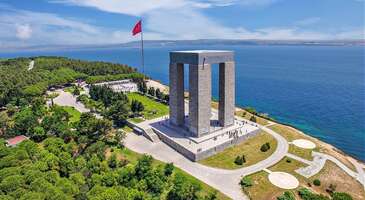 &Ccedil;anakkale&rsquo;nin en anlamlı yerlerinden biri olan Gelibolu, milli m&uuml;cadelenin nice hikayeler yarattığı yakın tarihimizde &ccedil;ok değerli bir yere sahip. Burada &Ccedil;anakkale ruhunu kalbinin derinliklerinde hissedebilir ve Gelibolu Yarımadası&rsquo;nın her bir k&ouml;şesinde ortaya konulan b&uuml;y&uuml;k m&uuml;cadelenin izlerini s&uuml;rebilirsin. Anzak Koyu&rsquo;ndan Gelibolu Tarihi Milli Parkı&rsquo;na, Savaş M&uuml;zesi&rsquo;nden Gelibolu Şehirler Abidesi&rsquo;ne tarih dolu bir gezi listesi seni bekliyor. Gelibolu ayrıca deniz ve kamp tatili i&ccedil;in de favori destinasyonlardan. Hazırsan hem en g&uuml;zel durakları keşfetmeye hem de Gelibolu hakkında sorulan sorulara yanıt vermeye başlayalım. Gelibolu&rsquo;nun &ouml;nemi nedir? &Ccedil;anakkale Savaşlarının en kritik anlarının yaşandığı Gelibolu, Avrupa'ya ge&ccedil;iş i&ccedil;in bir k&ouml;pr&uuml; vazifesi g&ouml;r&uuml;r. Bu sebeple Osmanlı Devletinin deniz &uuml;ss&uuml; haline gelerek Osmanlı'nın Akdeniz'e a&ccedil;ılan kapısı olur. Gelibolu&rsquo;nun nesi meşhur? Gelibolu tarihi ve doğası ile olduğu kadar peynir helvası, sardalya kebabı, lakerda, tuzlu balık, lakerda ve lokumu ile meşhur. Gelibolu&rsquo;da deniz var mı? Evet, Gelibolu&rsquo;da denize girilecek bir&ccedil;ok yer var. Fatma Kadın plajı, Hamzabey, Feneraltı, Morto Koyu, K&ouml;m&uuml;r Limanı gibi yerlerde denize girebilirsin. 1. Gelibolu Yarımadası Tarihi Milli Parkı Gelibolu denildiği zaman akla gelen ilk yerlerden biri hi&ccedil; ş&uuml;phesiz ki Gelibolu Yarımadası Tarihi Milli Parkı. &Ccedil;anakkale Savaşı&rsquo;na ev sahipliği yapmasından dolayı manevi a&ccedil;ıdan &ouml;zel bir konuma sahip olan park, sadece anıtlarıyla değil aynı zamanda tabiat g&uuml;zellikleriyle de biliniyor. &Ccedil;anakkale ruhunu &ouml;nemli &ouml;l&ccedil;&uuml;de yansıtan Gelibolu Yarımadası Tarihi Milli Parkı, 1973 senesinde resmi olarak a&ccedil;ıldı. BM Milli Parklar ve Koruma Alanları listesinde de kendine yer bulmayı başaran bu &ouml;nemli b&ouml;lge, toplamda 33 bin hektarlık bir alana yayılıyor. Deniz ve kara muharebe alanlarını da i&ccedil;ine alan parkta 60 bin T&uuml;rk askerinin mezarı yer alıyor. Konum Linki {calismasaatleri}Giriş &uuml;creti &Uuml;cretsiz A&ccedil;ık olduğu saatler Her g&uuml;n 08.30 ile 17.30 saatleri arasında ziyaret edilebilir.{/calismasaatleri} {insightBoxStart}Yazar Notu: Alan &ccedil;ok b&uuml;y&uuml;k olduğu i&ccedil;in burayı rehber eşliğinde gezmeni tavsiye ediyoruz.{insightBoxEnd} 2. Gelibolu Savaş M&uuml;zesi Gelibolu&rsquo;ya geldiğinde b&ouml;lgenin hemen hemen her b&ouml;lgesinde &Ccedil;anakkale Savaşı&rsquo;ndan bir ize rastlaman olası. Yakın tarihimizde kritik bir &ouml;neme sahip olan savaştan bug&uuml;ne miras kalan pek &ccedil;ok materyal, Gelibolu Savaş M&uuml;zesi&rsquo;nde ziyaret&ccedil;ilerle buluşuyor. Feribot iskelesine son derece yakın bir konumda olan m&uuml;ze zırhlar, şarapnel par&ccedil;aları ve top mermileri başta olmak &uuml;zere o d&ouml;nemden kalan orijinal par&ccedil;aları bir araya getiriyor. Savaş koşullarını &ccedil;ok daha iyi anlamak adına iyi bir fırsat sunan Gelibolu Savaş M&uuml;zesi, sadece yabancı ziyaret&ccedil;ilerden de ilgi g&ouml;r&uuml;yor. Ge&ccedil;tiğimiz y&uuml;zyılın başlarındaki savaş teknolojisini &ouml;nemli oranda yansıtan m&uuml;zede askerlere ait orijinal mektuplar ve giysiler de yer alıyor. Konum Linki {calismasaatleri}Giriş &uuml;creti Tam 3 TL &Ouml;ğrenci 1 TL A&ccedil;ık olduğu saatler Pazartesi hari&ccedil; 09.30 ile 19.00 saatleri arasında ziyaret edilebilir.{/calismasaatleri} 3. Gelibolu Şehitler Abidesi &Ccedil;anakkale Şehitler Abidesi, T&uuml;rkiye&rsquo;de yaşayan her bireyin yakın tarihle y&uuml;zleşmek adına mutlaka ziyaret etmesi gereken bir yer. Boğazın ucundaki Morto Koyu adı verilen alanda konumlanan Gelibolu Şehitler Abidesi, &Ccedil;anakkale Savaşı&rsquo;nda yaşamını yitiren şehitlerin anısına yapılmış. Tam olarak Hisarlık Tepesi&rsquo;ne yapılan bu kutsal yapı, 4 ayağa ve 1 kubbeye sahip. Abidenin toplam uzunluğu ise yaklaşık olarak 41 metre civarında. Feridun Kip ve İsmail Utkular imzasıyla v&uuml;cuda getirilen bu etkileyici yapının temeli 1954 senesinde atılmış. Resmi a&ccedil;ılışı ise tam 6 sene sonra ger&ccedil;ekleşmiş. &Ccedil;anakkale Şehitler Abidesi&rsquo;ne giderken uzaktan b&uuml;y&uuml;k bir &ldquo;M&rdquo; harfi dikkatini &ccedil;ekecektir. Bu harf, Mehmet&ccedil;ik&rsquo;in M&rsquo;sini temsil ediyor. Tavan b&ouml;l&uuml;m&uuml;nde mozaik şeklinde işlenen b&uuml;y&uuml;k bir T&uuml;rk bayrağı yer alıyor. Ayrıca Mehmet Akif Ersoy&rsquo;un &Ccedil;anakkale şehitleri i&ccedil;in yazdığı şiirin bulunduğu &ouml;zel bir lahit taşı da ziyaret&ccedil;ilerin ilgisini &ccedil;ekiyor. &Ccedil;anakkale Şehitler Abidesi&rsquo;nin ayaklarında yer alan r&ouml;lyeflerde ise hem kara hem de deniz savaşları betimleniyor. Konum Linki {insightBoxStart}Yazar Notu: Mustafa Kemal Atat&uuml;rk&rsquo;&uuml;n 19. T&uuml;men Komutanı Yarbay Mustafa Kemal olarak &ouml;nderlik yaptığı 57. Alayı da mutlaka ziyaret et. Ayrıca eski şehitlik kısmında yer alan Me&ccedil;hul Asker Anıtını da g&ouml;rmeni &ouml;neririz.{insightBoxEnd} 4. Gelibolu Mevlevihanesi Gelibolu&rsquo;da gezmeye değer yerlerden biri olan Gelibolu Mevlevihanesi, tarihi ve k&uuml;lt&uuml;rel kimliğiyle &ouml;n plana &ccedil;ıkıyor. 17&rsquo;nci y&uuml;zyılda inşa edilen bu &ouml;nemli yapı, o d&ouml;nemlerde &ccedil;ile &ccedil;ıkarma ya da dervişleri eğitme amacıyla oluşturulmuş. &Uuml;lkemizde yer alan diğer mevlevihanelere kıyasla buranın en geniş arazide kurulmuş mevlevihane olduğunu s&ouml;ylemek m&uuml;mk&uuml;n. Burası her sene geleneksel olarak Şeb-i Arus d&ouml;nemlerinde sema t&ouml;renlerine ev sahipliği yapıyor. Gelibolu Mevlevihanesi, Azade Mehmet Dede ve dervişlerinin girişimleri ile inşa edilmiş. &Ouml;zellikle semahane kısmı olduk&ccedil;a b&uuml;y&uuml;k olan yapı, bir d&ouml;nem askeri b&ouml;lge i&ccedil;erisinde kalmasına rağmen yapılan restorasyon sayesinde yeniden turizme a&ccedil;ılmış. 1994 yılında restore edilen Gelibolu Mevlevihane&rsquo;sinin bir kısmı semahane ve t&uuml;rbe, diğer bir b&ouml;l&uuml;m&uuml; dedeler mezarlığı olarak kullanılıyor. Konum Linki 5. Anzak Koyu Gelibolu&rsquo;nun en &ouml;nemli yerlerinden biri olan Anzak Koyu, savaş yılları i&ccedil;in sembolik bir &ouml;neme sahip. Hatırlanacağı &uuml;zere o zorlu yıllarda Anzaklar b&ouml;lgeyi b&uuml;t&uuml;n&uuml;yle işgal etmişti. Dolayısıyla koyun yer aldığı b&ouml;lgede &ccedil;ok ciddi &ccedil;atışmalar yaşanmıştı. G&uuml;n&uuml;m&uuml;zde bile Anzak Koyu i&ccedil;erisinde dolaştığında o yıllardan belli izlere rastlamak olası. Bu durum, Anzak Koyu&rsquo;nun tarihsel boyutunu yansıtıyor. Avustralyalılar i&ccedil;in de bu koy son derece farklı bir anlama sahip. Bu nedenle sene boyunca Yeni Zelanda veya Avustralya&rsquo;dan gelen turistlerle karşılaşabilirsin. B&ouml;lge aynı zamanda yaz aylarında denize girmek ve g&uuml;neşlenmek i&ccedil;in de kullanılıyor. &Ccedil;evrede yer alan koylara kıyasla buranın olduk&ccedil;a sakin bir plajı var. Arıburnu adı verilen tepelerle &ccedil;evrili olan plajın toplam uzunluğu 600 metre. Konum Linki {insightBoxStart}Yazar Notu: Koyda denize gireceksen, birka&ccedil; adım sonrasında derinleştiğini bilmelisin. Bu nedenle &ccedil;ocuklu aileler y&uuml;zmek i&ccedil;in bu koyu pek tercih etmiyor.{insightBoxEnd} 6. &Ccedil;impe Kalesi Gelibolu merkezine 12 km s&uuml;r&uuml;ş mesafesinde olan &Ccedil;impe Kalesi, Orhan Bey d&ouml;neminden kalmış. Aktarılan bilgilere g&ouml;re o d&ouml;nem kale, Bizanslılarca Osmanlılara hediye olarak sunulmuş. Bizans&rsquo;ın başında yer alan Kantakuzen, o senelerde Orhan Bey&rsquo;den destek ister. Yardım talebine karşılık verilir. Bunun &uuml;zerine de jest olarak Kantakuzen, kaleyi Osmanlılara verir. Kalenin en tepesine &ccedil;ıkarsan hem &Ccedil;anakkale Boğazı&rsquo;nı hem de Marmara Denizi&rsquo;ni geniş bir a&ccedil;ıdan g&ouml;rebilirsin. Tam olarak Kara Yokuş adı verilen alanda konumlanan &Ccedil;impe Kalesi, &ouml;zellikle Balkan fetihlerinde aktif olarak kullanılmış. Osmanlıların Rumeli&rsquo;ye yerleşmesinde bu kalenin &ouml;nemli bir rol&uuml; bulunuyor. Zira bu kaleden sonra Osmanlı, aynı b&ouml;lgede yer alan Gelibolu Kalesi&rsquo;ni de almayı başarıyor. Konum Linki {insightBoxStart}Yazar Notu: &Ouml;zel aracınla geliyorsan &Ccedil;anakkale-Edirne Yolu&rsquo;nu takip ederek ulaşım sağlamalısın.{insightBoxEnd} 7. K&ouml;m&uuml;r Limanı Saros K&ouml;rfezi&rsquo;nde konumlanan K&ouml;m&uuml;r Limanı, bilhassa dalgı&ccedil;ların uğrak yerlerinden biri. Suyun olduk&ccedil;a berrak olması dışında g&ouml;r&uuml;ş mesafesinin fazla olması da bu tercihin en &ouml;nemli gerek&ccedil;eleri. Limandan hemen birka&ccedil; metre sonra su ciddi d&uuml;zeyde derinleşiyor. Despot Limanı&rsquo;na da yakın konumda bulunan K&ouml;m&uuml;r Limanı&rsquo;na giden yol b&uuml;y&uuml;k &ouml;l&ccedil;&uuml;de topraklı. Uzun yıllar boyunca k&ouml;m&uuml;rlerin taşınmasına ev sahipliği yapmasından dolayı b&ouml;yle bir isimle anılıyor. Gelibolu merkezine yaklaşık 21 km uzaklıkta olan limanın &ccedil;evresi yeşillik alanlarla dolu. Liman &ccedil;evresindeki tabiat g&uuml;zellikleri ve eşsiz manzara, buraya yapılan ziyaretler i&ccedil;in &ouml;ncelikli motivasyonlar arasında. Bu arada dalış ya da sualtı sporlarına ilgin olduğu halde hen&uuml;z acemiysen, limanın bulunduğu alanda eğitim alabileceğin profesyonel okullar yoğunlukta. Limanın bulunduğu b&ouml;lgeye geldiğinde sevdiklerinle piknik yapabilir, manzaranın tadını &ccedil;ıkarabilir ya da dalış yapanları izleyebilirsin. &Ccedil;anakkale&rsquo;de denize girilecek yerler i&ccedil;in &ccedil;ok daha fazlasına linkten ulaşabilirsin. Konum Linki {insightBoxStart}Yazar Notu: Şehir merkezinden kalkan Değirmend&uuml;z&uuml; minib&uuml;slerini kullanarak limana ulaşabilirsin.{insightBoxEnd} 8. Gelibolu Deniz Feneri İl&ccedil;enin merkez b&ouml;lgesinde yer alan Gelibolu Deniz Feneri, pek &ccedil;ok yerden g&ouml;r&uuml;lebildiği i&ccedil;in sembolik noktalardan biri olarak kabul g&ouml;r&uuml;yor. Deniz Feneri &ccedil;evresinde yerli ve yabancı ziyaret&ccedil;ilerin vakit ge&ccedil;irebilecekleri &ccedil;ok sayıda kafe bulunuyor. Tarihi kaynaklar, Gelibolu Deniz Feneri&rsquo;nin yapım tarihinin 1856 olduğuna işaret ediyor. Fener denizden yaklaşık 35 metre y&uuml;kseklikte yer alıyor. Kule kısmının ise 9 metre olduğu biliniyor. Gelibolu Deniz Feneri&rsquo;nin yaydığı ılık 15 millik mesafeden g&ouml;r&uuml;lebiliyor. Fener aynı zamanda Hallacı Mansur T&uuml;rbesi&rsquo;ne de y&uuml;r&uuml;me mesafesinde bulunuyor. Emniyet Genel M&uuml;d&uuml;rl&uuml;ğ&uuml;, Gelibolu Deniz Feneri&rsquo;ni koruma altına almış durumda. Konum Linki {insightBoxStart}İpucu: Otob&uuml;s biletini ENUYGUN'dan kolayca alabileceğini unutma! Otob&uuml;s biletinde değişiklik ve iptal işlemlerini tek tıkla yapabilir, farklı firma ve seferleri karşılaştırabilirsin. Yola &ccedil;ıkmaya hazırsan Gelibolu otob&uuml;s bileti almak i&ccedil;in tıkla!{insightBoxEnd}&nbsp; 9. Azaplar Camii İl&ccedil;enin en eski dini mek&acirc;nlarından biri olan Azaplar Camii, 1407 senesinde inşa edilmiş. Yapımında Hacı Paşaoğlu İskender Bey&rsquo;in imzası bulunan tarihi cami, &ldquo;Gelibolu Azaplar Namazg&acirc;hı&rdquo; adıyla da biliniyor. En aktif olduğu d&ouml;nemlerde camide askerlerin sefere &ccedil;ıkmadan &ouml;nce toplu halde namaz kıldıkları biliniyor. Aynı zamanda hacca gidenleri uğurlamak ve yağmur duası yapmak i&ccedil;in de burası sıklıkla tercih edilen bir yermiş. Anadolu coğrafyasının en eski namazg&acirc;hlarından olan Azaplar Camii&rsquo;nin orijinal kitabesi bug&uuml;ne dek ulaşabilmiş durumda. Minber ve mihraplı şekilde inşa edilen namazgah, aynı zamanda bir a&ccedil;ık hava camisi. Diğer namazg&acirc;hlar gibi burası da olduk&ccedil;a yalın bir yapıya sahip. Konum Linki 10. Sinan Paşa T&uuml;rbesi Sinan Paşa T&uuml;rbesi, Gelibolu&rsquo;da Hamzak&ouml;y b&ouml;lgesinde yer alıyor. Burada, 2. Beyazıt&rsquo;ın damadı Sinan Paşa&rsquo;nın naaşı bulunuyor. Kendisi &ldquo;Rumeli Beylerbeyi&rdquo; olarak anılıyor. T&uuml;rbe hem 2. Mehmet hem de 3. Selim d&ouml;nemlerinde tadilattan ge&ccedil;irilmiş. Kaptan-ı Derya olarak bilindiği d&ouml;nemlerde Sinan Paşa, Gelibolu tersanelerinin gelişimine b&uuml;y&uuml;k katkılar sunmuş. Bu nedenle Gelibolu halkı i&ccedil;in olduk&ccedil;a değerli bir isim. Eşi M&uuml;nire Sultan da aynı şekilde bu b&ouml;lgede yatıyor. Bu t&uuml;rbe, İstanbul &Uuml;sk&uuml;dar&rsquo;da yer alan Mimar Sinan T&uuml;rbesi ile zaman zaman karıştırılabiliyor. Konum Linki {insightBoxStart}İpucu: En iyi otel fiyatlarını tek bir yerde g&ouml;rmek, se&ccedil;eceğin otel hakkında bilgi almak ve saniyeler i&ccedil;inde rezervasyon yapmak i&ccedil;in ENUYGUN'da Gelibolu otelleri araştırmasına başlayabilirsin.{insightBoxEnd} {hotel_search_form_banner} 11. Fransız Mezarlığı ve Anıtı Fransız Mezarlığı ve Anıtı, Morto Koyu&rsquo;nu karşısına alan yamacın &uuml;st&uuml;nde bulunuyor. Anıtın resmi a&ccedil;ılışı 9 Haziran 1930 tarihinde ger&ccedil;ekleşmiş. Mimar A. George tarafından inşa edilen Fransız Mezarlığı ve Anıtı&rsquo;nda Senegal, Fas ve Cezayir gibi b&ouml;lgelerden gelen Fransız askerleri yatıyor. Gelibolu i&ccedil;erisindeki tek Fransız mezarlık anıtı olan bu b&ouml;lge, 4 ayrı b&ouml;l&uuml;mden meydana geliyor. Mezarlık aynı zamanda toplamda 140 metrelik bir uzunluğa sahip. Fransız Mezarlığı ve Anıtı&rsquo;nda, Kırım Savaşı&rsquo;nda hayatını kaybeden 5000 civarında Fransız askerin yer aldığı s&ouml;yleniyor. Konum Linki {insightBoxStart}Yazar Notu: Şehitlik Anıtı sonrasında yola devam edersen, sahil yolunda sol kısımda mezarlığı g&ouml;rebilirsin.{insightBoxEnd} {{campaignsSlider}} 12. Morto Koyu Morto Koyu, pek &ccedil;ok kişi tarafından İngilizlerin &Ccedil;anakkale Savaşı esnasında &ccedil;ıkartma yaptıkları b&ouml;lge olarak tanınıyor. Yarımadanın en &ouml;nemli sahillerinden biri olan Morto Koyu, aynı zamanda Şehitler Abidesi&rsquo;ne de olduk&ccedil;a yakın mesafede. İngilizlerin o d&ouml;nemde burayı &ldquo;S Plajı&rdquo; şeklinde kodladıkları biliniyor. Koy, Fransızlara devrildikten kısa bir s&uuml;re sonra Fransız gemisi olan Goliath&rsquo;a atılan 3 torpido, 570 denizcinin &ouml;l&uuml;m&uuml;ne neden oldu. Bu nedenle de Fransızlar koya, &ouml;l&uuml;m anlamında kullanılan &ldquo;Morto&rdquo; ismini vermeye başladı. G&uuml;n&uuml;m&uuml;zde ise Morto Koyu, sakin ve huzurlu bir atmosferde dinlenip tatil yapmak isteyenleri ağırlayan bir koy durumunda. Konum Linki 13. Fatma Kadın Plajı &Ccedil;anakkale&rsquo;nin İstanbul&rsquo;dan en &ccedil;ok misafir ağırlayan yerlerinden biri olan Fatma Kadın plajı yaz tatillerinin pop&uuml;ler duraklarından. Sığ denizi, ağa&ccedil;lık alanları, ekonomik tatil imkanı ve kamp yapmaya elverişli olması sebebiyle Fatma Kadın plajı her yaştan tatilciyi yaz d&ouml;neminde ağırlıyor. &Ccedil;anakkale&rsquo;nin kamp alanları i&ccedil;inde bir&ccedil;ok doğa severe kucak a&ccedil;an plajda yeme-i&ccedil;me alanları yer alıyor. Konum Linki {insightBoxStart}Yazar Notu: Fatma Kadın plajında &ccedil;ok miktarda deniz kestanesi yer alıyor. Burada denize girerken yanında mutlaka deniz ayakkabısı g&ouml;t&uuml;r.{insightBoxEnd} 14. Bayraklı Baba T&uuml;rbesi T&uuml;rkiye&rsquo;nin en ilgin&ccedil; t&uuml;rbelerinden biri Gelibolu sınırları i&ccedil;erisinde yer alıyor. Bayraklı Baba, şehir i&ccedil;in manevi a&ccedil;ıdan b&uuml;y&uuml;k bir değere sahip. Bu durumun temel nedeni, asıl adı Karacabey olan bir T&uuml;rk askerine dair anlatılan efsaneden kaynaklı. Bayraklı Baba efsanesine g&ouml;re, Karacabey Osmanlı ordusu i&ccedil;erisinde bayraktar olarak g&ouml;rev yapar. Savaş esnasında elindeki tuttuğu sancakla beraber d&uuml;şman askerleri tarafından k&ouml;şeye sıkıştırılır. Bayraklı Baba bayrağı d&uuml;şman askerine teslim etmek yerine par&ccedil;alayıp yutmayı tercih eder. O esnada d&uuml;şman askerleri, Osmanlı ordusu tarafından p&uuml;sk&uuml;rt&uuml;l&uuml;r. Birliğin komutanı ve diğer askerler, Karacabey&rsquo;in anlattığı hikayeye inanmaz. Bunun &uuml;zerine Karacabey midesini yarıp sancak par&ccedil;alarını g&ouml;sterir. &Ouml;lmeden &ouml;nce son s&ouml;zleri de &ldquo;Mezarımdan bayrak eksilmesin&rdquo; olur. Askerin bu vasiyeti hemen yerine getirilir. O g&uuml;nden bug&uuml;ne mezarı T&uuml;rk bayrakları ile donatılan Karacabey, &ldquo;Bayrak&ccedil;ı Baba&rdquo; adıyla anılıyor. Konum Linki {insightBoxStart}Yazar Notu:&nbsp;T&uuml;rbeye girerken hemen yan tarafta bayrak satışının yapıldığını g&ouml;rebilirsin.{insightBoxEnd} 15. Bebek Kayalıkları Gelibolu&rsquo;nun pek &ccedil;ok b&ouml;lgesinde dalış i&ccedil;in uygun destinasyonlar var. Eğer ilgin varsa, K&ouml;m&uuml;r Limanı gibi Bebek Kayalıkları adı verilen b&ouml;lgeyi de not alabilirsin. &Uuml;lkemizin en &ouml;nemli dalış noktalarından biri olarak kabul edilen Bebek Kayalıkları, dalış deneyimini bambaşka bir seviyeye &ccedil;ıkarıyor. Saros K&ouml;rfezi&rsquo;nde dalış i&ccedil;in en &ccedil;ok tercih edilen yerlerden biri olan bu kayalıklar, aynı zamanda berrak sularında &ccedil;ok sayıda bitki ve canlı t&uuml;r&uuml;ne de ev sahipliği yapıyor. &Ouml;zellikle de mercan resifleri ile denizanası kolonilerine rastlaman olduk&ccedil;a m&uuml;mk&uuml;n. Kayalıklara sadece dalış meraklıları değil sualtı fotoğraf&ccedil;ılığına ilgi duyanlar da b&ouml;lgeye akın ediyor. Bu arada Bebek Kayalıkları&rsquo;nın yer aldığı b&ouml;lgede bir zamanlar &ldquo;Agospatami Antik Kenti&rdquo; adı verilen bir şehrin yer aldığı rivayet ediliyor. Bebek Kayalıkları, ismini de o d&ouml;neme ilişkin mitolojik bir hik&acirc;yeden alıyor. Konum Linki {insightBoxStart}Yazar Notu:&nbsp;Bu alanda hizmet veren sandalcılar aracılığıyla kayalıklara ulaşabilirsin.{insightBoxEnd} 16. Piri Reis M&uuml;zesi Feribot iskelesine y&uuml;r&uuml;me mesafesinde olan Piri Reis M&uuml;zesi, sadece barındırdığı koleksiyonla değil aynı zamanda mimari &ouml;zg&uuml;nl&uuml;ğ&uuml;yle de &ouml;n plana &ccedil;ıkıyor. Kale g&ouml;r&uuml;n&uuml;m&uuml;nde olan m&uuml;zede &ccedil;ok sayıda değerli dok&uuml;man ve eser ziyaret&ccedil;ilerle buluşuyor. İki ayrı kattan meydana gelen Piri Reis M&uuml;zesi, &ouml;zellikle ikinci katındaki balmumu eserlerle dikkat &ccedil;ekiyor. M&uuml;zede Piri Reis&rsquo;in yaşamına ve kişisel &ccedil;alışmalarına dair belgeler ağırlıkta. &Ouml;zellikle Piri Reis&rsquo;in denizcilik alanında ger&ccedil;ekleştirdiği b&uuml;y&uuml;leyici &ccedil;alışmalar ve haritalar, mutlaka dikkatli bir şekilde incelenmeli. İlgili d&ouml;nemin denizcilik becerilerini ve koşullarını anlamak adına Piri Reis M&uuml;zesi &ouml;nemli bir fırsat sunuyor. Konum Linki {calismasaatleri}Giriş &uuml;creti &Uuml;cretsiz A&ccedil;ık olduğu saatler Her g&uuml;n 08.00 ile 17.00 saatleri arasında ziyaret edilebilir.{/calismasaatleri} 17. Antika Trakt&ouml;r M&uuml;zesi &Uuml;lkemizin ilk ve tek antika trakt&ouml;r m&uuml;zesine Gelibolu ev sahipliği yapıyor. Sadece Gelibolu&rsquo;nun değil aynı zamanda &Ccedil;anakkale&rsquo;nin en &ouml;zg&uuml;n ve renkli m&uuml;zelerinden biri olarak kabul edilen Antika Trakt&ouml;r M&uuml;zesi 1800&rsquo;l&uuml; yıllardan g&uuml;n&uuml;m&uuml;ze trakt&ouml;rlerin gelişimini g&ouml;zler &ouml;n&uuml;ne seriyor. D&uuml;nyanın farklı &uuml;lkelerinde &uuml;retilen &ccedil;ok sayıda trakt&ouml;r, kendi &ouml;zel hik&acirc;yeleri ile beraber bu m&uuml;zede ziyaret&ccedil;ilerle buluşuyor. Olduk&ccedil;a heyecan verici bir koleksiyona sahip olan m&uuml;zeye aslında Tarihi Sardalye Fabrikası ev sahipliği yapıyor. Bu fabrikanın onarılması ve d&uuml;zenlemesi sonucunda Antika Trakt&ouml;r M&uuml;zesi ortaya &ccedil;ıkmış. Antika Trakt&ouml;r M&uuml;zesi&rsquo;nde yer alan en eski trakt&ouml;r, 1886 senesine ait. Bu arada m&uuml;zenin, 2021 yılında &ldquo;En İyi D&uuml;zenlenmiş &Ouml;zel M&uuml;ze&rdquo; &ouml;d&uuml;l&uuml;n&uuml;n de sahibi olduğunu belirtelim. Konum Linki {calismasaatleri}Giriş &uuml;creti Kişi başı 50 TL İndirimli 25 TL A&ccedil;ık olduğu saatler Pazartesi haricinde 10.00 ile 17.00 saatleri arasında ziyaret edilebilir.{/calismasaatleri} 18. Saruca Paşa Hamamı Gelibolu&rsquo;nun en b&uuml;y&uuml;k hamamı olan Saruca Paşa Hamamı, ismini doğrudan banisinden alıyor. Saruca Paşa aynı zamanda Gelibolu Tersanesi&rsquo;ni de inşa ettiren isim olarak biliniyor. 1391 senesinde inşa edilen tarihi hamamda yer alan mermer &ccedil;izme, hamamın bir askerce inşa edildiğine dair işaret olarak kabul ediliyor. Fakat g&uuml;n&uuml;m&uuml;zde bu &ccedil;izmenin Gelibolu Tanıtım Merkezi adı verilen b&ouml;lgede sergilendiğini s&ouml;yleyelim. Kesme taş ve tuğlaların kullanıldığı Saruca Paşa Hamamı, halvet, sıcak ve soğuk olmak &uuml;zere 3 ayrı b&ouml;l&uuml;me sahip. Konum Linki &Ccedil;anakkale&rsquo;yi baştan başa keşfetmek i&ccedil;in &Ccedil;anakkale&rsquo;de gezilecek yerler rehberin linkte!