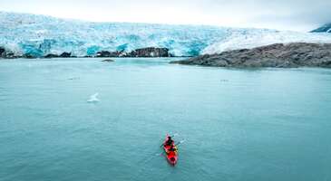 Buzullarla kaplı toprakları, kutup ayılarıyla &uuml;nl&uuml; vahşi yaşamı ve kuzey ışıkları ile b&uuml;y&uuml;leyen Svalbard, Arktik Okyanusu'nda yer alan Norve&ccedil;&rsquo;e bağlı takımada. Kuzey Kutbu'na sadece 1.000 kilometre mesafede yer bu ada, macera tutkunlarının ilgisini &ccedil;ekiyor. Takımadada ortalama 3.000 kişi yaşıyor. Buz gibi havalar tam bana g&ouml;re diyorsan hadi birlikte Svalbard&rsquo;ı keşfedelim.&nbsp; Svalbard hakkında Norve&ccedil;&rsquo;e bağlı Svalbard Takımadaları, Svalbard Antlaşması ile &ouml;zel bir stat&uuml;ye sahip. İdar&icirc; merkezi olan Longyearbyen, d&uuml;nya &uuml;zerindeki en kuzeyde bulunan idar&icirc; merkez. Svalbard, ana adası Spitsbergen olmak &uuml;zere bir&ccedil;ok k&uuml;&ccedil;&uuml;k adadan oluşuyor. Buzul &ccedil;ağından g&uuml;n&uuml;m&uuml;ze kadar ulaşan doğa harikalarına ev sahipliği yapan Svalbard'ın en &ouml;ne &ccedil;ıkan &ouml;zelliklerinden biri de burada insan n&uuml;fusundan &ccedil;ok kutup ayısının bulunması. Tehlikeli bir t&uuml;r olan kutup ayılarına karşı korunmak i&ccedil;in turist rehberlerinin ve yerel halkın yanında silah bulundurması gerekiyor.&nbsp; D&uuml;nyadaki b&uuml;t&uuml;n bitki tohumlarını saklandığı K&uuml;resel Tohum Deposu da Svalbard&rsquo;ta yer alıyor. Bu depo d&uuml;nya &uuml;zerinde k&uuml;resel bir felaket ya da mikroorganizmaları etkileyecek bir salgın yaşanması durumunda bitkilerin genetik &ccedil;eşitliliğini korumak amacıyla 2008 yılında kuruldu.&nbsp; Svalbard&rsquo;ta yılın yarısında gece diğer yarısında g&uuml;nd&uuml;z yaşanıyor. G&uuml;neşin nadir olarak g&ouml;r&uuml;ld&uuml;ğ&uuml; şehirde insanlar g&uuml;neş hasretini gidermek i&ccedil;in dağlık alanlara &ccedil;ıkarak kamp kuruyor.&nbsp; {insightBoxStart}İpucu: En iyi otel fiyatlarını tek bir yerde g&ouml;rmek, se&ccedil;eceğin otel hakkında bilgi almak ve saniyeler i&ccedil;inde rezervasyon yapmak i&ccedil;in ENUYGUN'da Longyearbyen otelleri araştırmasına başlayabilirsin.{insightBoxEnd} {hotel_search_form_banner} Svalbard&rsquo;a nasıl gidilir?&nbsp; Svalbard'a hava yolu veya deniz yoluyla ulaşım sağlayabilirsin. Deniz ulaşımı soğuk hava ve buzul suları nedeniyle &ccedil;ok sık ertelenmesinden dolayı genellikle u&ccedil;ak ile ulaşım tercih ediliyor. Buraya gitmek i&ccedil;in ilk olarak Norve&ccedil;'in başkenti Oslo ya da Troms&oslash; şehrine gitmen gerekiyor. Ardından direkt u&ccedil;uşlar ile Svalbard&rsquo;ın idari merkezi olan Longyearbyen&rsquo;a ulaşım sağlayabilirsin.&nbsp; Norwegian Air ve SAS hava yolları ile yapacağın u&ccedil;uşlar ortalama 1.5 saat s&uuml;r&uuml;yor.&nbsp; Svalbard iklim koşulları Svalbard&rsquo;a gideceksen en dikkat etmen gereken şey hava durumu olacak. Buzulların arasında gezinmeye ve - derecelere hazırlıklı olmalısın. Yanında mutlaka kar ayakkabıları, termal montlar ve iklime uygun kıyafetler olmalı. Takımadada, Arktik iklimi hakim. Mart ayında ortalama sıcaklıklar - 16 dereceye kadar d&uuml;şerken, temmuz ayında 5 veya 8 derecelere kadar y&uuml;kselebiliyor.&nbsp; Kış ayları olduk&ccedil;a uzun ve sert ge&ccedil;iyor, bu d&ouml;nemde kutup gecesi yaşanıyor ve g&uuml;neş neredeyse 6 ay boyunca doğmuyor. Yaz aylarında ise tam tersi bir durum yaşanıyor ve mayıstan eyl&uuml;l ayına kadar g&uuml;neş batmıyor. Yaz ayları Svalbard&rsquo;ı gezmek i&ccedil;in en ideal d&ouml;nemler. Bu aylarda buzlanma azaldığında doğa aktiviteleri ve y&uuml;r&uuml;y&uuml;şleri yapmak m&uuml;mk&uuml;n.&nbsp; {insightBoxStart}Yazar Notu: Svalbard, iklimine bağlı olarak ilgin&ccedil; bir yasakla anılıyor. Takımadada 1918 yılında yaşanan grip salgınında &ccedil;ok sayıda insan &ouml;l&uuml;yor. &Ouml;len insanların cenazeleri takımadaya g&ouml;m&uuml;l&uuml;yor. Ancak yıllar sonra bile cesetlerin &ccedil;&uuml;r&uuml;mediği g&ouml;ren y&ouml;netim hastalıkların yayılmasını &ouml;nlemek amacıyla Svalbard&rsquo;ta &ouml;lmeyi yasaklıyor. Yani takımadada &ouml;lme riski taşıyan ya da hastalanan kişiler Norve&ccedil;&rsquo;e g&ouml;nderiliyor.{insightBoxEnd} Svalbard&rsquo;ta yaşam T&uuml;m bu soğuk iklimine rağmen Svalbard&rsquo;ta yaşam normal bir yerleşim merkezine benzer şekilde devam ediyor. Svalbard&rsquo;ta alışveriş yapabileceğin d&uuml;kkanlar, eğitim g&ouml;rebileceğin bir &uuml;niversite ve eğlenebileceğin pek &ccedil;ok mekan bulunuyor.&nbsp; Svalbard&rsquo;ta trafik levhaları ve kuralları da bulunmuyor. Hava yılın b&uuml;y&uuml;k bir kısmında 0 derecenin altında olduğundan burada araba kullanımı pek yaygın değil. İnsanlar genellikle motorlu kar kızakları kullanıyor. Bu nedenle şehirde hi&ccedil; trafik oluşmadığından kurallara da gerek kalmıyor. Svalbard&rsquo;ta sokak ve cadde bilgisi de bulunmuyor. &Ouml;yle ki eğer bir kargo teslimi yapılacaksa gidip limandan almak gerekiyor. Balık ve su &uuml;r&uuml;nleri takımadada hem &ccedil;ok yaygın hem de diğer et &uuml;r&uuml;nlerine g&ouml;re daha ucuz. Bu nedenle Svalbard&rsquo;a gideceksen bol bol balık yiyeceğinin garantisini verebiliriz.&nbsp; Svalbard&rsquo;ta yapılacak aktiviteler Kuzey Kutbu&rsquo;na yakın mesafede yer alan Svalbard&rsquo;ta unutulmaz deneyimler yaşayabileceğin &ccedil;ok sayıda aktivite bulunuyor. Buzul mağaralarını keşfetmek, buzul duvarlarının eşsiz manzarasını izlemek, k&ouml;pekli kızaklarla ve kar ara&ccedil;larıyla safari yapmak en pop&uuml;ler aktiviteler arasında yer alıyor. Ayrıca eyl&uuml;l ayında giderek kuzey ışıklarını en iyi şekilde izleme fırsatı bulabilirsin. Kuzey ışıklarını karla kaplı geniş ovalarda Husky k&ouml;peklerinin &ccedil;ektiği kızaklarla yapacağın safarilerde ya da bot turları &uuml;zerinden izleyebilirsin. Bu b&uuml;y&uuml;leyici anlarda muhteşem fotoğraflar &ccedil;ekebilirsin. Bunun yanında kutup ayılarının doğal yaşam alanlarını da g&ouml;zlemleyebilirsin.&nbsp; Svalbard&rsquo;ta buzulları keşfetmenin yanı sıra ge&ccedil;miş yıllarda aktif olan ancak g&uuml;n&uuml;m&uuml;zde terk edilmiş halde duran madenleri gezebilirsin. Svalbard vizesiz mi? İşte en merak edilen soruya geldik. Evet, Svalbard tamamen vizesiz bir b&ouml;lge. Svalbard Antlaşması'nı imzalayan &uuml;lkelerin vatandaşları i&ccedil;in vize gerekmiyor. T&uuml;rkiye de bu antlaşmanın tarafı olduğu i&ccedil;in Svalbard'a vizesiz seyahat edebilirsin. Ancak burada &ouml;nemli bir detay var. Svalbard&rsquo;a gitmek i&ccedil;in &ouml;ncelikle Norve&ccedil;&rsquo;e gitmelisin. Bu durumda da Schengen vizesi gerekiyor.&nbsp; Seyahatin i&ccedil;in gerekli vize işlemlerini Norve&ccedil;'e g&ouml;re planlaman gerekiyor. Schengen vizesi aldıktan sonra Norve&ccedil;&rsquo;ten Svalbard&rsquo;a ge&ccedil;erken pasaportunun yanında olduğundan emin olmalısın.&nbsp; {insightBoxStart}Yazar Notu: Schengen vizesi alırken iki veya daha fazla girişli olmasına dikkat etmelisin. &Ccedil;&uuml;nk&uuml; ilk olarak Norve&ccedil;&rsquo;e giriş yapıp Svalbard&rsquo;a gittikten sonra d&ouml;n&uuml;şte tekrar Schengen B&ouml;lgesi olan Norve&ccedil;&rsquo;e giriş yapman gerekiyor. Bu nedenle Schengen vizenin en az 2 girişli olması son derece &ouml;nemli.{insightBoxEnd} {{campaignsSlider}} T&uuml;rkler oturum izni alabiliyor mu?&nbsp; Evet, artık T&uuml;rk vatandaşları Svalbard'ta oturum izni alabiliyor. 7 Mart 2025 tarihli Resmi Gazete'de yayımlanan Cumhurbaşkanı Kararı ile Spitsbergen (Svalbard) Antlaşması, T&uuml;rkiye&rsquo;de y&uuml;r&uuml;rl&uuml;ğe girdi. Anlaşma ile birlikte T&uuml;rk vatandaşları Svalbard&rsquo;ta m&uuml;lk edinme ve ik&acirc;met ile balık&ccedil;ılık ve madencilik alanlarında ticari faaliyetlerde bulunma ve bilimsel araştırma yapabilme hakkına sahip oldu. Oturum izni zorunluluğu olmadığı gibi, sınırsız kalış s&uuml;resi de m&uuml;mk&uuml;n. Ancak b&ouml;lgenin oturum izni konusunda kendi kuralları bulunuyor. Detaylı bilgi i&ccedil;in tıkla.&nbsp; Kolayca oturum alabilmek ve rahat bir yaşam s&uuml;rmek i&ccedil;in gitmeden &ouml;nce belirli bir maddi olanağa sahip olman gerekiyor. Ayrıca kolayca ev bulabilmek i&ccedil;in ilk olarak iş ayarlamanda fayda var. Svalbard&rsquo;a gideceksen Norve&ccedil;&rsquo;te gezilecek yerler yazımızı da mutlaka okumalısın.&nbsp;