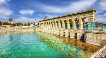 Beyşehir Konya'nın tarihi il&ccedil;elerinden. Zengin tarihi dokusu ve doğal g&uuml;zellikleriyle ziyaret&ccedil;ilerini zaman yolculuğuna &ccedil;ıkaran il&ccedil;e Beyşehir G&ouml;l&uuml;'n&uuml;n kıyısında yer alıyor. Eşrefoğlu Camii gibi Sel&ccedil;uklu mirasından, Kubadabad Sarayı'nın kalıntılarına, Hızır Bey Camii ve Medresesi'ne kadar bir&ccedil;ok tarihi değere ev sahipliği yapan Beyşehir'in doğa severler i&ccedil;in de g&uuml;zellikler sunuyor. Beyşehir&rsquo;de gezilecek yerleri keşfederken il&ccedil;eye dair detayları da &ouml;ğreneceksin. Hazırsan, bu g&uuml;zel il&ccedil;eyi keşfe başlayalım. Konya-Beyşehir arası ka&ccedil; kilometre? Konya ile Beyşehir arası yaklaşık 95 kilometre. Yaklaşık 1 saat yolculuk ile Konya&rsquo;dan Beyşehir&rsquo;e gidebilirsin. Beyşehir&rsquo;in eski adı nedir? Beyşehir&rsquo;in eski adı ilk&ccedil;ağda &lsquo;Pisidya&rsquo; idi. B&ouml;lgenin de adı olan Pisidya Isparta, Afyonkarahisar, Burdur, Antalya ve Konya&rsquo;yı temsil ediyordu. Beyşehir&rsquo;de ne yenir? Beyşehir Konya yemeklerini tadabileceğin iyi yerlerden. Fakat tahmin edilenin aksine Beyşehir&rsquo;de etli ekmek değil balık yemelisin. 1. Beyşehir G&ouml;l&uuml; Beyşehir G&ouml;l&uuml;, Konya ve &ccedil;evresine ferahlık veren ve doğa ile b&uuml;t&uuml;nleşme sağlayan eşsiz bir nokta. Bu b&uuml;y&uuml;leyici doğa harikası, sakin sularıyla ve huzur verici atmosferiyle, doğa severlerin ve fotoğraf tutkunlarının uğrak noktası olmayı başardı. G&ouml;l, etrafını saran yeşilin her tonuna ev sahipliği yaparken, misafirlerin i&ccedil;inde keşfetme arzusu uyandırıyor. G&uuml;n&uuml;n her saati farklı bir g&uuml;zelliğe b&uuml;r&uuml;nen bu yer, &ouml;zellikle g&uuml;n batımında adeta bir tablolardan fırlamış g&ouml;r&uuml;nt&uuml;s&uuml; ile bir&ccedil;ok kişiyi kendisine hayran bırakıyor. Beyşehir G&ouml;l&uuml;&rsquo;n&uuml;n manzarası, şehrin karmaşasından uzaklaşıp doğayla i&ccedil; i&ccedil;e olmak isteyenler i&ccedil;in adeta bir terapi gibi gelebilir. Beyşehir G&ouml;l&uuml;, aynı zamanda bir&ccedil;ok kuş t&uuml;r&uuml;ne ev sahipliği yapmasıyla da &uuml;nl&uuml;. Kuş g&ouml;zlemciliği, burada yapılabilecek en huzurlu aktivitelerden biri. Bu noktada kuşların cıvıltısı eşliğinde sabahın erken saatlerinde, y&uuml;r&uuml;y&uuml;ş yapmak da g&uuml;ne başlamak i&ccedil;in bire bir. Konum Linki 2. Beyşehir G&ouml;l&uuml; Milli Parkı T&uuml;rkiye'nin en b&uuml;y&uuml;k tatlı su g&ouml;l&uuml; olan bu eşsiz doğa harikası, unutulmaz bir doğa deneyimi vaat ediyor. Burada, g&ouml;l&uuml;n kristal sularında yansıyan g&ouml;ky&uuml;z&uuml;n&uuml;n b&uuml;y&uuml;s&uuml;ne kapılabilir ve etrafını saran dağların ihtişamı karşısında hayran kalabilirsin. G&ouml;l kenarında y&uuml;r&uuml;y&uuml;ş yaparken, &ccedil;evredeki yaban hayatının sesleri seni doğanın huzurlu kollarına &ccedil;ekebilir. Ek olarak burada endemik bitki t&uuml;rlerini keşfetme fırsatı bulabilme şansın da var. Beyşehir G&ouml;l&uuml; Milli Parkı, aynı zamanda bir&ccedil;ok kuş t&uuml;r&uuml; i&ccedil;in de &ouml;nemli bir yaşam alanı. Burası, g&ouml;&ccedil; yolu &uuml;zerindeki kuşları g&ouml;zlemlemek isteyen kuş g&ouml;zlemcileri i&ccedil;in adeta bir cennet. G&ouml;l&uuml;n etrafında kurulu piknik alanlarında ailenle veya arkadaşlarınla keyifli zaman ge&ccedil;irebilir, doğanın tadını &ccedil;ıkarabilirsin. Kamp yapmayı sevenler i&ccedil;in de ideal bir durak olan Beyşehir G&ouml;l&uuml; Milli Parkı, yıldızların altında huzurlu bir gece ge&ccedil;irmek isteyenler i&ccedil;in eşsiz manzaralar sunuyor. Geceleri, g&ouml;ky&uuml;z&uuml;nde parlayan yıldızların altında, doğanın t&uuml;m seslerini dinleyerek unutulmaz anlar yaşayabilirsin. Konum Linki {calismasaatleri}Giriş &uuml;creti Tam 12 TL İndirimli 6 TL{/calismasaatleri} {insightBoxStart}İpucu: Bu rota i&ccedil;in ara&ccedil; kiralamak iyi bir fikir! Ekonomik, l&uuml;ks, aile boyu ara&ccedil;ları g&uuml;nl&uuml;k, haftalık, aylık veya uzun d&ouml;nem kiralayabilirsin. ENUYGUN&rsquo;un avantajlı ara&ccedil; kiralama se&ccedil;enekleri i&ccedil;in tıkla!{insightBoxEnd} {rentacar_search_form_banner} 3. Eşrefoğlu Hamamı Beyşehir&rsquo;de tarihi ve k&uuml;lt&uuml;rel bir gezi yapmak istiyorsan, mutlaka Eşrefoğlu Hamamı&rsquo;nı g&ouml;rmen gerekiyor. Bu hamam, 13. y&uuml;zyılın sonlarında Eşrefoğlu S&uuml;leyman Bey tarafından yaptırılmış ve Sel&ccedil;uklu taş iş&ccedil;iliğinin muhteşem bir &ouml;rneği olarak g&uuml;n&uuml;m&uuml;ze ulaşmış. Bedestenin batısında, kale kapısının yakınında bulunan bu hamam, &ccedil;ifte hamam veya b&uuml;y&uuml;k hamam olarak da biliniyor. Eşrefoğlu Hamamı&rsquo;nın en dikkat &ccedil;ekici &ouml;zelliği, kubbeli ve yıldız delikli soğukluk b&ouml;l&uuml;m&uuml;. Burası, hamamın girişi ve soyunma yeri olarak kullanılıyor. Soğukluk b&ouml;l&uuml;m&uuml;n&uuml;n ortasında, sekizgen bir havuz var. Havuzun etrafında, kemerli nişler i&ccedil;inde oturma yerleri bulunuyor. Soğukluk b&ouml;l&uuml;m&uuml;n&uuml;n duvarları, geometrik ve bitkisel motiflerle s&uuml;sl&uuml; mermer panolarla kaplı. Soğukluk b&ouml;l&uuml;m&uuml;nden sonra, sıcaklık derecesi artan &uuml;&ccedil; b&ouml;l&uuml;m daha var: ılıklık, sıcaklık ve hararet. Bu b&ouml;l&uuml;mlerin her birinde, mermer kurnalar, g&ouml;bek taşları yer alıyor. Eşrefoğlu Hamamı, Beyşehir&rsquo;in en &ouml;nemli anıtsal su mimarisi &ouml;rneklerinden biri. Bu hamamda kendini tarihin i&ccedil;inde hissedebilirsin. Eşrefoğlu Hamamı&rsquo;nı ziyaret ettiğinde, Sel&ccedil;uklu k&uuml;lt&uuml;r&uuml;ne ve sanatına tanık olabilirsin. Konum Linki {calismasaatleri}A&ccedil;ık olduğu saatler Pazar g&uuml;nleri kapalı, diğer g&uuml;nler 08.30-21.00 arasında a&ccedil;ık.{/calismasaatleri} 4. Eşrefoğlu Camii Anadolu&rsquo;nun ahşap direkli camileri arasında en b&uuml;y&uuml;k ve en orijinali olan Eşrefoğlu Camii, 1296-1299 yılları arasında Eşrefoğulları Beyliği d&ouml;neminde Eşrefoğlu Seyfettin S&uuml;leyman Bey tarafından yaptırıldı. Camii, UNESCO tarafından 2012 yılında D&uuml;nya Mirası Ge&ccedil;ici Listesi&rsquo;ne alınması ile &uuml;nlenmeye başladı. Bu cami, bir t&uuml;rbe, medrese ve bedesten ile birlikte k&uuml;lliye şeklinde inşa edildi. Caminin ta&ccedil; kapısı &uuml;zerinde yer alan vakfiyesi, bu yapıların varlığını doğruluyor. Cami, kare planlı olacak şekilde yapıldığı g&ouml;r&uuml;lebiliyor. 42 adet ahşap direk &uuml;zerine oturan &ccedil;atısı, i&ccedil;eride orman havası yaratıyor. Direklerin bazılarının Sel&ccedil;uklu d&ouml;neminden kalma ağa&ccedil; işlemelerle s&uuml;sl&uuml; olması da dikkat &ccedil;ekiyor. İbadethanenin mihrabı, mermerden yapılmış. Mihrabın &uuml;zerinde Sel&ccedil;uklu sanatının &ouml;zelliklerini taşıyan geometrik ve bitkisel motifler bulunuyor. Mihrabın yanında ise caminin banisi Eşrefoğlu Seyfettin S&uuml;leyman Bey&rsquo;in sandukası yer alıyor. Caminin duvarları, kiremit rengi tuğlalarla &ouml;r&uuml;lm&uuml;ş. Duvarlarda &ccedil;eşitli boyutlarda pencereler a&ccedil;ılmıştır. Pencerelerin camları ise renkli vitraylardan oluşuyor. Caminin minaresi, caminin kuzeybatı k&ouml;şesinde konumlanıyor. Minare, tuğla ve kesme taştan yapılmış. Minarenin g&ouml;vdesi silindirik, şerefesi ise sekizgen şeklindedir. Minarenin tepesinde ise altın yaldızlı bir hilal bulunuyor. Eşrefoğlu Camii, Beyşehir&rsquo;in tarih&icirc; ve k&uuml;lt&uuml;rel zenginliğini yansıtan bir eser. Bu camiyi ziyaret ettiğinde, hem Sel&ccedil;uklu sanatının hem de ahşap mimarinin g&uuml;zelliğine tanık olursun. Bu camiyi g&ouml;rmek i&ccedil;in Beyşehir&rsquo;i kesinlikle ziyaret etmelisin. Konum Linki 5. Eflatun Pınarı Anıtı Beyşehir&rsquo;de gezilecek yerler arasında en ilgi &ccedil;ekici olanlardan biri de Eflatun Pınarı Anıtı olabilir. Bu anıt, Hititler D&ouml;nemi&rsquo;nde yapılmış kutsal bir su anıtı olarak ge&ccedil;iyor. Anıtın adı, pınarın renginin eflatun gibi g&ouml;r&uuml;nmesinden geliyor. Anıt, g&ouml;ğ&uuml; taşıyan ve yerle g&ouml;k arasında ilişki kuran tanrıları tasvir ettiği i&ccedil;in d&ouml;nemi i&ccedil;erisinde olduk&ccedil;a &ouml;nemli bir yere sahipti. Anıtın yapılışı M&Ouml; 13. y&uuml;zyılın son &ccedil;eyreğine tarihlendiriliyor. Lahit taşının &uuml;st&uuml;ne işlenen Hitit d&ouml;nemi kabartmaları ile &uuml;nl&uuml;. Eni 4 metre, y&uuml;ksekliği ise 7,5 metre olarak hesaplanıyor. Kabartmalarda, Hitit tanrısı Teshub&rsquo;un yanında eşi Hebat ve oğlu Sharruma&rsquo;nın da tasvirleri bulunuyor. Ayrıca, g&uuml;neş tanrısı ve ay tanrısı gibi diğer tanrılar da kabartmalarda yer alıyor. Anıtın &ouml;n&uuml;nde, iki doğal su kaynağının yery&uuml;z&uuml;ne &ccedil;ıktığı bir havuz bulunuyor. Havuzun suyu, Beyşehir G&ouml;l&uuml;&rsquo;ne yaklaşık on kilometre mesafede akıyor. Havuzun suyu &ccedil;ok berrak ve temiz. Havuzun etrafında yeşillikler ve &ccedil;i&ccedil;ekler yer alıyor. Anıtın bulunduğu alan, doğal g&uuml;zelliği ile de g&ouml;z kamaştırıyor. Eflatun Pınarı Anıtı, Hitit uygarlığının izlerini taşıyan &ouml;nemli bir k&uuml;lt&uuml;r miras ve 2014 yılında UNESCO D&uuml;nya Mirası Ge&ccedil;ici Listesi&rsquo;ne &ldquo;Hitit Kutsal Su Tapınağı&rdquo; olarak dahil edildi. Bu anıt, senin hem tarihi hem de doğal g&uuml;zellikleri bir arada g&ouml;rebileceğin harika bir yer olması a&ccedil;ısından olduk&ccedil;a &ouml;nemli. Eflatun Pınarı Anıtı&rsquo;nı ziyaret ettiğinde, Hititlerin inan&ccedil;larına ve sanatlarına tanık olabilirsin. Konum Linki {calismasaatleri}A&ccedil;ık olduğu saatler 24 saat a&ccedil;ık{/calismasaatleri} 6. Taş K&ouml;pr&uuml; Beyşehir&rsquo;de gezilecek yerler arasında Taş K&ouml;pr&uuml;&rsquo;y&uuml; mutlaka g&ouml;rmelisin. Bu k&ouml;pr&uuml;, 1908 ile 1914 yılları arasında reg&uuml;lat&ouml;r baraj sistemi olarak inşa edilmiş. K&ouml;pr&uuml;n&uuml;n uzunluğu 40 metre, eni ise 6 metre. 14 s&uuml;tun &uuml;zerine oturtulmuş 15 g&ouml;zl&uuml; k&ouml;pr&uuml; &uuml;st&uuml; kemeri var. Bu kemerler, k&ouml;pr&uuml;ye hem estetik hem de sağlamlık katıyor. Taş K&ouml;pr&uuml;, Beyşehir G&ouml;l&uuml;&rsquo;n&uuml;n su seviyesini ayarlamak i&ccedil;in kullanılıyor. G&ouml;l&uuml;n suyunu kontrol altına alarak, tarımsal sulama ve enerji &uuml;retimine katkı sağlıyor. Ayrıca, k&ouml;pr&uuml;n&uuml;n altından akan su, doğal bir ses ve g&ouml;r&uuml;nt&uuml; ş&ouml;leni sunuyor. K&ouml;pr&uuml;n&uuml;n &uuml;zerinden ge&ccedil;erken, g&ouml;l manzarasının keyfini &ccedil;ıkarabilirsin. Taş K&ouml;pr&uuml;, tarihi ve mimari bir değere sahip. Osmanlı d&ouml;neminin izlerini taşıyan bu k&ouml;pr&uuml;, Beyşehir&rsquo;in k&uuml;lt&uuml;r mirasının bir par&ccedil;ası. K&ouml;pr&uuml;n&uuml;n yanında bulunan Taş K&ouml;pr&uuml; K&uuml;lt&uuml;r Merkezi&rsquo;nde ise, y&ouml;resel el sanatları ve hediyelik eşyalar bulabilirsin. Taş K&ouml;pr&uuml;, Beyşehir&rsquo;in doğal ve k&uuml;lt&uuml;rel zenginliklerini yansıtan &ouml;nemli yapılar arasında yer alıyor. Bu k&ouml;pr&uuml;y&uuml; g&ouml;rerek, hem tarihe hem de doğaya tanıklık edebilirsin. Konum Linki 7. Tarihi Bada K&ouml;pr&uuml;s&uuml; Bada K&ouml;pr&uuml;s&uuml;, Beyşehir&rsquo;in tarihi g&uuml;zellikleri arasında yer alan bir eser. 14. y&uuml;zyılda Osmanlı d&ouml;neminde inşa edilen k&ouml;pr&uuml;n&uuml;n uzunluğu 80 metreyi aşıyor. Eni ise 5 metreye yakın. K&ouml;pr&uuml;, yedi adet sivri kemerden oluşuyor. Bu kemerler, k&ouml;pr&uuml;n&uuml;n mimari &ouml;zelliğini belirliyor. Bada K&ouml;pr&uuml;s&uuml;, G&ouml;ksu Nehri &uuml;zerinde kuruldu. K&ouml;pr&uuml;, nehrin iki yakasını birleştiriyor. K&ouml;pr&uuml;, hem ulaşım hem de sulama ama&ccedil;lı kullanıldı. K&ouml;pr&uuml;, aynı zamanda bir reg&uuml;lat&ouml;r baraj sistemi olarak da işlev g&ouml;rd&uuml;ğ&uuml; i&ccedil;in yerleşim yeri i&ccedil;in &ouml;nemli bir yere sahip. Bada K&ouml;pr&uuml;s&uuml;, 2014 yılında Karayolları Genel M&uuml;d&uuml;rl&uuml;ğ&uuml; tarafından onarıldı. K&ouml;pr&uuml;, turizme kazandırıldı. K&ouml;pr&uuml;y&uuml; ziyaret ettiğinde hem tarihi hem de doğal g&uuml;zellikleri g&ouml;rebilirsin. K&ouml;pr&uuml;n&uuml;n etrafında piknik alanları, y&uuml;r&uuml;y&uuml;ş yolları ve bisiklet parkurları bulunuyor. Bada K&ouml;pr&uuml;s&uuml;, senin i&ccedil;in ilgin&ccedil; bir yer olabilir. K&ouml;pr&uuml;y&uuml; g&ouml;rmek i&ccedil;in Beyşehir&rsquo;e gelmelisin. K&ouml;pr&uuml;y&uuml; gezerken, Osmanlı d&ouml;neminin izlerini takip edebilirsin. Konum Linki {insightBoxStart}İpucu: Otob&uuml;s biletini ENUYGUN'dan kolayca alabileceğini unutma! Otob&uuml;s biletinde değişiklik ve iptal işlemlerini tek tıkla yapabilir, farklı firma ve seferleri karşılaştırabilirsin. Yola &ccedil;ıkmaya hazırsan Beyşehir otob&uuml;s bileti almak i&ccedil;in tıkla!{insightBoxEnd} 8. Nil&uuml;fer Bah&ccedil;esi Beyşehir G&ouml;l&uuml;&rsquo;n&uuml;n kıyısında, T&uuml;rkiye&rsquo;nin en b&uuml;y&uuml;k nil&uuml;fer bah&ccedil;esi ziyaret&ccedil;ilerini bekliyor. &Ccedil;iftlik Mahallesi sınırlarında yer alan bu muhteşem doğal g&uuml;zelliği yakından g&ouml;rmek sana harika anılar kazandırabilir. Burada, g&ouml;l&uuml;n &uuml;zerinde a&ccedil;an binlerce nil&uuml;fer &ccedil;i&ccedil;eğini g&ouml;rebilir, nil&uuml;ferlerin arasında y&uuml;zen &ouml;rdekleri, balıkları ve kuşları izleyebilirsin. Ayrıca g&ouml;l&uuml;n sakin sularında kano veya tekneyle gezinti yapabilirsin. Nil&uuml;fer bah&ccedil;esinin en g&uuml;zel zamanı ise g&uuml;n batımı. O saatte, g&ouml;ky&uuml;z&uuml;n&uuml;n ve g&ouml;l&uuml;n renkleri birbirine karışıyor ve nil&uuml;ferlerin &uuml;zerine vuran ışıkla harika bir manzara oluşuyor. Beyşehir&rsquo;e geldiğinde Nil&uuml;fer Bah&ccedil;esi&rsquo;ni ziyaret etmeden buradan ayrılmamalısın. Konum Linki 9. Adak&ouml;y Beyşehir il&ccedil;esine bağlı Adak&ouml;y Mahallesi, Torosların kuzeyinde Beyşehir g&ouml;l&uuml; havzasına yakın bir b&ouml;lgede &uuml;&ccedil; tarafı ırmaklarla &ccedil;evrili ada şeklinde şirin bir yer. Burada doğanın g&uuml;zelliğini, tarihin izlerini ve k&ouml;y yaşamının sıcaklığını bir arada bulabilirsin. Adak&ouml;y&rsquo;&uuml;n tarihi &ccedil;ok eskilere dayanıyor. 1998 yılında belediye stat&uuml;s&uuml; alan mahalle, 2012 yılında ise mahalle oldu. Mahallenin merkezinde Sel&ccedil;uklu d&ouml;neminden kalma bir cami ve bir hamam bulunuyor. Bu tarihi yapılar, Adak&ouml;y&rsquo;&uuml;n k&uuml;lt&uuml;rel mirasını yansıtıyor. Adak&ouml;y&rsquo;&uuml;n doğal g&uuml;zellikleri ise g&ouml;z kamaştırıyor. Mahallenin etrafını saran ırmaklar, yeşilin her tonunu sunuyor. Irmak kenarında piknik yapabilir, balık tutabilir veya y&uuml;r&uuml;y&uuml;ş yapabilirsin. Mahallenin i&ccedil;indeki &ccedil;eşitli meyve ağa&ccedil;ları ise sana doğal lezzetler sunuyor. Adak&ouml;y&rsquo;&uuml;n meyveleri arasında elma, armut, erik, kayısı ve ceviz gibi &ccedil;eşitler var. Adak&ouml;y&rsquo;&uuml;n insanları ise &ccedil;ok misafirperver ve samimi. Mahalle halkı ge&ccedil;imini ağırlıklı olarak &ccedil;ift&ccedil;ilik, hayvancılık ve sezonluk &ccedil;alışmalar ile sağlıyor. Mahalledeki evlerin &ccedil;oğu geleneksel mimariye sahip. Bu evleri ziyaret ederek k&ouml;y yaşamını tanıyabilir, y&ouml;resel yemekleri tadabilir ve el sanatlarına bakabilirsin. Adak&ouml;y, hem tarih hem de doğa severler i&ccedil;in harika bir se&ccedil;enek. Buraya gelerek hem dinlenebilir hem de yeni şeyler &ouml;ğrenebilirsin. Konum Linki 10. Leylekler Vadisi Beyşehir&rsquo;de doğa severler i&ccedil;in ka&ccedil;ırılmayacak bir yer olan Leylekler Vadisi, her yıl ilkbaharda binlerce leyleğin gelip yuva kurduğu ve ardı&ccedil; ağa&ccedil;larıyla kaplı bir alan olması ile &ouml;ne &ccedil;ıkıyor. Leylekler, Afrika&rsquo;dan gelerek vadiyi bir cennete d&ouml;n&uuml;şt&uuml;r&uuml;yor. Onları yakından g&ouml;rmek ve fotoğraflamak i&ccedil;in bir&ccedil;ok kişi buraya akın ediyor. Leylekler Vadisi, hem tarihi hem de doğal g&uuml;zellikleriyle dikkat &ccedil;ekiyor. Ayrıca vadi, Beyşehir G&ouml;l&uuml; Milli Parkı&rsquo;nın da yakınlarında yer aldığı i&ccedil;in kolayca ulaşılabilir. Burada g&ouml;l manzarası eşliğinde piknik yapabilir, bisiklete binebilir veya doğa y&uuml;r&uuml;y&uuml;ş&uuml; yapabilirsin. Leylekler Vadisi, T&uuml;rkiye&rsquo;nin en b&uuml;y&uuml;k leylek kolonisine ev sahipliği yapıyor. Leylekler, baharın başında gelip yaz sonuna kadar kalıyorlar. Vadinin simgesi haline gelen bu kuşlar, insanlara zarar vermeden yaşamlarını s&uuml;rd&uuml;r&uuml;yorlar. Leyleklerin u&ccedil;uşunu, yuvalarını ve seslerini izlemek &ccedil;ok keyifli bir deneyim. Leylekler Vadisi&rsquo;nde sen de bu deneyimi yaşayabilirsin. Beyşehir&rsquo;in en g&uuml;zel yerlerinden birisi olan Leylekler Vadisi, doğanın ve tarihin i&ccedil; i&ccedil;e olduğu bir vaha. Sen de bu vahayı keşfetmek istersen, Leylekler Vadisi&rsquo;ni mutlaka ziyaret etmelisin. Konum Linki {{campaignsSlider}} 11. Kubad-Abad Sarayı Kubad-Abad Sarayı, Sel&ccedil;uklu Sultanı I. Alaaddin Keykubad&rsquo;ın yazlık konutu olarak yaptırdığı bir saray kompleksi. Saray, Beyşehir G&ouml;l&uuml;&rsquo;n&uuml;n g&uuml;neybatı kıyısında, Konya&rsquo;nın batısında yer alıyor. Sel&ccedil;uklu mimarisinin en g&uuml;zel &ouml;rneklerinden biri olan bu saray, 1980 yılından beri s&uuml;ren kazı &ccedil;alışmalarıyla g&uuml;n y&uuml;z&uuml;ne &ccedil;ıkartılıyor. Sarayın en dikkat &ccedil;ekici b&ouml;l&uuml;m&uuml;, duvarlarında bulunan renkli &ccedil;ini panoları. Bu panolarda hayvan, bitki ve geometrik motifler yanında, av sahneleri, m&uuml;zik aletleri ve dans eden insanlar da resmedildiği i&ccedil;in olduk&ccedil;a &ouml;nemli. &Ccedil;inilerin renkleri ve desenleri &ccedil;ok canlı ve zengin olması da dikkat &ccedil;ekiyor. Sarayın &ccedil;inileri, Sel&ccedil;uklu sanatının en &ouml;nemli eserlerinden sayılıyor. Sarayın diğer b&ouml;l&uuml;mleri arasında hamam, mescit, mutfak, at&ouml;lye ve depolar bulunuyor. Yapının etrafında da bah&ccedil;eler, havuzlar ve su kanalları yer alıyor. Sarayın yapımında taş, tuğla, ahşap ve kire&ccedil; kullanıldığı g&ouml;r&uuml;lebiliyor. Sarayın planı ve mimarisi hakkında tam bir bilgiye sahip olunmasa da kazılarda ortaya &ccedil;ıkan buluntular bize sarayın g&ouml;rkemli ve ihtişamlı olduğunu g&ouml;steriyor. Kubad-Abad Sarayı, Sel&ccedil;uklu tarihi ve k&uuml;lt&uuml;r&uuml;ne ışık tutan bir yer. Burayı ziyaret ederek sarayda yaşayan insanların nasıl giyindiklerini, ne yediklerini, ne eğlendiklerini ve nasıl ibadet ettiklerini &ouml;ğrenebilme şansın bulunuyor. Bu nedenle Beyşehir&rsquo;de gezilecek yerler listene bu yapıyı da ekleyebilirsin. Konum Linki 12. Atlıkaya Kabartması Beyşehir&rsquo;de g&ouml;r&uuml;lmesi gereken tarihi ve k&uuml;lt&uuml;rel bir zenginlik olan Atlıkaya Kabartması, Fasıllar k&ouml;y&uuml;nde bulunuyor. Bu kabartma, Roma İmparatorluk D&ouml;nemi&rsquo;ne ait bir anıt mezarın par&ccedil;ası olarak kabul ediliyor. Kabartmanın yanında, gen&ccedil; yaşta &ouml;len Lukuyanus adlı bir kişiye ait bir kitabe de yer alıyor. Atlıkaya Kabartması, y&uuml;ksekliği 10 metre olan dik bir kayanın &uuml;zerine oyulmuş 1.85 metre boyunda bir at fig&uuml;r&uuml;nden oluşuyor. Atın başı sağa d&ouml;n&uuml;k ve kulakları dik duruyor. Atın &uuml;zerinde ise hi&ccedil;bir s&uuml;s veya sembol bulunmuyor. Bu kabartma, Roma sanatının &ouml;zelliklerini yansıtıyor. Kitabe ise kayanın sağ tarafında, zeminden beş metre y&uuml;kseklikte bulunuyor. Kitabe, Lukuyanus&rsquo;un babası tarafından oğlunun hatırasını yaşatmak i&ccedil;in yazılmış. Kitabede, Lukuyanus&rsquo;un nasıl &ouml;ld&uuml;ğ&uuml; ve ne kadar sevildiği anlatılıyor. Kitabe, Latince yazılmış ve T&uuml;rk&ccedil;eye &ccedil;evrilmiş. Atlıkaya Kabartması ve kitabesi, Beyşehir&rsquo;in tarihini ve k&uuml;lt&uuml;r&uuml;n&uuml; tanımak i&ccedil;in &ouml;nemli bir kaynak oluşturuyor. Bu eserleri g&ouml;rmek i&ccedil;in Beyşehir merkezden Fasıllar k&ouml;y&uuml;ne giden yolu takip etmen yeterli. Atlıkaya Kabartması, seni hem etkileyecek hem de bilgilendirecek bir yer. Konum Linki 13. Fasıllar K&ouml;y&uuml; Anıtı Fasıllar K&ouml;y&uuml; Anıtı, Fasıllar Mahallesi&rsquo;nde bulunuyor. Hititler&rsquo;in Mistia kenti kalıntılarının yanında, sırt &uuml;st&uuml; yatmış bir dev kayayı andırıyor. Ama bu kaya sadece bir kaya değil, aynı zamanda d&uuml;nyanın en b&uuml;y&uuml;k kaya anıtlarından biri. Bu anıtın boyutları seni şaşırtacak. Yaklaşık 72 ton ağırlığında olan bu dev kayanın bir y&uuml;z&uuml;ne, Hitit sanatının &ouml;zelliklerini taşıyan kabartmalar oyulmuş. Kabartmalarda, bir aslan, bir boğa, bir geyik ve bir kurt başı g&ouml;r&uuml;ebilirsin. Ayrıca, anıtın &uuml;zerinde Hitit hiyeroglifleri de var. Bu yazılar, anıtın kimin i&ccedil;in yapıldığını ve ne anlama geldiğini anlatıyor. Fasıllar K&ouml;y&uuml; Anıtı, aslında bir mezar taşı. Anıtın altında, Hitit kralının oğlu olan Piyama-Kurunta&rsquo;nın mezar odası bulunuyor. Piyama-Kurunta, gen&ccedil; yaşta &ouml;ld&uuml;ğ&uuml; i&ccedil;in, babası onun i&ccedil;in bu anıtı yaptırmış. Anıtın şekli, Piyama-Kurunta&rsquo;nın doğumundan &ouml;nce annesinin r&uuml;yasında g&ouml;rd&uuml;ğ&uuml; bir kurt beşiğini simgeliyor. Bu anıt, 3 bin 500 yıl &ouml;nce dikilmiş ancak zaman i&ccedil;erisinde devrildiği i&ccedil;in g&uuml;n&uuml;m&uuml;zdeki pozisyonu almışs. G&uuml;n&uuml;m&uuml;zde yerde yatar vaziyette duruyor. Bu durum, anıtın korunmasını ve ziyaret edilmesini zorlaştırıyor. Bazı uzmanlar ve yerel halk, anıtın ayağa kaldırılmasını ve daha iyi tanıtılmasını istiyor. Fasıllar K&ouml;y&uuml; Anıtı&rsquo;nı g&ouml;rmek istersen, Beyşehir&rsquo;e gelip bu tarihi eseri yakından inceleyebilirsin. Konum Linki 14. Kız Kalesi ve Adası Beyşehir G&ouml;l&uuml;&rsquo;nde bir ada &uuml;zerinde y&uuml;kselen Kız Kalesi, Anadolu Sel&ccedil;uklularının yazlık başkenti Kubadabad&rsquo;ın haremliği ve tersanesi olarak kullanıldı. Kalenin adı, &ccedil;eşitli efsanelere dayanıyor. Bunlardan birine g&ouml;re, Sel&ccedil;uklu Sultanı Alaaddin Keykubat, kızını &ccedil;ok seven ve onu herkesten saklayan bir baba. Bir g&uuml;n, kızını g&ouml;rmeye gelen bir şehzade, ona aşık olur ve evlenmek istiyor. Ancak Sultan, kızını vermek istemez ve onu g&ouml;ldeki adaya g&ouml;nderir. Şehzade ise pes etmez ve kızı ka&ccedil;ırmak i&ccedil;in adaya yelken a&ccedil;ar. Fakat tam adaya yaklaşırken, g&ouml;lde b&uuml;y&uuml;k bir fırtına kopar ve şehzade ile kız boğulur. B&ouml;ylece, ada ve kale Kız Kalesi olarak anılmaya başlar. Kız Kalesi, sadece tarihi değil, doğal g&uuml;zelliğiyle de ilgi &ccedil;ekiyor. Adanın etrafında y&uuml;zlerce kuş t&uuml;r&uuml; yaşıyor. Manyas Kuş Cenneti&rsquo;nden sonra T&uuml;rkiye&rsquo;nin ikinci kuş cenneti olan ada, kuş g&ouml;zlemcileri i&ccedil;in ideal bir yer. Adada ayrıca har&ccedil;lı duvar yıkıntıları, sur ve saray kalıntıları da bulunmaktadır. Bu kalıntılar, Sel&ccedil;uklu mimarisinin izlerini taşıyor. Kız Kalesi ve Adası, Beyşehir&rsquo;in en &ouml;nemli turistik yerlerinden birisi. Buraya gelerek hem tarihi hem de doğal g&uuml;zellikleri keşfedebilirsin. Adanın etrafında tekne gezileri yapabilir, kuş sesleriyle huzur bulabilirsin. Konum Linki 15. Karag&ouml;l Karag&ouml;l, Anamas Dağları&rsquo;nın eteklerinde, Beyşehir&rsquo;in Kurucuova Kasabası&rsquo;na 15 km uzaklıkta, 2500 metre y&uuml;kseklikte bir krater g&ouml;l&uuml;. Adını, batı yakasındaki sarp kayalıklarda yaz kış kar ve buz bulunmasından alıyor. Bu kar ve buz, g&uuml;neşin ışığıyla g&ouml;l&uuml;n &uuml;zerinde muhteşem bir renk c&uuml;mb&uuml;ş&uuml; oluşturuyor. Karag&ouml;l, son d&ouml;nemlerde doğa tutkunlarının ve fotoğraf&ccedil;ıların uğrak noktası haline geldi. G&ouml;l&uuml;n &ccedil;evresinde y&uuml;r&uuml;y&uuml;ş yapabilir, &ccedil;adır kurabilir, piknik yapabilir veya g&ouml;lde balık tutabilirsin. G&ouml;l&uuml;n suyu &ccedil;ok berrak ve temiz olması &ouml;ne &ccedil;ıkıyor. Eğer balık&ccedil;ılığa meraklıysan g&ouml;lde yaşayan alabalık, sazan ve kerevit gibi balıkları yakalayabilme şansın var. Karag&ouml;l&rsquo;e gitmek i&ccedil;in Beyşehir&rsquo;den Kurucuova Mahallesi&rsquo;ne giden minib&uuml;sleri kullanabilirsin. Konum Linki 16. Karaburun Plajı Beyşehir Karaburun Plajı, Beyşehir G&ouml;l&uuml;&rsquo;n&uuml;n kıyısında yer alan bir plaj. Burası, yeşil ile mavinin i&ccedil; i&ccedil;e olduğu, doğa ile barışık bir tatil yapmak isteyenler i&ccedil;in ideal bir yer. Karaburun Plajı&rsquo;nda, kumlu ve geniş bir sahil şeridi bulunuyor. Burada g&uuml;neşlenmek, y&uuml;zmek, su sporları yapmak veya kumdan kaleler yapmak m&uuml;mk&uuml;n. Plajın suyu sığ ve temiz olmasının yanı sıra belirli saatlerde cankurtaran hizmeti de bulunması ile &ouml;ne &ccedil;ıkıyor. Karaburun Plajı&rsquo;nda sadece deniz ve kum değil, aynı zamanda piknik ve kamp yapma imkanı da bulabilirsin. Plajın &ccedil;evresinde, g&ouml;l manzaralı &ccedil;adır alanları, elektrik, tuvalet, duş ve gıda ihtiya&ccedil;larını karşılayabileceğin işletmeler mevcut. Burada doğanın sesini dinleyerek, yıldızları seyrederek veya ateş başında sohbet ederek keyifli vakit ge&ccedil;irebilirsin. Karaburun Plajı, hem doğal hem de tarihi g&uuml;zellikleri bir arada sunan bir yer. Buraya gelerek hem dinlenebilir hem de eğlenebilirsin. Karaburun Plajı&rsquo;na nasıl gideceğini merak ediyorsan, Beyşehir il&ccedil;e merkezinden ulaşabilirsin. Konum Linki 17. Kale Kapısı Kale Kapısı, Sel&ccedil;uklu Devleti zamanında Eşrefoğlu S&uuml;leyman Bey tarafından yaptırılan ve S&uuml;leymanşehir adı verilen şehrin doğu girişini koruyan bir kapı olarak biliniyor. Kale Kapısı, 1288-1290 yılları arasında inşa edildi ve &uuml;zerinde &uuml;&ccedil; adet kitabe bulunuyor. Bu kitabelerden biri Eşrefoğulları&rsquo;na, diğer ikisi ise kaleyi tamir ettiren IV. Murat&rsquo;a ait. Kale Kapısı&rsquo;nı yakından g&ouml;rmek i&ccedil;in İl&ccedil;e Tarım M&uuml;d&uuml;rl&uuml;ğ&uuml;&rsquo;n&uuml;n bah&ccedil;esine gidebilirsin. Burada kapının ve surların bir kısmını g&ouml;rebilirsin. Kapının y&uuml;ksekliği 7 metre ve sağlam bir şekilde ayakta duruyor. Kale Kapısı, Sel&ccedil;uklu mimarisinin g&uuml;zel bir &ouml;rneğidir ve Beyşehir&rsquo;in tarihine tanıklık ediyor. Kale Kapısı&rsquo;ndan sonra Beyşehir G&ouml;l&uuml;&rsquo;ne doğru y&uuml;r&uuml;yebilirsin. G&ouml;l&uuml;n kıyısında Kız Kalesi ve Adası&rsquo;nı g&ouml;rebilirsin. Beyşehir&rsquo;de Kale Kapısı ve Kız Kalesi gibi daha bir&ccedil;ok tarihi ve doğal g&uuml;zellik bulunmaktadır. Bu g&uuml;zellikleri keşfetmek i&ccedil;in Beyşehir&rsquo;e gelmen gerekiyor. Konum Linki 18. İsmailağa Medresesi İsmailağa Medresesi, yerleşim biriminin en &uuml;nl&uuml; eserlerinden olan Eşrefoğlu Camii&rsquo;nin hemen yanında, taş bir yapı olarak dikkat &ccedil;ekiyor. İsmailağa Medresesi, Anadolu&rsquo;da İlhanlılar d&ouml;neminde yapılmış b&ouml;lgenin en eski medreselerden biri. İlk olarak Seyfettin S&uuml;leyman Halil Bey tarafından yaptırıldığı ve sonra da B&uuml;y&uuml;k Emir İsmail Ağa tarafından onarıldığı biliniyor. İsmail Ağa, Beyşehir&rsquo;de ve &ccedil;evresinde bir&ccedil;ok hayır eseri bırakmış bir kişi olması ile &ouml;ne &ccedil;ıkıyor. Medresenin karşısında da onun t&uuml;rbesi bulunuyor. Burası da S&uuml;t Dede T&uuml;rbesi olarak biliniyor. İsmailağa Medresesi&rsquo;ni ziyaret ettiğinde, kesme taşla yapılmış kapısını, avlusunu, revaklarını ve h&uuml;crelerini g&ouml;rebilirsin. Medresenin mimarisi ve s&uuml;slemeleri &ccedil;ok ilgin&ccedil; ve g&uuml;zel. Medrese, eskiden ilim &ouml;ğrenen ve &ouml;ğreten &ouml;ğrencilerin ve hocaların bulunduğu bir yerdi. Şimdi ise k&uuml;lt&uuml;r merkezi olarak kullanılıyor. Burada sergiler, konferanslar, kurslar ve etkinlikler d&uuml;zenleniyor. Medrese, Beyşehir&rsquo;in tarihini, k&uuml;lt&uuml;r&uuml;n&uuml; ve sanatını yaşatan bir mekan. İsmailağa Medresesi&rsquo;ni g&ouml;rd&uuml;kten sonra, Beyşehir&rsquo;in diğer g&uuml;zelliklerine odaklanabilirsin. Konum Linki 19. Anamas Dağları Anamas Dağları, Beyşehir&rsquo;in doğal g&uuml;zelliklerinden biri. Batı Toroslar&rsquo;ın bir par&ccedil;ası olan bu dağlar, Beyşehir G&ouml;l&uuml;&rsquo;n&uuml; kuzeyden ve batıdan sarıyor. Burada hem g&ouml;l hem de dağ manzarası seni bekliyor. Anamas Dağları&rsquo;nda kamp yapabilir, doğa y&uuml;r&uuml;y&uuml;şleri yapabilir, yaban hayatını g&ouml;zlemleyebilirsin. Dağların eteklerindeki k&ouml;ylerde ise geleneksel yaşamı tanıyabilir, y&ouml;resel lezzetleri tadabilirsin. Anamas Dağları&rsquo;nın en y&uuml;ksek noktası 2110 metre. Bu dağın bir hikayesi de var. Rivayete g&ouml;re, burada yaşayan bir &ccedil;obanın kızı, bir yabancıya aşık olur. Ancak babası buna izin vermez ve kızını dağa g&ouml;t&uuml;r&uuml;r. Kız, sevgilisine kavuşmak i&ccedil;in dağdan atlar ve &ouml;l&uuml;r. Sevgilisi de onun ardından atlar ve &ouml;l&uuml;r. Bu y&uuml;zden bu dağa Anamas Dağı denir. Anamas, &ldquo;ana masal&rdquo; yani &ldquo;anne masalı&rdquo; anlamına gelir. Anamas Dağları, Torosların uzantısı olduğu i&ccedil;in bitki &ouml;rt&uuml;s&uuml; &ccedil;ok zengin. Burada &ccedil;am, meşe, ardı&ccedil; gibi ağa&ccedil;larla birlikte kekik, ada&ccedil;ayı, nane gibi otlar da yetişiyor. Dağların yama&ccedil;larında ise elma, armut, erik gibi meyve bah&ccedil;eleri g&ouml;r&uuml;lebilir. Anamas Dağları&rsquo;nın Beyşehir sınırları i&ccedil;erisinde g&ouml;r&uuml;lebilir alanlarından birisi de Karag&ouml;l. Bu g&ouml;l, bir krater g&ouml;l&uuml; ve suyu &ccedil;ok berrak. Karag&ouml;l&rsquo;&uuml;n etrafında piknik yapabilir, balık tutabilirsin. Anamas Dağları, Beyşehir&rsquo;e yaklaşık 40 kilometre uzaklıkta. Buraya ulaşmak i&ccedil;in Beyşehir&rsquo;den kalkan minib&uuml;sleri kullanabilirsin. Konum Linki 20. Demirli Mescid Beyşehir&rsquo;de tarihi ve k&uuml;lt&uuml;rel bir gezi yapmak istiyorsan, mutlaka Demirli Mescid&rsquo;i de ziyaret etmelisin. Bu mescit, Eşrefoğlu Camii&rsquo;nin batısında, dar sokakların arasında gizli bir hazine gibi. K&uuml;&ccedil;&uuml;k ama şirin bir yapı olan Demirli Mescid, adını pencerelerindeki demir şebekelerden alıyor. Bu demir şebekeler, mescidin mimari &ouml;zelliğini ve estetiğini artırıyor. Demirli Mescid, 13. y&uuml;zyılda Anadolu Sel&ccedil;ukluları d&ouml;neminde inşa edildi. Mescidin i&ccedil;i ahşap tavanlı ve duvarlarında geometrik motifler bulunuyor. Mescidin mihrabı da sade ve zarif bir şekilde işlendiği g&ouml;r&uuml;lebiliyor. Mescidin kapısı batı cephesinde konumlanıyor ve &uuml;zerinde Sel&ccedil;uklu sanatının izlerini taşıyan bir kitabe bulunuyor. Kitabede mescidin yaptırıldığı tarih ve yaptıran kişinin adı yazılı. Demirli Mescid, g&uuml;n&uuml;m&uuml;zde de ibadet maksadıyla kullanılıyor. Mescide girdiğinde, tarihin ve maneviyatın atmosferini hissedebilirsin. Mescidin sakinliği ve huzuru seni etkileyebilir. Mescidi ziyaret ettikten sonra, Beyşehir&rsquo;in diğer g&uuml;zelliklerini de keşfedebilirsin. Konum Linki 21. Bayındır Camii Beyşehir&rsquo;in tarihi g&uuml;zelliklerden biri olan Bayındır Camii, Sel&ccedil;uklu d&ouml;neminde 1365 yılında yapıldı. Ahşap s&uuml;tunları, mukarnaslı başlıkları ve renkli motifleriyle Eşrefoğlu Camii&rsquo;nin mimarisine benzerlik g&ouml;steriyor. Dış kısmı kare planlı ve olduk&ccedil;a d&uuml;zenli olan caminin i&ccedil;i ise ferah ve aydınlık olacak şekilde inşa edilmiş. Caminin en ilgin&ccedil; yanı ise minaresi. Minare, caminin kuzeybatı k&ouml;şesinde yer alır ve yuvarlak bir g&ouml;vdeye sahip. Minarenin kaidesi, g&ouml;vdesi ve şerefe kısmı farklı malzemelerden yapılmış. Kaidede taş, g&ouml;vdede tuğla, şerefe kısmında ise ahşap kullanılmış. Minarenin bu şekilde yapılmasının sebebi bilinmiyor. Belki de zamanla değişikliklere uğradığı g&ouml;r&uuml;lebiliyor. Bayındır Camii, Beyşehir&rsquo;in merkezine 7 km uzaklıkta Bayındır mahallesinde bulunuyor. Beyşehir&rsquo;in tarihi g&uuml;zellikleri arasında yer alan bu camiyi mutlaka g&ouml;rmeli ve ge&ccedil;mişin izlerini takip etmelisin. Konum Linki 22. Eşrefoğlu Bedesteni Eşrefoğlu Bedesteni, Anadolu&rsquo;da ayakta kalan en eski bedestenlerden biri. Bu bedesten, Eşrefoğulları Beyliği&rsquo;nin kurucusu Eşrefoğlu S&uuml;leyman Bey tarafından 1296 yılında yaptırılmış. Eşrefoğlu Cami&rsquo;nin yanında, Eşrefoğlu Hamamı ile arasında yer alan bu yapı, aslında bir bez pazarı olarak kullanılmış. Bedesten yaptırıldığı yıllarda dokumacılık, renkli kumaşlar ve el işlerinin satıldığı bir yer olmayı başardı. Eşrefoğlu Bedesteni, 32 kubbeli ve 102 d&uuml;kkanlı bir yapı. Kubbeli &ccedil;atısı ahşap direklerle desteklenmiş ve geometrik motiflerle s&uuml;slenmiş. D&uuml;kkanların kapıları da ahşap oymalarla bezenmiş. Bedestenin i&ccedil;inde gezinirken, tarihin izlerini hissedebilirsin. G&uuml;n&uuml;m&uuml;zde burada bir&ccedil;ok k&uuml;lt&uuml;rel etkinlik de d&uuml;zenleniyor. Mesela, geleneksel el sanatları sergileri, konserler, tiyatro g&ouml;sterileri gibi. Sen de bu etkinliklere katılabilir veya sadece bedestenin atmosferini yaşayabilirsin. Eşrefoğlu Bedesteni, Konya&rsquo;nın k&uuml;lt&uuml;rel mirasının &ouml;nemli bir par&ccedil;ası. Bu bedesten, tarihi ve &ouml;zg&uuml;n kimliğini korumak i&ccedil;in restore edilmiş ve ziyarete a&ccedil;ıldı. Sen de bu bedesteni g&ouml;rmeden Beyşehir&rsquo;den ayrılma. Burası sana unutulmaz bir deneyim sunacak. Konum Linki {insightBoxStart}İpucu: En iyi otel fiyatlarını tek bir yerde g&ouml;rmek, se&ccedil;eceğin otel hakkında bilgi almak ve saniyeler i&ccedil;inde rezervasyon yapmak i&ccedil;in ENUYGUN'da Beyşehir otelleri araştırmasına başlayabilirsin.{insightBoxEnd} {hotel_search_form_banner} 23. Erbaba H&ouml;y&uuml;ğ&uuml; Erbaba H&ouml;y&uuml;ğ&uuml;, Beyşehir&rsquo;de yer alan ve yaklaşık 7500 yıl &ouml;nce Neolitik &Ccedil;ağ&rsquo;da yaşamış insanların izlerini taşıyan bir arkeolojik sit alanı. Burada yaptığın bir ziyaret, Anadolu&rsquo;nun ilk yerleşimlerini ve k&uuml;lt&uuml;rlerini tanımana yardımcı olabilir. Erbaba H&ouml;y&uuml;ğ&uuml;&rsquo;nde 1968 yılından beri kazı &ccedil;alışmaları devam ediyor. Kazılarda ortaya &ccedil;ıkarılan eserler arasında mızrak ve ok u&ccedil;ları, &ccedil;eşitli kaplar, hayvan fig&uuml;rinleri, boncuklar ve takılar bulunuyor. Bu eserler, h&ouml;y&uuml;kte yaşayan insanların avcılık, hayvancılık ve tarım yaptıklarını, sanat ve estetik duygularının gelişmiş olduğunu g&ouml;steriyor. Erbaba H&ouml;y&uuml;ğ&uuml;&rsquo;n&uuml; ziyaret ettiğinde, h&ouml;y&uuml;kteki evlerin planını, mimarisini ve yapım malzemelerini g&ouml;rebilirsin. Evlerin duvarlarında &ccedil;eşitli motifler ve renkler kullanıldığı biliniyor. Evlerin i&ccedil;inde ocaklar, fırınlar, depo alanları ve yataklar bulunuyor. Evlerin &ccedil;atılarına merdivenle &ccedil;ıkılıyor. Erbaba H&ouml;y&uuml;ğ&uuml;&rsquo;nde yapılan &ccedil;alışmalar sonucunda bir tapınak da bulundu. Tapınakta, h&ouml;y&uuml;kteki insanların inan&ccedil;larına dair ipu&ccedil;ları veren semboller ve heykeller yer alıyor. Tapınağın &ouml;n&uuml;nde bir meydan yer alıyor. Burada t&ouml;renler, kutlamalar ve rit&uuml;eller yapıldığı d&uuml;ş&uuml;n&uuml;l&uuml;yor. Erbaba H&ouml;y&uuml;ğ&uuml;, Anadolu&rsquo;nun en eski uygarlıklarından birine ev sahipliği yaptığı i&ccedil;in gezi planında yer almayı kesinlikle hak ediyor. Burayı keşfetmek i&ccedil;in harekete ge&ccedil;ebilirsin. Konum Linki 24. Hızır Ali Paşa Camii Hızır Ali Paşa Camii, Bayavşar kasabasının merkezindeki meydanda bulunuyor. Kuzey-g&uuml;ney doğrultusunda dikd&ouml;rtgen bir plana sahip olan cami, arazinin meyilli olmasından dolayı batı tarafında toprak boşaltılarak inşa edilmiş. Caminin yapım tarihi kesin olarak bilinmese de, 16. y&uuml;zyılın ikinci yarısında Konya Beylerbeyi Hızır Ali Paşa tarafından yaptırıldığı tahmin ediliyor. Caminin dış cephesi sade bir g&ouml;r&uuml;n&uuml;me sahip. Taştan yapılmış olan caminin duvarlarında &ccedil;eşitli geometrik motifler ve bitkisel s&uuml;slemeler yer alıyor. Caminin kuzeyindeki giriş kapısı &uuml;zerinde, Hızır Ali Paşa&rsquo;nın adının yazılı olduğu bir kitabe bulunuyor. Caminin g&uuml;neyinde ise, son cemaat yeri olarak kullanılan &uuml;&ccedil; kubbeli bir revak yer alıyor. Revakın ortasındaki kubbe, diğerlerinden daha b&uuml;y&uuml;k ve y&uuml;ksek. Caminin i&ccedil; mekanı da dışarıdan olduğu kadar etkileyici. Caminin mihrabı, mermerden yapılmış ve &ccedil;eşitli renklerde taşlarla s&uuml;slenmiştir. Mihrabın &uuml;zerinde, Allah&rsquo;ın 99 isminin yazılı olduğu bir levha bulunuyor. Caminin minberi de mermerden yapılmış ve geometrik şekillerle bezelidir. Caminin kubbesi ise, ahşap bir kasnak &uuml;zerine oturtulmuştur. Kubbenin i&ccedil; y&uuml;zeyinde, Kur&rsquo;an ayetleri ve &ccedil;i&ccedil;ek motifleri yer alıyor. Hızır Ali Paşa Camii, Beyşehir&rsquo;in k&uuml;lt&uuml;rel mirasının &ouml;nemli bir par&ccedil;asıdır. Bu camiyi ziyaret ederek, Osmanlı d&ouml;neminin sanatını ve mimarisini yakından tanıyabilirsin. Konum Linki Konya&rsquo;yı gezmek i&ccedil;in t&uuml;m g&ouml;r&uuml;lecek yerlere Konya&rsquo;da gezilecek yerler yazımıza tıklayarak devam edebilirsin.