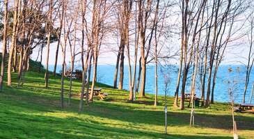 Karadeniz&rsquo;in g&uuml;zelliklerle dolu şehirlerinden Ordu; fındığıyla, Boztepe ile, yemyeşil doğası ile ve tabii ki pop&uuml;ler il&ccedil;elerinden &Uuml;nye ile &uuml;nl&uuml;. Eğer Karadeniz senin gezmeyi en sevdiğin coğrafyalardan biriyse ve &Uuml;nye bu b&ouml;lgede hen&uuml;z keşfetmediğin yerler arasındaysa il&ccedil;eye seyahat etmeni &ouml;neririm. Yeşilin bin bir tonunu g&ouml;rmen ve farklı bir seyahat deneyimi yaşaman i&ccedil;in &Uuml;nye&rsquo;ye gitmeni &ouml;nermemin başlıca nedenlerini senin i&ccedil;in sıraladım. İşte o sebepler. Plajları Karadeniz kıyı şeridinde yer alan il&ccedil;elerin her biri g&uuml;zelliğiyle ziyaret&ccedil;ilerinden tam puan alıyor. &Uuml;nye de bu kıyı şeridi &uuml;zerindeki il&ccedil;elerden biri ve deniz kıyısında olmanın beraberinde getirdiği t&uuml;m artıları b&uuml;nyesinde barındırıyor. Plajlarıyla, Karadeniz B&ouml;lgesi&rsquo;ndeki bir il&ccedil;eden &ccedil;ok Akdeniz B&ouml;lgesi&rsquo;nde yer alan bir il&ccedil;eyi andıran &Uuml;nye, denize girmek i&ccedil;in &uuml;lkemizdeki en g&uuml;zel yerlerden biri. Yeşillikler arasında yer alan ve toplamda 8 tane olan &Uuml;nye plajlarından en &uuml;nl&uuml;leri Uzunkum ve &Ccedil;ınarsuyu plajları. Yalnızca bu iki plaj bile rotanı &Uuml;nye&rsquo;ye &ccedil;evirmen i&ccedil;in yeterli sebepler. Şehir merkezine yaklaşık 50 kilometre mesafede yer alan il&ccedil;edeki diğer plajların isimleriyse Atik Otel Plajı, G&ouml;l Evi İnciraltı Plajı, G&ouml;l Evi Kumsal Plajı, Kırkevler Plajı, Kızılcakese Kumsalı ve Mavi Deniz Kumsal Plajı. İl&ccedil;eye gittiğinde hangi plaja yakınsan onda denize girmeyi tercih edebilirsin &ccedil;&uuml;nk&uuml; bu plajların her birinde su tertemiz ve y&uuml;zmek olduk&ccedil;a keyifli. &Uuml;nye plajlarıyla ilgili son olarak Kırkevler Plajı ve Kızılcakese Kumsalı&rsquo;nın halk plajı kategorisinde olduğunu, diğer plajlarınsa &ouml;zel işletmelere ait olduğunu eklemek isterim. Peki &Uuml;nye&rsquo;nin denizi nasıl diyecek olursan onu da senin i&ccedil;in cevaplayayım. Karadeniz b&ouml;lgesinde olduğu i&ccedil;in il&ccedil;ede deniz Akdeniz ve Ege b&ouml;lgelerinin denizlerine g&ouml;re biraz daha soğuk. Yine diğer b&ouml;lgelere kıyasla burada deniz biraz daha dalgalı da. Ama dikkatle y&uuml;z&uuml;ld&uuml;ğ&uuml;nde &Uuml;nye&rsquo;nin denizi kesinlikle &ccedil;ok keyifli. &Ccedil;&uuml;nk&uuml; su hem berrak hem de plajlar kum. {flight_search_form_banner} Pop&uuml;ler doğal g&uuml;zellikleri ve tarihi mekanları Ordu&rsquo;nun g&uuml;zel il&ccedil;esi &Uuml;nye, tabii ki de yalnızca masmavi sulardan ve ince kumlu plajlardan ibaret değil. Yaz mevsimi dışında il&ccedil;eyi keşfe giden seyahat severler i&ccedil;in de burada yapılacak aktiviteler ve mutlaka g&ouml;r&uuml;lmesi gereken yerler var. &Ccedil;ınarsuyu Tabiat Parkı &Ccedil;ınarsuyu Tabiat Parkı, Samsun-Ordu Karayolu &uuml;zerinde konumlanmış ve denize kıyısı bulunan yani ziyaret&ccedil;ilerine maviyle yeşilin uyumunu sunan olduk&ccedil;a keyifli bir tabiat parkı. G&uuml;n&uuml;birlik geziler i&ccedil;in şehrin farklı il&ccedil;elerinden sıklıkla ziyaret edilen park aynı zamanda bungalov evlerde konaklamak ya da kamp yapmak isteyen kişilerin de &Uuml;nye&rsquo;de rotasını &ccedil;evirdiği ilk duraklardan biri. Piknik alanlarıyla dolu &Ccedil;ınarsuyu Tabiat Parkı&rsquo;nda denize karşı bir piknik organize edebilirsin ya da eşsiz Karadeniz doğasının kalbinde konaklamak i&ccedil;in kamp yapabilirsin. Giriş &uuml;creti: 6 TL İndirimli: 3 TL Asarkaya Kent Ormanı &Uuml;nye-Fatsa yolu &uuml;zerinde yer alan ve &Uuml;nye&rsquo;den 4 kilometre uzaklıkta konumlanmış Asarkaya Kent Ormanı, il&ccedil;enin en g&uuml;zel mesire yerlerinden. Manzarayı izleyerek y&uuml;r&uuml;y&uuml;ş yapabileceğin bu orman, b&uuml;nyesindeki bitki bolluğu sayesinde g&ouml;renleri hayran bırakıyor. Kuş g&ouml;zlemciliğiyle ilgiliysen de gidebileceğin Asarkaya Kent Ormanı, tıpkı &Ccedil;ınarsuyu Tabiat Parkı gibi piknik yapmak i&ccedil;in ideal bir mekan. Semaverde &ccedil;ayının lezzetiyle &uuml;nl&uuml; bu ormanda daha &ouml;nce g&ouml;rmediğin ağa&ccedil;lara rastlayacaksın. Otomobille giriş &uuml;creti: 3 TL &Ccedil;amlık İl&ccedil;enin en pop&uuml;ler noktalarından biri de yemyeşil minik bir ormanın Karadeniz&rsquo;in masmavi sularıyla buluştuğu b&ouml;lge &Ccedil;amlık. Y&uuml;r&uuml;y&uuml;ş i&ccedil;in ideal bir yer olan &Ccedil;amlık, sana kendini bir tablodaymışsın gibi hissettirecek renklilikte. Hatta &Uuml;nye&rsquo;nin denize girilen meşhur kayaları Fok Fok da bu civarda konumlanmış. Biliyorum piknik yapmaktan &ccedil;ok bahsettim ama &Ccedil;amlık&rsquo;ın da piknik i&ccedil;in ideal bir yer olduğunu s&ouml;ylemem gerek. (g&uuml;l&uuml;c&uuml;k) Burada &ccedil;am ağa&ccedil;larının kokusunu i&ccedil;ine &ccedil;eke &ccedil;eke ve manzarayı izleyerek piknik yapabilirsin. &Uuml;nye&rsquo;de gezilecek yerler bu kadarla sınırlı değil. İl&ccedil;eye gitmişken Kadılar Yokuşu&rsquo;nu, &Uuml;nye Kalesi&rsquo;ni, iskeleyi, Bakırcılar &Ccedil;arşısı&rsquo;nı, &Ccedil;akırtepe&rsquo;yi g&ouml;rmeden d&ouml;nmemelisin. Nostaljik atmosferi &Uuml;nye&rsquo;de mimariyi eski ve yeni diye ikiye ayırmak m&uuml;mk&uuml;n. Yeni mimariye ait yapılar &uuml;lkemizin d&ouml;rt bir yanında g&ouml;r&uuml;len apartmanlar ve sitelerle benzerlik g&ouml;sterse de eski mimariye ait yapılar il&ccedil;eyi farklı kılıyor. &Ccedil;&uuml;nk&uuml; eski mimariye ait yapılarda Osmanlı ve Rum k&uuml;lt&uuml;rlerinden izler g&ouml;zlemlemek m&uuml;mk&uuml;n. Bu durum da &Uuml;nye&rsquo;nin nostaljik bir atmosfere sahip olmasını beraberinde getiriyor. Eğer tarihi seyahatlerden hoşlanıyorsan ya da yalnızca bir il&ccedil;enin sınırlarında y&uuml;r&uuml;rken farklı medeniyetlerden izlerle karşılaşmak istiyorsan &Uuml;nye gitmeni &ouml;nerdiğim yerlerden biri. Rumların ve Ermenilerin izlerini g&ouml;rebileceğin yapıları keşfetmek istersen il&ccedil;edeki Yalı diye isimlendirilen ve &Ccedil;akırtepe&rsquo;ye kadar uzanan alanı gezebilirsin. İl&ccedil;ede, Osmanlılardan kalan izleri keşfetmek istersen rotanı &ccedil;evirmen gereken adres ise tabii ki de Kadılar Yokuşu. &Uuml;nye&rsquo;de &ccedil;ok sayıda kadının yaşamasından dolayı bu ismi alan yokuş kıyıya dik olarak iniyor ve Cumhuriyet Meydanı&rsquo;na bağlanıyor. Yokuşun iki tarafı da tarihi &Uuml;nye evlerinin en g&ouml;sterişli &ouml;rnekleriyle dolu. Adeta bir a&ccedil;ık hava m&uuml;zesi olarak tanımlanabilecek Kadılar Yokuşu sayesinde &Uuml;nye&rsquo;deyken Osmanlı k&uuml;lt&uuml;r&uuml;ne dair fikir sahibi olabilirsin. İl&ccedil;edeki mekanlar da bu nostaljik havayı pekiştirir konseptte. Osmanlı konseptli kahvecilerde kahveni yudumlayabilir ya da saray mutfağından yemekler sunan restoranlarda farklı lezzetler tadabilirsin. Yemyeşil doğası Karadeniz sınırları i&ccedil;erisindeki bir yerin yeşilliklerden yoksun olduğunu d&uuml;ş&uuml;nmek pek de doğru olmaz. &Ccedil;&uuml;nk&uuml; bitki &ouml;rt&uuml;s&uuml; orman olan b&ouml;lgenin her bir k&ouml;şesi yeşilin farklı tonlarıyla b&uuml;r&uuml;l&uuml;. Ordu&rsquo;nun g&uuml;zel il&ccedil;esi &Uuml;nye de yemyeşil bir yer. Hatta D&uuml;nya Sağlık &Ouml;rg&uuml;t&uuml;&rsquo;ne g&ouml;re kişi başına d&uuml;şen yeşillik miktarı en az 9 metrekare olmalıyken 2018 verilerinde &Uuml;nye&rsquo;de bu miktarın 26,22 metrekare olduğu hesaplanmış. Yani b&ouml;lge b&uuml;y&uuml;k ormanlarla dolu. Bu sayede de il&ccedil;e sınırları i&ccedil;erisindeki hava kalabalık şehir merkezlerine g&ouml;re daha temiz. &nbsp; Kendini doğaya bıraktığın, temiz havaya doyduğun ve uzun orman y&uuml;r&uuml;y&uuml;şleri yapabildiğin bir seyahate &ccedil;ıkmak istiyorsan il&ccedil;eye gitmeni &ouml;neririm. Buradaki ormanlarda sevdiklerinle piknik yapabilir, &ouml;mr&uuml; hayatında ilk kez karşılaşacağın ağa&ccedil;lar g&ouml;rebilirsin. Yeşil alan ortalaması d&uuml;nya ortalamasını ge&ccedil;en bu il&ccedil;edeki farklı yeşil tonları kendini daha huzurlu hissetmeni sağlayacak. Farklı konseptlerdeki otelleri &Uuml;nye otelleri, genellikle sahil kenarında hizmet verenler ve bir konaktan d&ouml;n&uuml;şt&uuml;r&uuml;lerek otel yapılmış tesisler olarak ikiye ayrılıyor. &Uuml;nye&rsquo;nin meşhur plajlarından birinden mavi sulara dalmak isteyen seyahat severler i&ccedil;in sahil otelleri ideal se&ccedil;enekken daha nostaljik bir atmosferde konaklamak isteyenler i&ccedil;inse konaktan d&ouml;n&uuml;şt&uuml;r&uuml;lm&uuml;ş oteller daha uygun. Genellikle oda kahvaltı konseptinde hizmet veren konaklama birimleri ya deniz manzarasına ya da doğa manzarasına sahip. Ordu şehir merkezinden yaklaşık 50 kilometre uzaktaki &Uuml;nye otelleri arasından sana en uygun olanı il&ccedil;eye gittiğin mevsime g&ouml;re se&ccedil;meni &ouml;neririm. &Ccedil;&uuml;nk&uuml; yaz mevsiminde sahil otelleri &ccedil;ok keyifliyken diğer mevsimlerde ise konaktan d&ouml;n&uuml;şt&uuml;r&uuml;lm&uuml;ş oteller &ccedil;ok g&uuml;zel oluyor. Eşsiz yemekleri Ordu ve il&ccedil;eleri s&ouml;z konusu olduğunda akla gelen ilk &uuml;r&uuml;n fındık oluyorsa da aslında bu şehrin mutfağı fındık dışında da bir hayli geniş. &Uuml;nye de Ordu&rsquo;nun mutfağındaki g&uuml;zel yemeklerin her birini bulabileceğin, lezzetler a&ccedil;ısından zengin bir yer. &Uuml;nye pidesi ve &Uuml;nye lokumu il&ccedil;eyle &ouml;zdeşleşmiş tatlar. Eğer sen de bu destinasyona seyahat edeceksen tatman gereken ilk iki lezzet lokum ve pide olmalı. Bu arada &Uuml;nye lokumu kurabiyeye benzeyen bir yiyecek. Normal lokuma benzediğini d&uuml;ş&uuml;nme diye uyarmak istedim. Galdirik otu kavurması, turşu kavurması, ısırgan &ccedil;orbası, pancar sarması ve fasulye turşusu da &Uuml;nye mutfağı denince akla gelen diğer lezzetler. Yalnızca bu yemekleri yediğinde bile i&ccedil;inden &ldquo;İyi ki &Uuml;nye&rsquo;ye gelmişim&rdquo; diyeceğine eminim. Hatta bana sorarsan eve d&ouml;nd&uuml;kten sonra bile &Uuml;nye anılarını yaşatmak i&ccedil;in y&ouml;resel turşulardan ve meşhur bal &ccedil;eşitlerinden satın alabilirsin. Boztepe&rsquo;ye yakınlığı &ldquo;Ordu&rsquo;da mutlaka g&ouml;r&uuml;lmesi gereken yer neresidir&rdquo; diye sorsan şehri g&ouml;ren herkes tek ağızdan &ldquo;Boztepe&rdquo; der. Ordu şehir merkezine tepeden bakacağın bir konuma sahip olan ve genellikle teleferikle &ccedil;ıkılan Boztepe, şehrin en g&ouml;r&uuml;lesi yeri. Mavi ve yeşilin kucaklaştığı şehirden manzaraları en net şekilde seyredebileceğin, dilersen eşsiz bir manzaraya karşı lezzetli yemekler tadabileceğin hatta yama&ccedil; paraş&uuml;t&uuml; yapabileceğin Boztepe, &Uuml;nye&rsquo;ye yalnızca 50 dakikalık bir mesafede. Yani &Uuml;nye&rsquo;ye giderek yalnızca il&ccedil;edeki eşsiz deneyimleri yaşamış olmayacaksın. Şehirdeki en farklı ve en &ouml;zel deneyimi yaşamaya da yakın olacaksın. Bir iyi haberim daha var. &Uuml;nye&rsquo;den Boztepe&rsquo;ye giden yollar &ccedil;ok g&uuml;zel ve &ccedil;ok keyifli. Yemyeşil. Bu arada &Uuml;nye yalnızca Boztepe&rsquo;ye yakın değil. Şehrin diğer pop&uuml;ler il&ccedil;esi Fatsa, &Uuml;nye&rsquo;den yalnızca 25 dakikalık bir uzaklıkta. Şehir dışından gelen ziyaret&ccedil;ilerin b&uuml;nyesindeki iki b&uuml;y&uuml;k g&ouml;l&uuml; g&ouml;rmek i&ccedil;in gittiği G&ouml;lk&ouml;y, il&ccedil;eye 45 dakikalık uzaklıktayken pop&uuml;ler bir diğer il&ccedil;e Perşembe ise buraya 1 saat uzaklıkta. Eğer yalnızca &Uuml;nye&rsquo;yi gezeceğin bir seyahattense Ordu&rsquo;yu başlı başına deneyimleyeceğin kapsamlı bir gezi planı hazırlıyorsan her yere yakın konumu sayesinde &Uuml;nye konaklamayı tercih edeceğin b&ouml;lge olabilir. Kapsamlı Ordu gezinde g&ouml;rmen gereken yerleri Ordu'da gezilecek yerler i&ccedil;eriğimizle keşfedebilirsin.&nbsp; Son olarak il&ccedil;enin Samsun&rsquo;a yalnızca 83 kilometre uzaklıkta olduğunu da eklememde fayda var. G&uuml;n doğumu/ g&uuml;n batımı Haluk Levent&rsquo;in uğruna şarkı yazdığı &Uuml;nye&rsquo;nin olduk&ccedil;a &ouml;zel bir farklılığı var. Ş&ouml;yle ki il&ccedil;ede g&uuml;neş denizden doğuyor ve denizden batıyor. D&uuml;nyada yalnızca birka&ccedil; yerde g&uuml;neşin denizden doğup yeniden denizden batıyor oluşu il&ccedil;edeki g&uuml;n batımlarını ve g&uuml;n doğumlarını eşsiz kılıyor. Her sabah ya da her akşam deniz kenarında g&uuml;neşin hareketlerini izlemek i&ccedil;in sabırsızca bekleyecek olman da başlı başına &Uuml;nye&rsquo;ye gitmen i&ccedil;in bir sebep aslında. &Ccedil;&uuml;nk&uuml; ger&ccedil;ekten de buradaki g&uuml;n doğumu ve g&uuml;n batımı &ccedil;ok &ouml;zel. Havaalanına yakın olması Bazı yerler havaalanına &ccedil;ok uzak olduğu i&ccedil;in u&ccedil;akla gittikten sonra il&ccedil;eye erişim uzun zaman alabiliyor. S&ouml;z konusu &Uuml;nye olduğunda durum bunun tam tersi. &Ccedil;&uuml;nk&uuml; il&ccedil;e havaalanına uzak bir konumda değil. &Uuml;nye ile Ordu Giresun Havalimanı arasında yaklaşık 80 kilometre var. Havalimanı il&ccedil;eden sadece 1 saat uzaklıkta. Yani il&ccedil;eyi keşfetmek i&ccedil;in bir Ordu u&ccedil;ak bileti alman ve sonrasında 1 saatlik bir yolculuğun ardından &Uuml;nye&rsquo;ye varman yeterli. Bu yolculuk i&ccedil;in Havaş&rsquo;a binebilirsin. &Uuml;nye&rsquo;ye ulaşım i&ccedil;in bir diğer se&ccedil;enek de otob&uuml;s. &Uuml;nye otob&uuml;s bileti fiyatlarını karşılaştırarak il&ccedil;eye kolayca ulaşabilmen m&uuml;mk&uuml;n. B&uuml;y&uuml;k bir il&ccedil;e olduğu i&ccedil;in &Uuml;nye&rsquo;de otob&uuml;s garı da var. Yani otob&uuml;s se&ccedil;eneğini değerlendirirsen direkt il&ccedil;e merkezine varabilirsin.