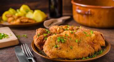 Yabancı bir &uuml;lkede, elinde haritayla gezerken, g&uuml;zel bir akşam yemeği i&ccedil;in mek&acirc;n ararsın. O an hissettiğin belirsizliği ve tatlı telaşı biliyoruz. Ama merak etme, en lezzetli masada senin i&ccedil;in &ccedil;oktan yer ayırttık bile. Avrupa&rsquo;nın kalbindeki Avusturya, sadece klasik m&uuml;ziğin ve barok mimarinin değil, aynı zamanda imparatorluk ihtişamını yaşatan mutfak k&uuml;lt&uuml;r&uuml;n&uuml;n de merkezi. Avusturya mutfağı, Alp Dağları&rsquo;nın tertemiz havasından beslenen k&ouml;y gelenekleri ile Viyana&rsquo;nın saray soyluluğunu bir araya getiriyor. Avusturya yemekleri, Orta Avrupa&rsquo;nın &ccedil;ok k&uuml;lt&uuml;rl&uuml; gastronomi mirasını yansıtıyor.&nbsp; Bir yanda tereyağında hazırlanan altın sarısı şinitzeller, diğer yanda ise asırlık kahve evlerinin nostaljik atmosferinde yudumlanan dumanı &uuml;st&uuml;nde kahveler. Avusturya mutfağı, sana bir zamanlar imparatorların ve sanat&ccedil;ıların oturduğu sofralarda tarihin ve lezzetin uyumunu sunan gurme bir yolculuk yaşatacak zenginlikte. 1. Viyana şinitzeli (Wiener schnitzel) Avusturya&rsquo;nın t&uuml;m d&uuml;nyada tanınan en zarif ve ikonik simgesi, altın sarısı rengiyle iştah kabartan Viyana şinitzeli. En kaliteli dana etlerinin incecik d&ouml;v&uuml;l&uuml;p un, yumurta ve &ouml;zel galeta ununa batırılması ile hazırlanan bu lezzet, tereyağında y&uuml;zd&uuml;r&uuml;lerek pişirildiği i&ccedil;in o meşhur dalgalı ve &ccedil;ıtır dış y&uuml;zeyine kavuşuyor. Viyana şinitzeli, şehrin tarih&icirc; restoranlarında tabağı kaplayacak kadar b&uuml;y&uuml;k porsiyonlarla sunuluyor. Bu şinitzelin ger&ccedil;ek sırrı ise etin yumuşaklığını korurken dış katmanının hafif bir yapıda kalması. Viyana şinitzeli, genellikle yanında yaban mersini sosu, bir dilim limon ve hardallı-sirke soslu nefis bir Avusturya patates salatası ile servis ediliyor.&nbsp; 2. Tafelspitz Avusturya&rsquo;nın asaletini ve geleneksel pişirme sanatını en iyi yansıtan yemeklerin başında, İmparator Franz Joseph&rsquo;in en sevdiği yemek olarak tarihe ge&ccedil;en tafelspitz geliyor. Bu lezzet, dana etinin en &ouml;zel kısmının k&ouml;k sebzeler, baharatlar ve soğanla birlikte saatlerce suyun i&ccedil;inde ağır ağır haşlanması ile hazırlanıyor. Etin lokum gibi yumuşak bir doku kazandığı bu pişirme tekniği, hem berrak ve besleyici bir et suyunu hem de ana yemeği aynı anda sunuyor. Tafelspitz, genellikle yanında rendelenmiş elma ve yaban turpu karışımı olan "apfelkren", frenk soğanlı ekmek sosu ve &ccedil;ıtır kızarmış patateslerle (r&ouml;sti) servis ediliyor. Tafelspitz, sadece bir yemek değil, Avusturya&rsquo;nın incelikli ve vakur sofra k&uuml;lt&uuml;r&uuml;n&uuml; temsil eden bir rit&uuml;eli. 3. Wiener saftgulasch (Viyana usul&uuml; gulaş) Avusturya&rsquo;nın Macar komşularından miras alıp kendine has bir dokuyla harmanladığı wiener saftgulasch, &ouml;zellikle soğuk kış g&uuml;nlerinin vazge&ccedil;ilmezi. Klasik gulaşlardan farklı olan Viyana usul&uuml;nde sebze olarak sadece bol miktarda soğan kullanılıyor. Etle neredeyse eşit miktarda olan bu soğanlar, saatlerce s&uuml;ren pişme s&uuml;reci sonunda tamamen eriyerek yemeğe o meşhur koyu ve yoğun sos kıvamını veriyor. Kaliteli dana etinin y&uuml;ksek kaliteli kırmızı toz biber (paprika) ile ağır ateşte demlenerek pişirildiği bu yemek, sabrın lezzete d&ouml;n&uuml;şt&uuml;ğ&uuml; bir şaheser. Viyana usul&uuml; gulaş, genellikle yanında "semmelkn&ouml;del" denilen ekmek k&ouml;fteleri veya haşlanmış patatesle servis ediliyor. Bu yoğun aromalı yahni, şehrin yerel restoranlarında tadabileceğin en karakteristik yemeklerin başında geliyor. 4. Tiroler gr&ouml;stl Avusturya Alplerinin dondurucu soğuğuna karşı geliştirilen tiroler gr&ouml;stl, en lezzetli ve doyurucu y&ouml;resel yemeklerden biri. Bu lezzet, dağ k&uuml;lt&uuml;r&uuml;n&uuml;n samimiyetini şık sofralara taşıyan geleneksel bir tava. Tiroler gr&ouml;stl, haşlanmış patateslerin ince kıyılmış soğan ve lezzetli et par&ccedil;alarıyla (genellikle dana eti veya pastırma) birlikte, tereyağında dışı &ccedil;ıtırlaşana kadar kavrulması ile hazırlanıyor. Bu iştah kabartan karışımın &uuml;zerine eklenen ve sarısı akışkan bırakılan sahanda yumurta ise yemeğe hem g&ouml;rsellik hem de lezzet katıyor. Tiroler gr&ouml;stl, genellikle taze taze tavada ve &uuml;zerine serpilen taze kekik veya frenk soğanı ile servis ediliyor. Bu lezzet, bir kış g&uuml;n&uuml;nde kayak pistlerinden d&ouml;nenlerin tercih ettiği en besleyici yemeklerden biri. {insightBoxStart}İpucu: Bu lezzet dolu turun ardından başını huzurla yastığa koyacağın o odayı birlikte se&ccedil;elim mi? En iyi otel fiyatlarını tek bir yerde g&ouml;rmek, se&ccedil;eceğin otel hakkında bilgi almak ve saniyeler i&ccedil;inde rezervasyon yapmak i&ccedil;in ENUYGUN'da Avusturya otelleri araştırmasına başlayabilirsin.{insightBoxEnd} {hotel_search_form_banner} 5. Karntner kasnudeln Karintiya b&ouml;lgesinin en sevilen y&ouml;resel lezzeti olan karntner kasnudeln, hamur işi sanatı ile taze &ccedil;iftlik &uuml;r&uuml;nlerinin g&uuml;zel bir buluşması. Geleneksel olarak elle hazırlanan ve kenarlarına "krendeln" denilen &ouml;zel bir &ouml;rg&uuml; bi&ccedil;imi verilen bu iri mantıların i&ccedil;inde ise yumuşak lor peyniri ve haşlanmış patates bulunuyor. Bu yemeğe karakteristik ferahlığını veren ise taze nane veya yabani otlar. Karntner kasnudeln, suda haşlandıktan sonra &uuml;zerine bol miktarda kızgın ve kahverengileşmiş tereyağı gezdirilerek servis ediliyor. Karintiya g&ouml;llerinin ve Alp k&ouml;ylerinin huzurunu sofraya taşıyan bu &ouml;zel yemek, Avusturya mutfağının b&ouml;lgesel &ccedil;eşitliliğini ve doğallığını temsil ediyor.&nbsp; 6. Schweinebraten Avusturya&rsquo;da pazar sofralarını s&uuml;sleyen en k&ouml;kl&uuml; yemeklerinden olan schweinebraten, fırında ağır ağır pişen bir et ziyafeti. Sarımsak, kimyon ve kişniş gibi baharatlar ile marine edilen etin, dış y&uuml;zeyi &ccedil;ıtır &ccedil;ıtır, i&ccedil;i ise lokum gibi yumuşak olana kadar pişiriliyor. Pişme sırasında ortaya &ccedil;ıkan doğal et suyunun koyu ve yoğun bir sosa d&ouml;n&uuml;şt&uuml;r&uuml;lerek &uuml;zerinde gezdirildiği bu lezzet, aromatik ve isli tadı ile &uuml;nl&uuml;. Geleneksel olarak yanında ekmek k&ouml;ftesi ve ferahlatıcı bir lahana turşusu (sauerkraut) veya taze lahana salatasıyla servis edilen schweinebraten, Avusturya&rsquo;nın kırsal mutfak k&uuml;lt&uuml;r&uuml;n&uuml; en doyurucu hali. 7. Backhendl Backhendl, 18. y&uuml;zyılın aristokrat sofralarından g&uuml;n&uuml;m&uuml;z&uuml;n samimi aile lokantalarına kadar uzanan bir ge&ccedil;mişe sahip. Bu &ouml;zel lezzet, Viyana usul&uuml; kızarmış tavuğun en &ccedil;ıtır ve en prestijli hali. Backhendl hazırlanırken b&uuml;t&uuml;n bir tavuk par&ccedil;alara ayrılıp limon, tuz ve karabiber ile marine edildikten sonra un, &ccedil;ırpılmış yumurta ve galeta ununa batırılarak yağda altın sarısı bir renk alana kadar kızartılıyor. Şinitzel ile benzer bir paneleme tekniğine sahip olsa da tavuğun kemikli ve sulu yapısının korunması, bu yemeğe kendine has bir karakter katıyor. Geleneksel olarak backhendl, yanında taze limon dilimleri, maydanozlu patatesler veya sirke bazlı bir patates salatası ile birlikte sunuluyor. Bu y&ouml;resel yemek, hem l&uuml;ks restoranlarda hem de bağ evi meyhanelerinde (Heuriger) men&uuml;leri s&uuml;sl&uuml;yor. 8. Sachertorte (Sacher pastası) D&uuml;nyanın en &uuml;nl&uuml; &ccedil;ikolatalı pastası olarak kabul edilen sachertorte, Viyana mutfağının asaletini temsil ediyor. Yoğun ve nemli bir &ccedil;ikolatalı kekin ortasındaki ince kayısı re&ccedil;eli katmanı, bu pastaya karakteristik meyvemsi tadını kazandırıyor. &Uuml;zeri p&uuml;r&uuml;zs&uuml;z bir bitter &ccedil;ikolata glajıyla kaplanan bu tatlı, geleneksel olarak yanında şekersiz &ccedil;ırpılmış krema (schlagobers) ile servis ediliyor. Hotel Sacher ile Demel Pastanesi arasındaki "orijinal tarif" rekabetiyle de bilinen bu &ouml;zel pasta, nostalji tutkunlarına hitap ediyor. 9. Elmalı strudel (Apfelstrudel) İmparatorluk d&ouml;neminden bu yana Avusturya sofralarının vazge&ccedil;ilmez tatlısı olan apfelstrudel, hamur işi sanatının en zarif &ouml;rneklerinden biri. Apfelstrudel, geleneksel olarak kağıt inceliğinde el a&ccedil;ması yufkanın i&ccedil;ine tar&ccedil;ınlı ekşi elmalar, şekerle kavrulmuş ekmek kırıntıları, kuru &uuml;z&uuml;m ve bazen de kıyılmış badem eklenerek hazırlanıyor. Fırından &ccedil;ıktığında &ccedil;ıtır &ccedil;ıtır olan bu rulo tatlı, genellikle ılık olarak ve &uuml;zerine pudra şekeri serpilerek sunuluyor. Yanına eklenen sıcak vanilya sosu veya bir top dondurma ise bu klasik lezzeti bir ziyafete d&ouml;n&uuml;şt&uuml;r&uuml;yor. 10. Kaiserschmarrn (İmparator sarması) Adını İmparator Franz Joseph&rsquo;ten alan bu geleneksel tatlı, aslında bir t&uuml;r par&ccedil;alanmış omlet veya krep. Bu lezzet, Avusturya&rsquo;nın diğer zarif pastalarının aksine daha rustik ve doyurucu bir karaktere sahip. Yumurta, un ve s&uuml;t&uuml;n karıştırılması ile hazırlanan yoğun ve kabarık hamur, tavada karamelize olana kadar tereyağında pişiriliyor. Ardından ise k&uuml;&ccedil;&uuml;k par&ccedil;alara b&ouml;l&uuml;n&uuml;yor. &Uuml;zerine karamelize şeker ve pudra şekeri eklenerek sunulan tatlının olmazsa olmaz eşlik&ccedil;isi ise "zwetschkenr&ouml;ster" denilen &ouml;zel erik kompostosu. Kaiserschmarrn, hem bir tatlı hem de Alp dağlarında tercih edilen doyurucu bir &ouml;ğle yemeği alternatifi. Peki ya bu yemeğin, imparatorun en sevdiği yemek olduğunu ve bir mutfak kazası sonucu ortaya &ccedil;ıktığını biliyor muydun?&nbsp; {{campaignsSlider}} 11. Wiener melange Viyana kahve evi k&uuml;lt&uuml;r&uuml;n&uuml;n en zarif sembol&uuml; olan wiener melange, kahve ve s&uuml;t&uuml;n kusursuz bir dengede buluştuğu, şehrin ruhunu yansıtan bir i&ccedil;ecek. Tarz olarak İtalyan kahvelerini andırsa da melange, &ccedil;ok daha yumuşak bir i&ccedil;ime sahip. Melange, genellikle kaliteli bir espresso &ccedil;ekirdeğinden hazırlanan tek &ouml;l&ccedil;&uuml; kahve ile bolca k&ouml;p&uuml;rt&uuml;lm&uuml;ş sıcak s&uuml;t&uuml;n yarı yarıya karıştırılması ile yapılıyor. Kahvenin &uuml;zerindeki s&uuml;t k&ouml;p&uuml;ğ&uuml;, kahvenin yoğun aromasını yumuşatırken damağa kadifemsi bir dokunuş bırakıyor. Melange, otantik kafelerde k&uuml;&ccedil;&uuml;k bir g&uuml;m&uuml;ş tepsi &uuml;zerinde ve yanında mutlaka bir bardak su ile servis ediliyor. Bu lezzetli kahve, aceleyle i&ccedil;ilecek bir i&ccedil;ecek değil, bir gazete veya derin bir sohbet eşliğinde tadına varılması gereken asırlık bir rit&uuml;el. G&uuml;m&uuml;ş tepsi ile sunulan o kahvenin kadifemsi k&ouml;p&uuml;ğ&uuml;, bir bardak suyun serinliği ile buluştuğu anı unutamayacaksın. 12. Almdudler Avusturya&rsquo;nın mill&icirc; i&ccedil;eceği olarak kabul edilen almdudler, Alplerin tertemiz doğasını ve ferahlığını bir şişeye sığdıran, benzeri olmayan bitkisel bir gazoz. 1957 yılından beri gizli tutulan &ouml;zel bir re&ccedil;ete ile &uuml;retilen bu i&ccedil;ecekte m&uuml;rver &ccedil;i&ccedil;eği, melisa, ada&ccedil;ayı ve centiyane gibi Alplerden toplanan 32 farklı yabani ot karıştırılıyor. Ne &ccedil;ok şekerli ne de sıradan bir meyve suyu kadar yoğun olan almdudler, damakta bıraktığı mayhoş ve bitkisel aroması ile her yaştan Avusturyalının favorisi. Bu i&ccedil;ecek, Avusturya sofralarında sadece sade olarak değil, maden suyuyla karıştırılarak veya yerel şaraplarla harmanlanarak da sık&ccedil;a t&uuml;ketiliyor. Almdudler, Alplerin o meşhur dağ havasını her yudumda hissettiren, &uuml;lkenin en sevilen ferahlık kaynağı. 13. Schnapps (Meyve brendisi) Schnapps, Avusturya&rsquo;nın &ouml;zellikle dağlık b&ouml;lgelerinde ve kırsal kesiminde bir yaşam bi&ccedil;imi haline gelmiş bir i&ccedil;ecek. Schnapps, meyvenin en saf ve g&uuml;&ccedil;l&uuml; halini şişeleyen geleneksel bir damıtma sanatı. Genellikle yemeklerden sonra sindirimi kolaylaştırmak amacıyla k&uuml;&ccedil;&uuml;k kadehlerde sunulan bu sert i&ccedil;ecek i&ccedil;in kayısı, armut, elma veya erik gibi yerel meyveler fermente edilip &ouml;zenle damıtılıyor. %40 ve &uuml;zeri alkol oranına sahip olmasına rağmen kaliteli bir schnapps, boğazda yakıcı bir histen ziyade, meyvenin o taze ve karakteristik aromasını hissettiriyor. &Ouml;zellikle butik &uuml;reticilerin Alplerin yama&ccedil;larındaki bah&ccedil;elerden topladığı meyvelerle hazırladığı bu berrak i&ccedil;ki, Avusturya&rsquo;nın doğaya olan bağlılığının ve el iş&ccedil;iliği i&ccedil;ki k&uuml;lt&uuml;r&uuml;n&uuml;n en g&uuml;zel &ouml;rneği. Birbirinden g&uuml;zel bu yemekleri yerinde denemek i&ccedil;in en g&uuml;zel Avusturya şehirleri yazımızı inceleyebilirsin.