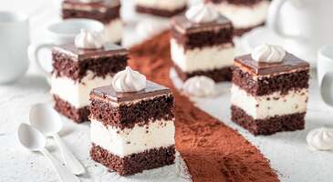 Arnavut kaldırımlı Varşova sokaklarında y&uuml;r&uuml;rken, her k&ouml;şeden y&uuml;kselen enfes kokular arasında se&ccedil;im yapmakta zorlandığını biliyoruz. Ama merak etme, biz senin i&ccedil;in &ccedil;oktan bir liste hazırladık. Polonya&rsquo;nın kalbi Varşova, sadece k&uuml;llerinden doğması ile değil, Orta Avrupa&rsquo;nın k&ouml;kl&uuml; geleneklerini modern gastronomi ile harmanlayan dinamik mutfak k&uuml;lt&uuml;r&uuml;yle de &uuml;nl&uuml;. Varşova mutfağı, şehrin karakterini yansıtan doyurucu ve lezzetli atıştırmalıklardan t&uuml;ts&uuml;lenmiş etlerin isli aromasına, el a&ccedil;ması hamurlardan nostaljik tatlılara kadar geniş bir yelpaze sunuyor.&nbsp; Varşova&rsquo;da yemek, sadece karnını doyurmak değil, aynı zamanda Polonya halkının diren&ccedil;li ve misafirperver ruhuna tanıklık etmek anlamına da geliyor. Varşova&rsquo;nın tarih&icirc; meydanları ve sokaklarına yayılan iştah a&ccedil;ıcı kokuları takip ederek, en &ouml;zel lezzetler arasında unutulmaz bir gastronomi gezisi yapabilirsin. 1. Pierogi Polonya&rsquo;nın d&uuml;nya &ccedil;apındaki gastronomik simgesi pierogi, Varşova&rsquo;da her k&ouml;şe başında karşına &ccedil;ıkacak el emeği bir lezzet. G&ouml;r&uuml;n&uuml;ş&uuml; ile mantıyı andıran bu hamur boh&ccedil;aları, i&ccedil;lerine yerleştirilen zengin dolgu se&ccedil;enekleri ile her damak tadına hitap ediyor. Varşova sokaklarında en &ccedil;ok tercih edilen patates ve s&uuml;zme peynirli "ruskie", baharatlı kıymalı "z miesem", kış aylarının vazge&ccedil;ilmezi olan lahana turşulu ve mantarlı pierogi &ccedil;eşitleri, Polonya&rsquo;nın mutfak mirasını yansıtıyor. Pierogi, &ouml;ncelikle haşlanıyor ve ardından damak zevkine g&ouml;re tereyağında hafif&ccedil;e &ccedil;evrilerek dışına &ccedil;ıtırlık kazandırılıyor. Bu hamur işleri &uuml;zerine eklenen karamelize soğanlar, &ccedil;ıtır pastırma par&ccedil;aları veya bir kaşık taze ekşi krema (smietana) ile doyurucu bir sanat eserine d&ouml;n&uuml;ş&uuml;yor. Hamurun tereyağında &ccedil;evrilirken &ccedil;ıkardığı o cızırtıyı ve karamelize soğanların enfes kokusunu hayal et. Nostaljik bir s&uuml;t barında (Bar Mleczny) veya l&uuml;ks bir restoranda pierogi deneyerek Varşova&rsquo;nın ruhunu hissedebilirsin. 2. Zurek Varşova mutfağının en &ouml;zg&uuml;n lezzetlerinden olan zurek, damakta bıraktığı hafif ekşimsi tadı ve doyurucu yapısı ile &uuml;lkenin mutfak kimliğinde &ouml;zel bir yere sahip. Bu &ccedil;orbayı eşsiz kılan temel sır ise "zakwas" adı verilen ekşitilmiş &ccedil;avdar ununun fermente edilmesiyle elde edilen &ouml;zel maya. &Ccedil;orbanın zengin i&ccedil;eriğini ise t&uuml;ts&uuml;lenmiş etler, haşlanmış beyaz sosis ve haşlanmış yumurta oluşturuyor. Taze mercank&ouml;şk&uuml;n kattığı aromatik koku da bu yemeğe derin bir lezzet katıyor. Zurek, Varşova&rsquo;nın geleneksel restoranlarında genellikle i&ccedil;i oyulmuş, &ccedil;ıtır bir ekmek kasesinin i&ccedil;inde servis ediliyor. Peki, Varşovalıların diren&ccedil;li bir yapıya sahip olmasındaki sırrın her sabah i&ccedil;tikleri bu &ccedil;orba olabileceğini d&uuml;ş&uuml;nm&uuml;ş m&uuml;yd&uuml;n? Zurek, sadece bir başlangı&ccedil; değil, aynı zamanda g&ouml;ze ve damağa hitap eden doyurucu bir ziyafet deneyimi. 3. Bigos (Avcı yahnisi) Polonya&rsquo;nın mill&icirc; yemeği olarak kabul edilen bigos, Varşova mutfağının ge&ccedil;mişi y&uuml;zyıllar &ouml;ncesine dayanan ve yapımı en sabır isteyen lezzetlerinden biri. Bu &ouml;zel yemeğin temelini ince kıyılmış taze lahana ile ekşitilmiş lahana turşusunun farklı t&uuml;rdeki etler, t&uuml;ts&uuml;lenmiş Polonya sosisleri ve kurutulmuş yabani mantarlarla uzun s&uuml;re, bazen g&uuml;nlerce ağır ateşte pişirilmesi oluşturuyor. İ&ccedil;ine eklenen ardı&ccedil; meyvesi, karabiber ve defne yaprağı ise yemeğe karakteristik bir derinlik katıyor. Bazı tariflerde kırmızı şarap veya kuru erik de konularak, lezzete hafif bir tatlılık ve dumanlı bir aroma ekliyor. Varşova&rsquo;nın geleneksel lokantalarında genellikle koyu renkli &ccedil;avdar ekmeği eşliğinde sunulan bigos, bekledik&ccedil;e aromaları iyice birbirine ge&ccedil;en ve tadı daha g&uuml;zelleşen y&ouml;resel bir lezzet. Varşova&rsquo;nın dondurucu kış g&uuml;nlerinde i&ccedil;ini ısıtacak olan bigos, son derece doyurucu ve prestijli bir ana yemek. 4. Kotlet schabowy Varşova&rsquo;nın pop&uuml;ler ana yemeklerinden olan kotlet schabowy, pazar sofralarının değişmez lezzeti. Bu yemek, sadeliğin nasıl bir lezzet ş&ouml;lenine d&ouml;n&uuml;şebileceğinin en somut &ouml;rneği. Avusturya şinitzeline benzese de bu yemeği farklı kılan şey, pirzolanın &ouml;zenle inceltilip sadece un, yumurta ve galeta ununa bulanarak kızgın tereyağında nar gibi kızarana kadar pişirilmesi. Dışındaki altın sarısı &ccedil;ıtır katman ile i&ccedil;indeki etin yumuşak dokusu arasındaki denge, bu yemeği her yaştan Polonyalının favorisi yapıyor.&nbsp; Kotlet schabowy, Varşova&rsquo;nın geleneksel lokantalarında genellikle &uuml;zerine taze dereotu serpilmiş haşlanmış patates ve ferahlatıcı bir salatalık salatası olan "mizeria" ile servis ediliyor. Bu geleneksel yemek, Varşova&rsquo;nın ev mutfağındaki samimiyeti ve restoran k&uuml;lt&uuml;r&uuml;ndeki k&ouml;kl&uuml; alışkanlıkları yansıtan bir klasik. {insightBoxStart}İpucu: Varşova sofralarında yerin &ccedil;oktan hazır. Peki ya konforlu bir uyku i&ccedil;in se&ccedil;imin hangisi olacak? En iyi otel fiyatlarını tek bir yerde g&ouml;rmek, se&ccedil;eceğin otel hakkında bilgi almak ve saniyeler i&ccedil;inde rezervasyon yapmak i&ccedil;in ENUYGUN'da Varşova otelleri araştırmasına başlayabilirsin.{insightBoxEnd} {hotel_search_form_banner} 5. Flaki po warszawsku (Varşova usul&uuml; işkembe) Varşova&rsquo;nın en k&ouml;kl&uuml; spesiyallerinden olan flaki po warszawsku, sakatat k&uuml;lt&uuml;r&uuml;n&uuml;n Polonya başkentindeki en se&ccedil;kin yorumu. Ge&ccedil;mişi 17. y&uuml;zyıla kadar uzanan bu yemek, kraliyet sofralarından halk mutfağına kadar her yerde ilgi g&ouml;rm&uuml;ş. Varşova usul&uuml; işkembe, ince şeritler halinde kıyılmış işkembenin et suyu ve k&ouml;k sebzelerle birlikte ağır ateşte pişirilmesi ile hazırlanıyor. Onu diğer işkembe &ccedil;orbalarından ayıran en belirgin fark ise i&ccedil;eriğinde kullanılan zencefil, hindistan cevizi ve mercank&ouml;şk gibi baharatların yarattığı yoğun aromatik katman. Varşova usul&uuml; tarifin olmazsa olmaz dokunuşu ise servis esnasında &uuml;zerine eklenen rendelenmiş parmesan ve tabağa eşlik eden k&uuml;&ccedil;&uuml;k et k&ouml;fteleri (pulpety). Varşova&rsquo;nın şık restoranlarında dumanı &uuml;st&uuml;nde, yanında taze &ccedil;avdar ekmeği ile sunulan bu besleyici lezzet, ger&ccedil;ek bir yerel gurme deneyimi yaşamak isteyenler i&ccedil;in ideal. 6. Pyzy z miesem (Etli mantı) Varşova sokak lezzetlerinin ve &ouml;zellikle tarih&icirc; Praga b&ouml;lgesinin sembol&uuml; olan pyzy z miesem, patates bazlı hamuru ile doyurucu bir yerel klasik. Rendelenmiş &ccedil;iğ patates ile haşlanmış patatesin &ouml;zel bir oranla karıştırılması ile elde edilen yumuşak dokulu hamur, bu yemeğin en ayırt edici &ouml;zelliği. Bu iri ve yuvarlak topların i&ccedil;ine yerleştirilen soğanla kavrulmuş baharatlı kıymalı har&ccedil;, haşlama s&uuml;recinde kendi suyunu koruyarak her ısırıkta yoğun bir lezzet patlaması yaşatıyor. Varşova&rsquo;da genellikle cam kavanozlarda satılan pyzy, &ccedil;alışan sınıf i&ccedil;in en pratik &ouml;ğ&uuml;nlerden biri. Servis edilirken &uuml;zerine bolca d&ouml;k&uuml;len &ccedil;ıtır pastırma par&ccedil;aları (skwarki) veya karamelize soğanlarla da yemeği tam bir ziyafete d&ouml;n&uuml;şt&uuml;r&uuml;yor. Yerel pazarlarda ve geleneksel lokantalarında &ccedil;ok pop&uuml;ler olan bu lezzet, Varşova&rsquo;nın samimi mutfak k&uuml;lt&uuml;r&uuml;n&uuml; &ouml;zetliyor. 7. Golonka pieczona (Fırınlanmış domuz pa&ccedil;ası) Varşova&rsquo;nın en g&ouml;rkemli ana yemeklerinden olan golonka pieczona, et sevenler i&ccedil;in Polonya&rsquo;daki gastronomi yolculuğunun zirve noktası. Bu &ouml;zel yemek, incik kısmının &ouml;nce k&ouml;k sebzeler ve baharatlarla aromalandırılmış bir suda yavaş&ccedil;a haşlanması, ardından dışı nar gibi kızarıp &ccedil;ıtırlaşana kadar fırınlanması ile hazırlanıyor. Uzun pişirme s&uuml;resi sonunda kemikten kendiliğinden ayrılacak kadar yumuşayan et, zengin ve dumanlı aroması ile damaklarda iz bırakıyor. Varşova&rsquo;nın geleneksel restoranlarında genellikle devasa bir porsiyon olarak sunulan golonka, eti dengeleyen yaban turpu, hardal, lahana turşusu ve taze Polonya birası eşliğinde servis ediliyor. Sunumu ve doyuruculuğu ile tam bir ziyafet yemeği olan golonka pieczona, Varşova&rsquo;nın k&ouml;kl&uuml; mutfak geleneklerini en iyi yansıtan klasik lezzetlerden biri. 8. Placki ziemniaczane (Patates m&uuml;cveri) Varşova&rsquo;nın &ccedil;ok y&ouml;nl&uuml; yemeklerinden olan placki ziemniaczane, basit malzemelerin nasıl bir klasiğe d&ouml;n&uuml;şt&uuml;ğ&uuml;n&uuml;n en g&uuml;zel kanıtı. Bu &ccedil;ıtır m&uuml;cverler, rendelenmiş taze patates, soğan ve yumurtanın az miktarda unla harmanlanıp altın sarısı rengi alana kadar tavada kızartılması ile hazırlanıyor. &Ccedil;ıtır m&uuml;cverler, atıştırmalık veya doyurucu bir ana yemek olarak tercih ediliyor. Dışı gevrek, i&ccedil;i ise yumuşak ve aromatik olan bu lezzet, geleneksel olarak &uuml;zerine sadece bir kaşık soğuk ekşi krema veya bir tutam şeker serpilerek t&uuml;ketiliyor. Varşova&rsquo;nın pek &ccedil;ok restoranında &uuml;zerine yoğun ve baharatlı bir et yahnisi d&ouml;k&uuml;lerek sunulan "gulaşlı" versiyon ise yemeği tam bir ziyafete d&ouml;n&uuml;şt&uuml;r&uuml;yor. Varşova&rsquo;nın en l&uuml;ks lokantalarından nostaljik s&uuml;t barlarına kadar her yerde karşına &ccedil;ıkacak bu m&uuml;tevazı yemek, Polonya&rsquo;nın yerel tarım k&uuml;lt&uuml;r&uuml;n&uuml; hissettiriyor. 9. Wuzetka (W-Z pastası) Varşova&rsquo;nın en ikonik ve hikayesi olan tatlısı ş&uuml;phesiz wuzetka. İsmini 1940&rsquo;ların sonunda şehri doğudan batıya bağlayan W-Z Hattı&rsquo;ndan (Trasa W-Z) alan bu pasta, Varşova'nın 2. D&uuml;nya Savaşı sonrası yeniden doğuşunun bir sembol&uuml;. Bu tatlı, iki kat yoğun kakaolu ve nemli kek tabanının arasına yerleştirilen ipeksi bir &ccedil;ırpılmış krema katmanından oluşuyor. Wuzetka, sadeliği ve zarafeti g&uuml;zel bir şekilde birleştiriyor. &Uuml;zeri bitter &ccedil;ikolata ile kaplanan ve geleneksel olarak krema dokunuşu ile s&uuml;slenen wuzetka, Varşova pastane k&uuml;lt&uuml;r&uuml;n&uuml;n ayrılmaz bir par&ccedil;ası. Varşova&rsquo;nın şık kafelerinde de tadabileceğin wuzetka, nostaljik ve hafif yapısı ile Varşova&rsquo;nın modern tarihini &ouml;zetleyen bir tatlı. 10. Zygmunt&oacute;wka 2009 yılında d&uuml;zenlenen bir yarışmayla Varşova&rsquo;nın resm&icirc; "modern simge tatlısı" se&ccedil;ilen zygmunt&oacute;wka, ismini şehrin &uuml;nl&uuml; Kral Zygmunt S&uuml;tunu'ndan alıyor. Zygmunt&oacute;wka, şehrin tarih&icirc; dokusunu &ccedil;ağdaş bir pastacılık anlayışı ile birleştiren prestijli bir tatlı. Bademli gevrek bir tart hamuru tabanı &uuml;zerinde yapılan bu tatlı, zengin bir &ccedil;ikolata mus, hafif mayhoş yaban mersini re&ccedil;eli ve ipeksi bir krema katmanının uyumundan oluşuyor. En &uuml;stte yer alan ve kralların tacını andıran dalgalı beze (mereng) ise tatlıya karakteristik bir g&ouml;rsel zarafet katıyor. Varşova&rsquo;nın se&ccedil;kin pastanelerinde bulabileceğin zygmunt&oacute;wka, doku &ccedil;eşitliliği ve dengeli şeker oranı ile Varşova&rsquo;nın k&ouml;kl&uuml; ge&ccedil;mişini yenilik&ccedil;i y&uuml;z&uuml; ile buluşturuyor. {{campaignsSlider}} 11. Paczki (Polonya &ccedil;&ouml;reği) Polonya&rsquo;nın d&uuml;nyaca &uuml;nl&uuml; hamur işlerinden olan paczki, Varşova sokaklarında her k&ouml;şe başında kokusunu alabileceğin yerel bir atıştırmalık. Geleneksel donutlardan farklı olarak paczki, hamuruna eklenen az miktarda alkol ve yoğun yumurta sayesinde &ccedil;ok daha yumuşak ve yağ &ccedil;ekmeyen bir dokuya sahip. Bu &ccedil;&ouml;rekler, Varşova&rsquo;nın şık pastanelerinde aslına uygun şekilde, genellikle yabani g&uuml;l re&ccedil;eli ile dolduruluyor. &Uuml;zerine d&ouml;k&uuml;len parlak şeker glasesi ve portakal kabuğu rendesi ise tatlıyı tam bir lezzet bombasına d&ouml;n&uuml;şt&uuml;r&uuml;yor. &Ouml;zellikle &ouml;zel g&uuml;nlerde Varşovalıların &ouml;n&uuml;nde uzun kuyruklar oluşturduğu bu tatlı, şehrin g&uuml;nl&uuml;k yaşam enerjisini ve k&ouml;kl&uuml; pastacılık mirasını yansıtıyor. 12. Sernik (Polonya peynir keki) Polonya&rsquo;nın vazge&ccedil;ilmez tatlılarından olan sernik, bildiğimiz cheesecake tariflerinden &ccedil;ok daha yoğun, zengin ve rustik yapısı ile Varşova&rsquo;nın pastane vitrinlerini s&uuml;sl&uuml;yor. Bu tatlıyı benzersiz kılan temel malzeme ise Polonya&rsquo;ya &ouml;zg&uuml; "twar&oacute;g" adı verilen, y&uuml;ksek yağ oranına sahip &ouml;zel lor peyniri. Varşova&rsquo;daki geleneksel tariflerde kekin alt katmanında ince bir bisk&uuml;vi veya hamur tabanı bulunuyor. &Uuml;st katman ise bazen i&ccedil;ine eklenen kuru &uuml;z&uuml;mlerle aromalandırılmış, fırında nar gibi kızarmış yoğun bir peynir k&uuml;tlesinden oluşuyor. &Uuml;zeri bazen &ccedil;ikolata, bazen de pudra şekeri ile s&uuml;slenen sernik, ağızda dağılan doyurucu dokusu ile şık kafelerin en sevilen eşlik&ccedil;isi. Polonya&rsquo;nın yerel s&uuml;t &uuml;r&uuml;nleri geleneğini ve y&uuml;zyıllık re&ccedil;etelerin sıcaklığını hissettiren bu peynir keki, Varşova gastronomi turunun olmazsa olmaz lezzetlerinden. 13. Makowiec (Haşhaşlı rulo) Polonya mutfağının en estetik tatlılarından olan makowiec, Varşova&rsquo;da bayram sofralarından g&uuml;nl&uuml;k kahve molalarına kadar her anın vazge&ccedil;ilmez eşlik&ccedil;isi. Geleneksel bir haşhaşlı rulo olan bu tatlıyı farklı kılan şey ise incecik a&ccedil;ılmış mayalı hamurun i&ccedil;ine bal, ceviz, kuru &uuml;z&uuml;m ve bazen portakal kabuğu ile harmanlanmış yoğun bir haşhaş ezmesinin s&uuml;r&uuml;l&uuml;p rulo yapılması. Makowiec, dilimlendiğinde ortaya &ccedil;ıkan siyah-beyaz spiral g&ouml;r&uuml;nt&uuml;s&uuml; ile g&ouml;rsel bir ş&ouml;len sunuyor. Geleneksel tatlı, haşhaşın hafif fındıksı tadı ve i&ccedil; harcın tatlı aroması arasında kusursuz bir denge kuruyor. Genellikle &uuml;zerine ince bir şeker glasesi d&ouml;k&uuml;lerek ve fındık par&ccedil;aları serpilerek servis edilen makowiec, Polonya&rsquo;nın bereket simgelerinden biri.&nbsp; 14. Polonya votkası (w&oacute;dka) &Uuml;lkenin d&uuml;nyaca &uuml;nl&uuml; simgesi ve mill&icirc; i&ccedil;eceği olan Polonya votkası, Varşova&rsquo;nın sosyal yaşamının ve tarihinin ayrılmaz bir par&ccedil;ası. W&oacute;dka, sadece bir i&ccedil;ki olmanın &ouml;tesinde, y&uuml;zyıllara dayanan bir &uuml;retim ustalığı ve rit&uuml;eller b&uuml;t&uuml;n&uuml;. Bu i&ccedil;eceği, &ouml;zellikle Varşova&rsquo;nın tarih&icirc; semtlerindeki butik barlarda ve Votka M&uuml;zesi&rsquo;nde keşfedebilirsin. Polonya votkasının &ouml;zellikle &ccedil;avdar, buğday veya patatesten &uuml;retilen y&uuml;ksek kaliteli &ccedil;eşitleri, her damak tadına hitap ediyor. Polonya&rsquo;ya &ouml;zg&uuml; en karakteristik t&uuml;r olan ve i&ccedil;inde bir adet bizon otu ile servis edilen zubr&oacute;wka ise kendine has hafif aromatik tadı ile mutlaka denenmesi gereken bir klasik. Varşova&rsquo;da Polonya votkası, genellikle k&uuml;&ccedil;&uuml;k kadehlerde, buz gibi soğuk ve yanında turşu, ringa balığı veya t&uuml;ts&uuml;lenmiş etler gibi "zakąski" adı verilen mezelerle birlikte sunuluyor. 15. Kompot Kompot, Varşova&rsquo;nın geleneksel ev yemekleri k&uuml;lt&uuml;r&uuml;n&uuml;n ve nostaljik s&uuml;t barlarının (Bar Mleczny) ayrılmaz bir par&ccedil;ası. Sadeliği ve doğallığı ile &ouml;ne &ccedil;ıkan kompot, alkols&uuml;z bir meyve i&ccedil;eceği. Bu lezzetli i&ccedil;ecek, taze veya kurutulmuş elma, vişne, &ccedil;ilek veya m&uuml;rd&uuml;m eriği gibi mevsim meyvelerinin su, hafif şeker ve tar&ccedil;ın gibi baharatlar eklenerek kaynatılması ile hazırlanıyor. Hazır asitli i&ccedil;eceklerin aksine meyvenin en saf halini yansıtan kompot, Varşova&rsquo;da sıcak yaz g&uuml;nlerinde serinletici bir tercih. Kışın ise kompot, ağır et yemeklerini dengeleyen hafif bir eşlik&ccedil;i olarak t&uuml;ketiliyor. &Ccedil;ocukluk anılarını ve sofralardaki samimiyeti simgeleyen nostaljik bir klasik olan bu meyve suyu, Varşova&rsquo;nın gastronomik mirasını tamamlayan en doğal dokunuş. 16. E. Wedel sıcak &ccedil;ikolatası Varşova&rsquo;nın aristokratik ge&ccedil;mişini en iyi yansıtan lezzetlerden biri de E. Wedel sıcak &ccedil;ikolatası. Bu i&ccedil;ecek, k&ouml;kleri 1851 yılına dayanan bir şehir geleneği. Polonya&rsquo;nın en eski ve prestijli &ccedil;ikolata markası Wedel&rsquo;in lezzetli &ccedil;ikolataları, Varşova&rsquo;nın otantik sokaklarındaki şık kafelerde &ouml;zel olarak servis ediliyor. Ger&ccedil;ek kakao yağı ve y&uuml;ksek kaliteli maddeler ile hazırlanan bu sıcak &ccedil;ikolata, yoğun ve akışkan kıvamı ile &uuml;nl&uuml;. Bu sıvı sanat eseri bitterden s&uuml;tl&uuml;ye, beyaz &ccedil;ikolatadan meyve ve baharat aromalı &ccedil;eşitlere kadar uzanan geniş bir yelpazede sunuluyor. Sıcak &ccedil;ikolata, genellikle yanında taze &ccedil;ırpılmış krema ile birlikte servis ediliyor. Varşova&rsquo;nın soğuk kış g&uuml;nlerinde Varşovalılar i&ccedil;in bir sığınak olan sıcak &ccedil;ikolata, damakta bıraktığı derin aroma ile Varşova&rsquo;nın nostaljik ruhunu ve modern gastronomi kalitesini simgeliyor.&nbsp; Varşova&rsquo;da birbirinden lezzetli yemeklerini denedikten sonra yeni yerler keşfetmek i&ccedil;in en g&uuml;zel Polonya şehirleri yazımızı inceleyebilirsin.