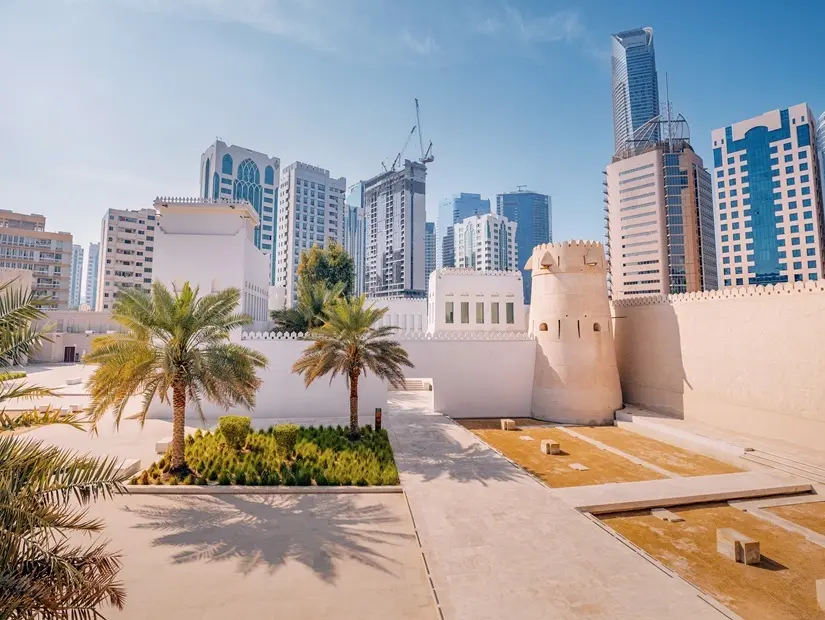 Tarihi Kale Qasr el Hosn'un etrafı palmiye ağaçları ve modern binalarla çevrili