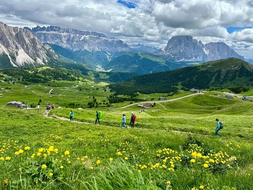 İtalya'nın Güney Tirol eyaletindeki Dolomites şehrinde doğal bir dağ yolunda yürüyen turistler görülüyor. Görüntüde arka planda dramatik Odle Group uçurumlarıyla Seceda yakınlarında yürüyen bir çift görülüyor. 