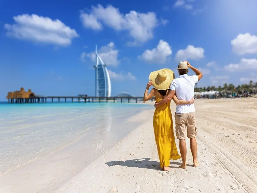 Güzel bir turist çifti Dubai'deki güzel bir plajda sarılıyor