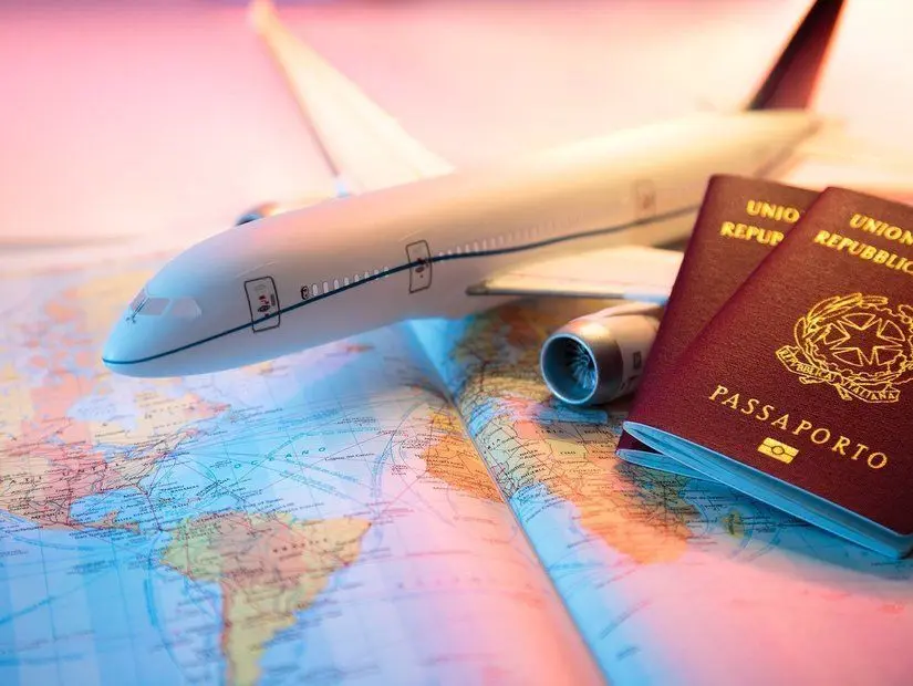 Harita üzerinde pasaport ve uçak maketi