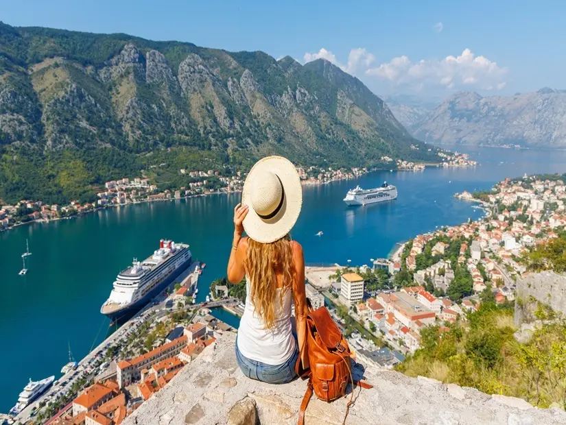 Kotor Körfezi'nin panoramik manzarasının tadını çıkaran kadın turist