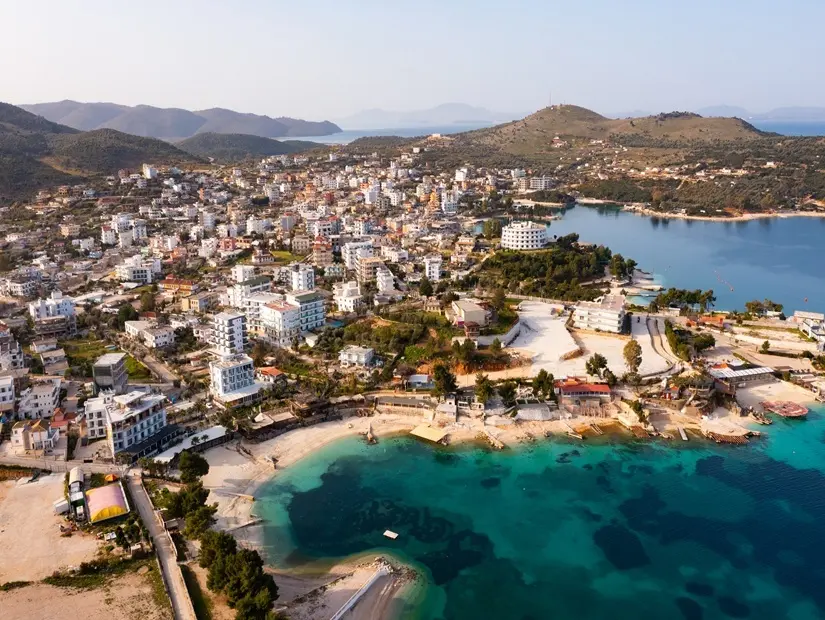 Arnavutluk Rivierası'nda İyon Denizi kıyısındaki Ksamil köyünün yüksek açılı görünümü.