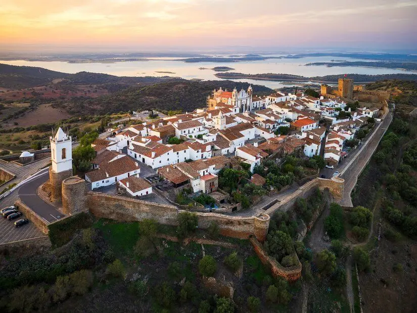 Portekiz'in Alentejo bölgesinde, kale surları içinde yer alan minik ve şirin bir köy olan Monsaraz'ın gün doğumu sırasında çekilmiş havadan görünümü.