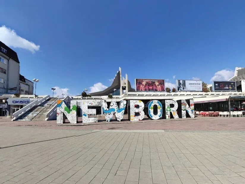 newborn anıtı üstünde ülke bayraklı görünümü