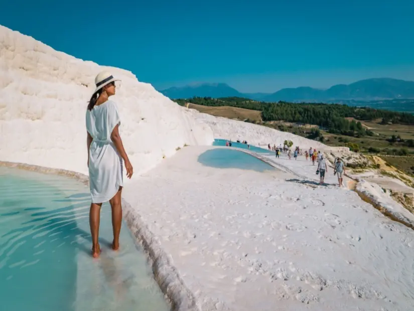  Pamukkale'de doğal traverten havuzları çıplak ayakla gezen turistler