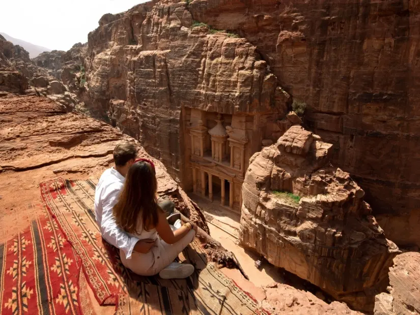 Antik Petra kentinde halı çardakta oturan birkaç gezgin 