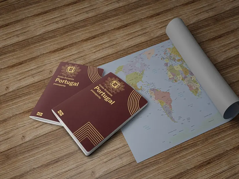Ahşap bir tahta üzerinde rulo halinde harita ve iki Portekiz pasaportu