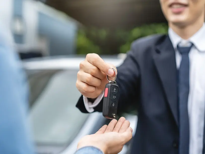 Müşteriye seyahat ve gezi için uzaktan kumandalı anahtar veren kiralık otomobil acentesinin yakın çekim elleri