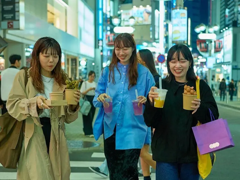 Genç kadınlar gece vakti Tokyo'nun şehir merkezinin tadını çıkarıyor.