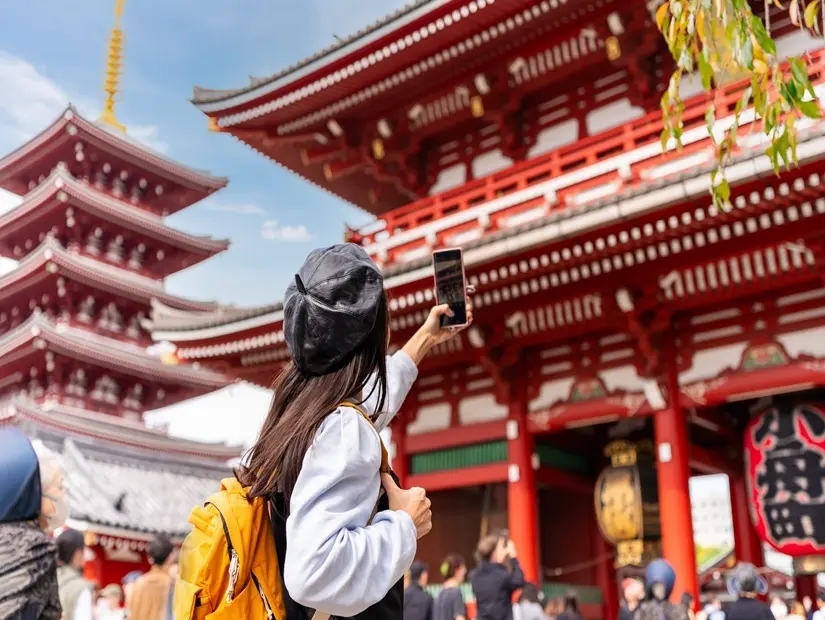 Japonya'nın Tokyo şehrinde Asakusa bölgesinde sensoji tapınağının fotoğrafını çeken genç bayan turist