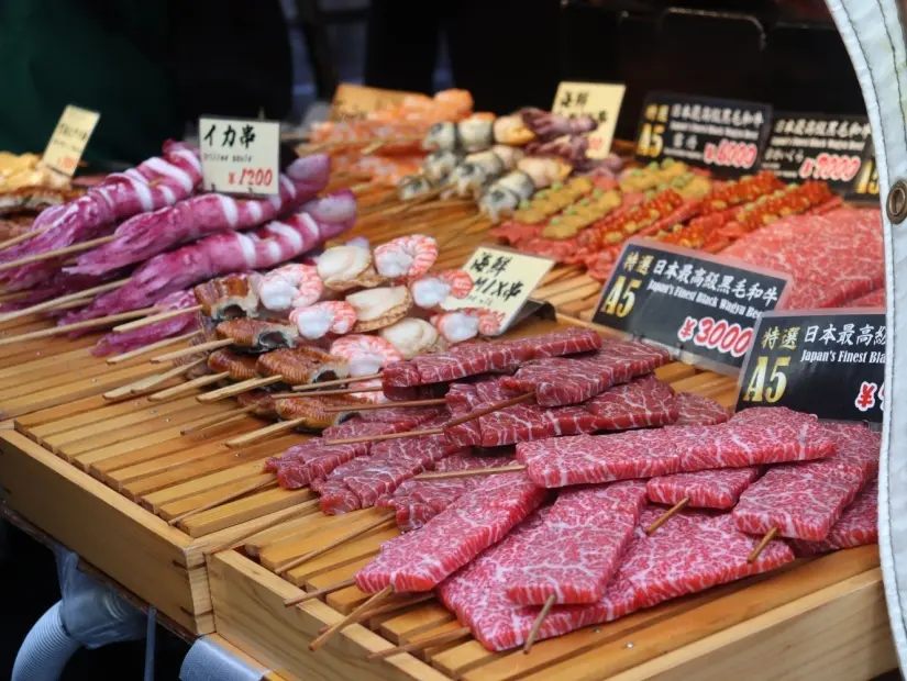 Farklı şişlerin sergilendiği Tsukiji balık pazarı sokak yemekleri