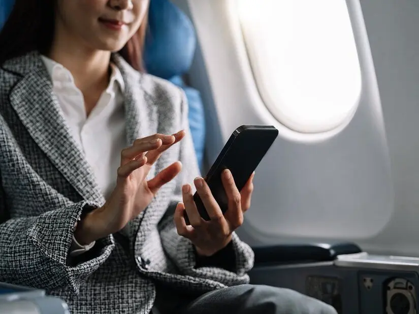 Uçakta telefon kullanan asyalı kadın