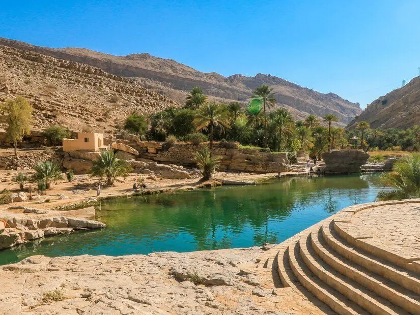 Serinletici suları ve bereketli palmiye ağaçlarıyla Umman'daki çarpıcı Wadi Shab Oasis'i görünümü